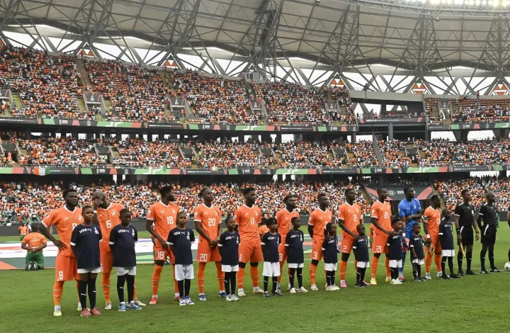 Image de Football. Les Éléphants de Côte d'Ivoire ont traversé un chemin sinueux et périlleux lors de la Coupe d’Afrique des Nations (CAN) 2023, un parcours marqué par des défis inattendus et des revirements spectaculaires. Leur voyage jusqu’aux huitièmes de finale a été une série de hauts et de bas, culminant dans un match décisif contre le Sénégal, le tenant du titre. Ce match, prévu pour se dérouler à Yamoussoukro le 29 janvier, promet d'être une confrontation épique et un tournant crucial pour les Éléphants. Le parcours tumultueux de la Côte d'Ivoire a été ponctué par une défaite cinglante contre la Guinée équatoriale (4-0), une performance qui a presque scellé leur destin. Cependant, un coup du sort sous forme de victoire du Maroc sur la Zambie a permis aux Ivoiriens de se faufiler dans la phase à élimination directe comme l'un des quatre meilleurs troisièmes. Cette qualification inespérée a été un souffle de vie pour une équipe qui semblait déjà au bord de l'abîme. La tension autour du poste de sélectionneur a ajouté à l'atmosphère déjà chargée. La décision de la Fédération ivoirienne de football (FIF) de se séparer de Jean-Louis Gasset, remplacé par Émerse Faé, a soulevé des questions sur l'impact de ce changement sur la dynamique de l'équipe. Les rumeurs autour de la possible venue d'Hervé Renard, un nom bien connu et respecté en Côte d'Ivoire, ont créé un mélange de confusion et d'espoir. Bien que cette piste n'ait pas abouti, l'idée même de son retour a peut-être insufflé une énergie nouvelle à la fois aux joueurs et aux supporters. Dans ce contexte, Émerse Faé, accompagné de son staff, a dû naviguer dans des eaux agitées, prenant les rênes de l'équipe dans un moment de crise. Son approche et sa capacité à se concentrer exclusivement sur la tâche à accomplir malgré les turbulences autour de lui ont été essentielles. La résilience et la détermination de l'équipe, menée par des figures expérimentées comme Serge Aurier, seront mises à l'épreuve contre un adversaire redoutable. Le Sénégal, de son côté, s'est montré solide et convaincant lors du premier tour, avec des victoires impressionnantes contre la Gambie, le Cameroun et la Guinée. Dirigé par Aliou Cissé, une figure respectée et expérimentée, l'équipe sénégalaise est considérée comme le favori pour ce match. Leur performance jusqu'à présent dans le tournoi a été un mélange de tactique disciplinée et d'explosivité offensive, faisant d'eux une menace pour n'importe quelle équipe. Le face-à-face historique entre les deux équipes promet d'être un affrontement captivant. Le Sénégal, armé de sa récente performance et de son titre en cours, affronte une équipe ivoirienne revigorée, déterminée à prouver sa valeur et à écrire un nouveau chapitre de son histoire footballistique. Les supporters ivoiriens, fidèles et passionnés, seront certainement un atout majeur, donnant aux Éléphants l'avantage du terrain et l'énergie nécessaire pour affronter un adversaire aussi redoutable. La question de savoir comment les Éléphants vont aborder ce match est cruciale. Vont-ils adopter une approche défensive, cherchant à neutraliser la puissance offensive du Sénégal, ou opteront-ils pour une stratégie plus audacieuse, exploitant leur propre arsenal offensif ? La réponse à cette question pourrait déterminer le cours du match et, par extension, l'avenir de l'équipe dans le tournoi. Ce match est plus qu'une simple rencontre sportive; il représente un moment déterminant pour les deux nations, une occasion de démontrer leur force, leur talent et leur passion pour le football. Pour la Côte d'Ivoire, c'est une chance de redorer son blason et de prouver que, malgré les obstacles et les défis, elle reste une force avec laquelle il faut compter sur la scène africaine. Alors que le match approche, les fans du football africain et mondial retiennent leur souffle, anticipant un affrontement qui promet d'être à la fois passionnant et imprévisible. Les joueurs sur le terrain vont non seulement se battre pour la victoire, mais aussi pour l'honneur et la fierté de leurs nations respectives. Le résultat de ce match pourrait avoir des implications profondes, non seulement pour les joueurs et les équipes, mais aussi pour les générations de fans et de jeunes footballeurs qui regardent et s'inspirent de ces moments déterminants. En conclusion, ce match entre la Côte d'Ivoire et le Sénégal est bien plus qu'une simple rencontre sportive dans le cadre de la CAN 2023. C'est un symbole de la résilience, du talent et de la passion qui caractérisent le football africain. Ce match est une célébration de l'esprit compétitif et un rappel de la manière dont le sport peut unir les gens, transcendant les frontières et les différences. Quel que soit le résultat, ce match restera dans les mémoires comme un exemple éclatant de ce que le football africain a à offrir au monde. Alors que nous attendons avec impatience ce match, une question demeure : Comment ce moment définira-t-il l'avenir du football africain et l'héritage des deux nations sur la scène internationale?