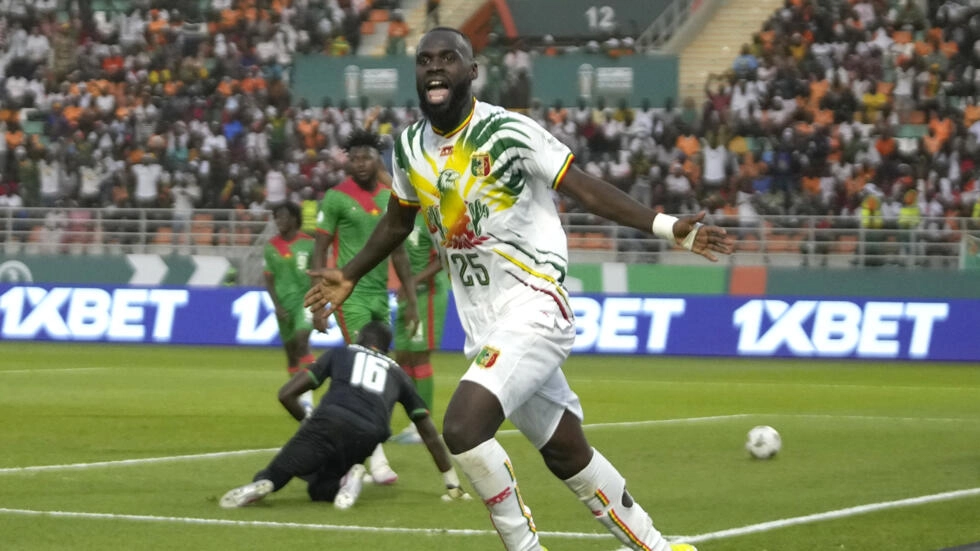 Image de Football. Le Mali a brillamment triomphé sur le Burkina Faso lors de leur rencontre en huitième de finale de la Coupe d'Afrique des Nations 2024, remportant la victoire avec un score de 2-1 le 30 janvier au stade Amadou Gon Coulibaly de Korhogo. Cette victoire a marqué une étape importante pour les Aigles, qui n'avaient pas atteint les quarts de finale depuis leur impressionnante performance en 2013, où ils avaient décroché la troisième place. Dès les premières minutes, le Mali a pris le dessus. Un but contre son camp marqué par Tapsoba du Burkina Faso, suite à un centre de Hamari Traoré et une tête d'Amadou Haidara, a donné l'avantage au Mali. Cette erreur précoce a placé les Étalons dans une position défavorable dès le début du match. Le Mali a continué à dominer, particulièrement au milieu de terrain, où leur présence était indéniable. Kamory Doumbia, une étoile montante du football malien, a fait montre de ses compétences exceptionnelles, créant des occasions dangereuses et mettant à rude épreuve la défense burkinabè. Malgré plusieurs tentatives, les Étalons ont eu du mal à pénétrer la défense malienne, largement menée par un gardien performant. Le Burkina Faso a tenté de reprendre le dessus en deuxième mi-temps, notamment après un pénalty transformé par Bertrand Traoré. Cela a insufflé un nouvel espoir dans l'équipe, mais le Mali a maintenu sa domination. Les Aigles ont continué à presser, cherchant à creuser l'écart, tandis que les Étalons luttaient pour trouver une ouverture. Dans les derniers instants du match, un but du Burkina Faso a été annulé pour hors-jeu, scellant ainsi la victoire des Maliens. Cette victoire n'est pas seulement le fruit d'une performance exceptionnelle lors de ce match, mais aussi le résultat d'un travail acharné et d'une détermination sans faille de l'équipe et de son encadrement technique. Le Mali, avec cette qualification pour les quarts de finale, se prépare à affronter un adversaire redoutable : la Côte d'Ivoire. Ce match promet d'être un affrontement passionnant, mettant en scène deux des meilleures équipes africaines. Les Aigles, portés par leur récente victoire et leur parcours jusqu'ici, auront à cœur de démontrer leur force et leur talent face à un adversaire aussi prestigieux. La performance du Mali dans cette compétition soulève une question importante : jusqu'où peut aller cette équipe dans son parcours au sein de la CAN 2024 ? Avec une telle dynamique et un esprit d'équipe aussi fort, pourrait-on assister à la naissance d'une nouvelle puissance dans le football africain ?