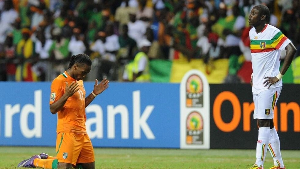 Image de Football. L'excitation règne alors que le Mali se prépare à affronter la Côte d'Ivoire en quarts de finale de la CAN 2023, avec l'ombre d'une malédiction qui plane sur les Aigles depuis des décennies. Le cri de ralliement, "Mali puissanci !", résonne, mais l'historique des confrontations contre les Éléphants suscite des interrogations. Cet article plonge dans l'histoire du derby entre le Mali et la Côte d'Ivoire, explore les témoignages de joueurs et entraîneurs, et évalue les chances des Aigles de briser enfin cette malédiction persistante. Une malédiction persistante Le duel entre le Mali et la Côte d'Ivoire est bien plus qu'un simple affrontement sportif. Depuis leur première rencontre en 1965, les Aigles n'ont réussi à s'imposer que quatre fois en 32 matchs, avec 19 défaites et 9 matchs nuls. Une statistique qui pèse lourdement sur les épaules des joueurs maliens, créant une atmosphère de défi intense à chaque affrontement. Cette malédiction, bien que souvent évoquée, reste un défi que les Aigles aspirent à surmonter. Le cri de ralliement et l'optimisme des supporters "Mali puissanci !", le cri de ralliement qui a résonné dans les stades lors des précédents affrontements, symbolise la détermination des Aigles à surmonter les obstacles. Cependant, face à la perspective d'affronter une équipe ivoirienne souvent victorieuse, l'optimisme des supporters maliens est confronté à la réalité d'une malédiction persistante. À la veille du quart de finale de la CAN 2023, les interrogations et les attentes sont à leur paroxysme. Des générations de joueurs sous l'emprise de la malédiction Cette malédiction semble transcender les générations de joueurs maliens. Les témoignages d'Amadou Pathé Diallo, ancien international malien et ex-entraîneur adjoint de la sélection, soulignent l'ampleur du défi. "J’ai joué cinq ou six matches contre eux, comme joueur ou entraîneur, je n’ai jamais réussi à les battre", confie-t-il, soulignant la persistance de cette malédiction à travers les époques. Même du temps de Salif Keïta, légende du football malien, la Côte d'Ivoire demeurait un adversaire redoutable. La CAN 2012 et la cruelle élimination en demi-finale La CAN 2012 a marqué un tournant dans cette rivalité, avec la Côte d'Ivoire éliminant le Mali en demi-finale (1-0). Alain Giresse, le sélectionneur de l'époque, se rappelle de l'impact psychologique de cette malédiction sur l'équipe malienne. "Être au Mali et évoquer un match contre la Côte d’Ivoire, c’est évoquer un pays qui ne vous réussissait pas", explique-t-il. Cette défaite a ajouté une nouvelle dimension à la malédiction, laissant des traces psychologiques que les Aigles cherchent à surmonter. Le plus grand derby de l'histoire du football malien À la veille du quart de finale crucial de la CAN 2023, les enjeux sont immenses. Pathé Diallo prédit que ce sera "le plus grand derby de toute l’histoire du football malien". Les Aigles, conscients de leur passif face aux Éléphants, sont déterminés à ne pas succomber à une nouvelle défaite. Le défi ne réside pas seulement dans la compétence technique mais dans la capacité à briser une malédiction qui a persisté trop longtemps. Briser la malédiction - Une question ouverte Alors que les Aigles du Mali se préparent à affronter les Éléphants de la Côte d'Ivoire dans ce quart de finale tant attendu, la question demeure : les Aigles pourront-ils enfin briser cette malédiction qui plane depuis des décennies? Le cri de ralliement résonnera-t-il victorieusement ou la malédiction persistera-t-elle? L'histoire du football malien est suspendue à cette question ouverte, prête à dévoiler le prochain chapitre palpitant de cette rivalité intense et historique.