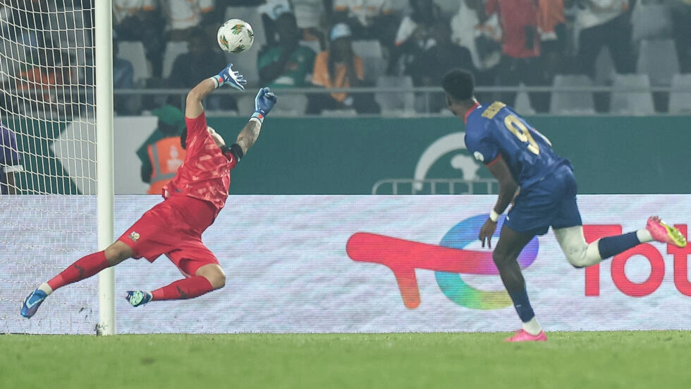 Image de Football. La soirée du samedi 3 février au stade Charles Konan Banny a été le théâtre d'un quart de finale épique entre le Cap-Vert et l'Afrique du Sud, offrant aux spectateurs un spectacle intense. Dans une ambiance déjà électrisée par le miracle ivoirien contre le Mali, ces deux équipes ont livré un duel marqué par la résilience et le suspense, se concluant par la victoire des Bafana Bafana (0-0, 2-1 aux t.a.b). Au cœur de cette bataille, le gardien sud-africain Ronwen Williams s'est révélé être le héros incontesté de la soirée. Un Duel Tactique et Émotionnel Le quart de finale s'est ouvert sur un terrain où l'émotion du miracle ivoirien planait encore, créant une atmosphère particulière. La rencontre entre le Cap-Vert et l'Afrique du Sud n'a pas immédiatement captivé les spectateurs, mais elle a réservé son lot d'émotions. Les deux équipes ont évolué avec détermination, chacune pesant sur la défense adverse à sa manière. Dans la première période, les Bafana Bafana ont montré un dynamisme accru, créant quelques opportunités. Teboho Mokoena a notamment tenté une frappe lointaine, marquant le début des hostilités (10e). Cependant, les hommes d'Hugo Broos ont eu du mal à s'approcher réellement des buts gardés par Vozinha. En revanche, les Requins bleus ont distillé leurs occasions avec parcimonie, créant des moments d'angoisse pour la défense sud-africaine. Le capitaine Ryan Mendes s'est distingué avec une action impressionnante, éliminant un défenseur avant de déclencher une frappe (40e). Une intervention salvatrice d'un joueur sud-africain a préservé le score nul. La seconde mi-temps a vu le Cap-Vert prendre confiance, multipliant les occasions dangereuses. Garry Rodrigues a tenté une percée en profondeur, se présentant face à Ronwen Williams sans succès (55e). Plus tard, une opportunité décisive est tombée dans les pieds de Benchimol, seul face au gardien sud-africain, mais ce dernier a réalisé une parade exceptionnelle en plein temps additionnel. L'Héroïsme de Ronwen Williams Les prolongations ont été nécessaires, et les gardiens ont continué à jouer un rôle déterminant. Vozinha, gardien cap-verdien, a brillé par une double parade remarquable (93e), assurant à son équipe la possibilité de se rendre aux tirs au but. Cependant, c'est Ronwen Williams qui a finalement eu le dernier mot. Le gardien sud-africain a réalisé des arrêts magistraux sur les trois premiers penalties cap-verdiens, brisant les rêves des Requins bleus à chaque occasion. Son exploit s'est conclu par une quatrième parade, scellant la victoire de l'Afrique du Sud. Ronwen Williams, telle une muraille infranchissable, a propulsé son équipe en demi-finale pour la première fois en 24 ans. Une Victoire Saluée et une Perspective de Questionnement La victoire des Bafana Bafana a été saluée par les supporters et les observateurs, soulignant l'exploit réalisé dans cette rencontre tendue. Hugo Broos et ses hommes peuvent remercier leur gardien exceptionnel, Ronwen Williams, qui a su se surpasser dans les moments cruciaux. Cette victoire propulse l'Afrique du Sud vers les demi-finales de la compétition, un moment historique pour l'équipe. Cependant, au-delà de cette célébration, cela soulève des interrogations sur la suite du parcours des Bafana Bafana dans la CAN 2023. Quelles seront les clés de leur succès face à de nouveaux adversaires en demi-finale ? Comment Ronwen Williams et ses coéquipiers maintiendront-ils cette dynamique positive ? Ces questions ouvrent la porte à des analyses et des anticipations passionnantes pour les passionnés de football et les supporters de l'équipe sud-africaine. L'avenir de la compétition réserve-t-il de nouvelles surprises et exploits ? Seule la suite du tournoi nous le dira.