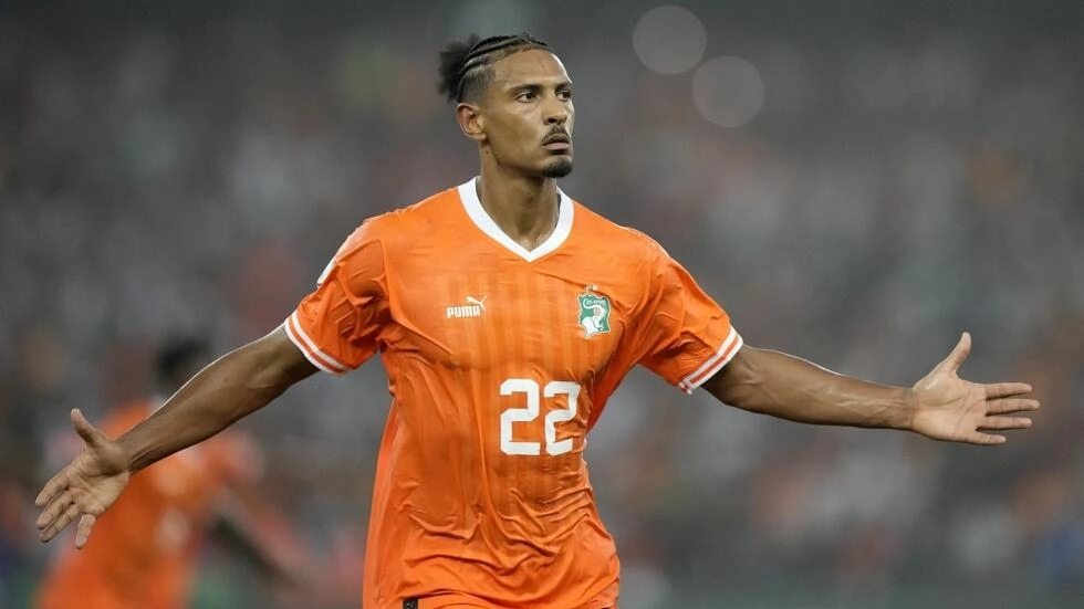 Image de Football. Dans le feu de la Coupe d'Afrique des nations 2023, Sébastien Haller émerge comme le protagoniste d'une résurgence remarquable, propulsant la Côte d'Ivoire en finale. Victime de divers revers ces derniers mois, l'attaquant a, par un but décisif, assuré la victoire face à la République démocratique du Congo, qualifiant ainsi les Éléphants pour la finale face au Nigeria le 11 février prochain. Un Héros Inattendu au Sein des Revenants Ivoiriens Au sein de cette édition de la CAN 2023, marquée par le retour en force des joueurs ivoiriens, Sébastien Haller s'impose comme un héros inattendu. Après un premier tour difficile, les Éléphants ont métamorphosé leur jeu pour atteindre la finale, mais la question qui se pose est celle-ci : quelle épithète attribuer à Haller, le sauveur de la demi-finale contre la RDC ? Un Parcours semé d'Embûches Le destin de Sébastien Haller a pris une tournure difficile à l'été 2022. Après une saison remarquable à l'Ajax Amsterdam, il rejoint le Borussia Dortmund avec les honneurs, destiné à succéder à Erling Haaland. Malheureusement, son ascension est brusquement stoppée par un diagnostic de cancer, le forçant à mettre en suspens sa carrière pour se consacrer à son rétablissement. Bien que le joueur ait rapidement retrouvé les terrains après avoir vaincu la maladie, la saison 2022-2023 s'est avérée ardue en Allemagne. Aucun but en Bundesliga ni en Ligue des champions, une contribution limitée en Coupe d'Allemagne, et un temps de jeu en déclin constant ont caractérisé cette période difficile pour Haller. La CAN 2023 : Entre Blessure et Triomphe La CAN 2023 aurait pu être une bouffée d'oxygène, mais une blessure persistante à la cheville gauche a éclipsé une grande partie de sa compétition. Contraint de se contenter de brèves apparitions en tant que remplaçant contre le Sénégal et le Mali, Haller a dû attendre la demi-finale contre la RDC pour briller. La Rédemption par un But Salvateur En effet, la rencontre contre la RDC a marqué un tournant pour Sébastien Haller. En seconde période, il a délivré un coup de grâce spectaculaire en reprenant de volée un centre de Max-Alain Gradel, propulsant la Côte d'Ivoire en finale. Un moment de gloire qui a résonné dans tout le stade olympique d’Ebimpé et au-delà. Les Mots d'un Buteur Épanoui Après la victoire, Sébastien Haller s'est exprimé avec satisfaction : "Je me sens forcément bien. Je ne peux que savourer parce qu'il y avait de grandes chances que je ne participe pas à la compétition. Il y avait des doutes, pas mal de journées où ça n'a pas été forcément simple, mentalement ou physiquement." Le joueur a souligné le caractère bonus d'être présent à la CAN et exprimé son engagement à aller jusqu'au bout. Le Regard Tourné vers la Finale À l'approche de la finale contre le Nigeria, Haller ne cache pas son ambition : "On a su se remettre en question pour arriver ici. [...] On a mérité notre place en finale. À nous de finir le travail." L'attaquant de Dortmund, fort de ses 9 buts en 25 sélections, nourrit le rêve de la victoire face aux Super Eagles. Un Atout Majeur pour la Finale La Côte d'Ivoire, peut-être encore marquée par les déboires du premier tour contre le Nigeria, trouve en Sébastien Haller un atout majeur pour la finale. Le héros de la demi-finale représente une force déterminante pour les Éléphants, et son retour en grâce symbolise la résilience et la détermination de toute une équipe. Avenir d'un Héros sur les Terrains et au-delà En conclusion, l'histoire de Sébastien Haller à la CAN 2023 transcende le simple récit d'un joueur de football. C'est une saga de résilience, de persévérance et de triomphe. Alors que la Côte d'Ivoire se prépare pour la grande finale, une question plane : quel avenir attend Sébastien Haller sur les terrains et au-delà ? Comment ce héros inattendu continuera-t-il à inspirer et à marquer l'histoire du football ivoirien ? La réponse à ces questions dessinera la trajectoire du joueur et laissera une empreinte durable dans le monde du football africain.