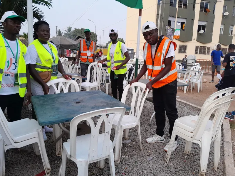 Deuxième Image de Société. Le mercredi 7 février 2024, au cours des demi-finales de la CAN 2023, nous avons plongé au cœur de l'action en rencontrant des bénévoles dévoués au sein de deux villages CAN à Port Bouet. Ces volontaires, recrutés par le Ministère de la Promotion de la Jeunesse, de l'Insertion Professionnelle et du Service Civique, jouent un rôle essentiel dans la réussite de cet événement sportif d'envergure continentale. Le Village CAN du Stade Seyni Fofana À l'épicentre de l'événement, au village CAN du Stade Seyni Fofana, Mlle Touré Awa Bintou, étudiante diplômée en finances comptabilité, dirige avec brio une équipe de 25 personnes. Elle a ouvert les portes de leur quotidien, révélant les diverses responsabilités qui incombent à ces bénévoles. "Depuis le début de la compétition, notre mission englobe la gestion de la salubrité du site, l'assistance aux supporters, et la prise en charge des enfants. Nous veillons également à restreindre l'accès aux enfants non accompagnés, assurant ainsi leur sécurité. En parallèle, nous menons des campagnes de sensibilisation sur des thèmes prédéfinis lors des jours de matchs. Ces thèmes varient, mais ils touchent des questions cruciales telles que les violences basées sur le genre, la drogue, et l'alcool", explique Touré Awa. Sensibilisation et Interaction avec la Population Lors des journées sans match au programme, les bénévoles entreprennent des tournées de sensibilisation, frappant aux portes des habitants pour aborder des sujets sociaux sensibles. "Nous avons abordé divers thèmes, dont les violences basées sur le genre, la drogue, et l'alcool, afin d'éduquer et d'informer la population locale", ajoute-t-elle. Une Affluence Renforcée lors des Matchs des Éléphants Lorsque l'équipe nationale ivoirienne, les Éléphants, entre en lice, le village CAN du Stade Seyni Fofana connaît une affluence remarquable. Touré Awa souligne le défi de gérer les supporters tout en saluant l'appréciation de leur travail. "Les gens nous réclament souvent et viennent s'informer sur notre rôle. Ils sont fiers de notre présence, affirmant que la population a besoin de nous", partage-t-elle. Reconnaissance et Appel à l'Aide Les bénévoles expriment leur gratitude envers les autorités pour cette opportunité unique. Touré Awa souligne, "C'est une excellente initiative de penser à la jeunesse pour cette CAN. Nous sommes fiers de servir notre nation et appelons les autorités à soutenir ceux d'entre nous qui rencontrent des difficultés dans leurs études." Le Village CAN Albatros et Petit Bassam : Une Double Mission Mian Akouba Edith Philippe, en tant que Cheffe d'équipe des Villages CAN Albatros et Petit Bassam, coordonne deux équipes totalisant 35 personnes chacune. Étudiante en transit douane, elle partage les missions polyvalentes de son équipe. "En plus de la sensibilisation, nous assistons les gérants des villages CAN dans des tâches telles que le nettoyage, la disposition des chaises, l'installation, et assurons même un rôle de sécurité. En cas de situations délicates, nous sollicitons l'intervention de la police", explique-t-elle. L'Expérience du Bénévolat : Un Acte Citoyen Passionnant Dem Oumar, étudiant en bâtiment, trouve l'expérience du bénévolat passionnante. "Le bénévolat, c'est donner de soi pour aider les autres. Chacun de nous devrait avoir cet état d'esprit. C'est pourquoi nous avons décidé d'être des bénévoles. Notre présence ici est rassurante", déclare-t-il. Il encourage les autorités à multiplier de telles initiatives lors d'événements futurs. Un Bilan de 20 000 Bénévoles pour la CAN 2023 Dans le cadre de l'organisation de la CAN 2023, le Gouvernement ivoirien a mobilisé 30 000 jeunes, dont 10 000 volontaires et 20 000 bénévoles. La formation préalable des bénévoles, couvrant des thèmes essentiels tels que la responsabilité citoyenne, la communication, la sécurité routière, l'environnement, et la sensibilisation aux violences, a été cruciale pour la réussite de leur mission. Quel Héritage pour la Jeunesse Ivoirienne? Ces bénévoles de la CAN 2023 à Port Bouet incarnent l'esprit du service citoyen. Leurs actions, allant au-delà de l'organisation logistique, contribuent à éduquer, sensibiliser et renforcer les liens au sein de la communauté. Comment cette expérience influencera-t-elle la jeunesse ivoirienne à l'avenir? Quel héritage laissera-t-elle dans la quête d'une société plus responsable et engagée? Ces questions ouvrent une réflexion profonde sur le rôle de la jeunesse dans la construction d'un avenir solide pour la Côte d'Ivoire.