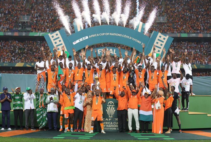 Image de Société. Une soirée mémorable de célébration nationale a embrasé Abidjan le lundi 12 février 2024, alors que les Éléphants de Côte d'Ivoire, fraîchement couronnés champions de la 34e édition de la Coupe d'Afrique des Nations (CAN) de football, ont présenté avec éclat leur trophée au peuple ivoirien. La fièvre festive a culminé au stade Félix Houphouet-Boigny, plébiscité pour l'occasion, après une imposante parade à travers plusieurs communes de la capitale économique du pays. Un Triomphe Applaudi par les Plus Hautes Autorités La scène grandiose s'est déroulée dans un stade comble, résonnant des acclamations passionnées du public. Le Premier ministre ivoirien, Robert Beugré Mambé, les présidents d'institutions, ainsi que de nombreux membres du gouvernement, ont tous répondu présents, ajoutant une touche officielle à cette fête populaire. L'euphorie était palpable, chacun venant saluer la performance exceptionnelle des champions. Les Eléphants ont été les protagonistes incontestés de cette soirée inoubliable. Sous les projecteurs du "Felicia," le stade a vibré au rythme des ovations, applaudissant chaque joueur qui a contribué à cette victoire historique. Les rues d'Abidjan, empruntées par les champions africains, ont été le théâtre d'une parade mémorable, avec une marée humaine de supporters scandant des chants de gloire. Retour Triomphal dans les Rues d'Abidjan Avant la cérémonie au stade, les champions africains ont défilé dans les rues de la capitale économique, accompagnés par une foule en liesse. Le trophée tant convoité a été exhibé fièrement, symbolisant la réussite de la Côte d'Ivoire dans cette compétition acharnée. L'énergie positive dégagée par les supporters a transcendé la simple joie sportive pour devenir une expression collective de fierté nationale. La consécration des Éléphants à la 34e édition de la CAN a atteint son apogée lors de la finale épique qui s'est déroulée le dimanche 11 février 2024, au Stade Alassane Ouattara d'Ébimpé. Face au Nigéria, la Côte d'Ivoire a réalisé un exploit mémorable en remportant le match par un score de 2-1. Une performance qui restera gravée dans les mémoires, consacrant ainsi le statut d'icônes sportives des Éléphants. Hommage au Palais Présidentiel : Un Rendez-vous avec le Président Alassane Ouattara Le mardi 13 février 2024 restera également gravé dans l'histoire, alors que les Éléphants seront officiellement reçus au palais présidentiel d'Abidjan par le président Alassane Ouattara. Un moment d'honneur où la nation entière rendra hommage à ces ambassadeurs du football, mettant en lumière l'impact positif du sport sur l'unité nationale. La Côte d'Ivoire, déjà auréolée de la gloire de la CAN à trois reprises, peut désormais ajouter 2023 à sa liste prestigieuse de victoires. Les triomphes de 1992, 2015, et désormais 2023, soulignent la constance et la puissance du football ivoirien sur la scène continentale.* Alors que la nation célèbre cette victoire éclatante, une question demeure inévitable : Quel avenir attend les Éléphants de Côte d'Ivoire dans le paysage footballistique international? Avec une équipe qui a démontré sa force et son talent exceptionnels, comment la Côte d'Ivoire continuera-t-elle à marquer de son empreinte les compétitions à venir? Autant de réflexions qui guideront les attentes des fervents supporters et amateurs de football dans les mois à venir.