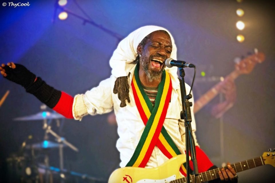 Deuxième Image de Musique/Radio. Prince Saint Florent Serry, alias Jah Prince, naît en 1963 et se profile rapidement comme une figure majeure du reggae franco-ivoirien. Sa passion pour la musique débute en 1977, portée par l'héritage indélébile de Bob Marley et l'influence profonde du mouvement rastafari. Pionnier du reggae africain en France, Jah Prince s'inscrit dans une trajectoire artistique marquée par l'enthousiasme et l'engagement. Un Parcours Scénique Éclatant Sa carrière musicale connaît des moments forts, tels que sa participation à un concert aux côtés de Tiken Jah Fakoly lors d'un festival en 1995. Des prestations au prestigieux Printemps de Bourges et au Gibus, ainsi qu'une tournée des stades en Afrique, ponctuent son parcours scénique éclatant. Jah Prince ne se contente pas de produire des albums ; il offre une expérience vivante à son public, privilégiant la spontanéité sur scène. Conflits avec les Autorités Ivoiriennes : Entre Spiritualité et Répression L'Ombre des Années 1980 Dès les années 1980, les autorités ivoiriennes se montrent réticentes face à Jah Prince, principalement en raison de sa consommation de cannabis associée à sa spiritualité rastafari. Ce choix de vie lui vaut des ennuis récurrents avec les autorités, jetant les prémices d'un conflit qui perdurera tout au long de sa carrière. Prisonniers de Babylone : Entre Répression et Résistance En 2003, Jah Prince sort son album "Prisonniers de Babylone", un projet qui, au lieu de lui apporter la reconnaissance, le plonge à nouveau dans les affres de la répression. La confiscation de son matériel musical et l'accès restreint aux studios d'enregistrement deviennent des obstacles constants sur son chemin artistique. Engagement et Chute lors de la Crise Post-Électorale En dépit de ces défis, Jah Prince n'hésite pas à prendre position contre la violence de la guerre civile ivoirienne et la crise post-électorale de 2010-2011. Son engagement, affirmé publiquement, contribue à précipiter ce qu'il considère comme sa disgrâce. Un témoignage de la difficulté de concilier art et activisme dans un contexte politique complexe. Un Destin Marqué par les Tribunaux et l'Exil La spirale judiciaire s'intensifie pour Jah Prince en 2012, alors qu'il est condamné à un an de prison. En 2014, une sentence encore plus lourde frappe l'artiste avec cinq ans d'interdiction de séjour en Côte d'Ivoire. Ces peines, liées à son mode de vie et ses prises de position, le conduisent à un exil forcé. Grâce au soutien d'un comité français et à l'intervention diplomatique de François Hollande, Jah Prince retrouve la liberté et se réfugie en France. Cependant, loin des projecteurs, il se retrouve à mener une existence de sans-abri, déclarant même être ruiné. Entre Scène et Studio : Une Préférence Affichée Jah Prince se distingue par sa préférence marquée pour la performance sur scène plutôt que pour l'enregistrement en studio. Son album "Prisonniers de Babylone" se dévoile comme un témoignage vivant de cette passion pour la spontanéité et l'authenticité que seule la scène peut offrir. Ses influences variées, de la soul au rocksteady en passant par les sonorités traditionnelles africaines et le jazz, reflètent la diversité de sa formation musicale. Dans une entrevue accordée en 2017, Jah Prince souligne les abus de pouvoir et de gouvernance en Côte d'Ivoire, se positionnant en fervent défenseur de l'altermondialisme et du panafricanisme. Inspiré par des figures majeures telles que Marcus Garvey, Bob Marley, Burning Spear, et Bunny Wailer, il affirme son engagement pour ces idéaux, non seulement en Côte d'Ivoire mais à l'échelle mondiale. En France, Jah Prince marque son soutien au mouvement Nuit Debout à Paris en 2016, en y donnant des concerts gratuits. Ce geste témoigne de son engagement constant pour des causes sociales et politiques qui dépassent les frontières. Lié au mouvement rastafari, Jah Prince réaffirme régulièrement sa foi en Dieu, ajoutant une dimension spirituelle à son parcours déjà marqué par des épreuves et des combats. L'Avenir de Jah Prince : Entre Questionnements et Perspectives Jah Prince, bien que marqué par des épreuves, demeure un artiste iconoclaste en quête de reconnaissance et de compréhension. Ses prises de position, sa spiritualité rastafari, et son approche unique de la musique font de lui un personnage à part dans le paysage musical franco-ivoirien. Alors que l'histoire de Jah Prince continue d'évoluer, la question qui se pose est celle de l'avenir du reggae africain. Comment la musique engagée peut-elle trouver sa place dans des contextes politiques souvent hostiles ? Quel rôle les artistes engagés peuvent-ils jouer dans la construction d'une société plus juste et équitable ? Jah Prince, avec son destin singulier, incarne ces interrogations, ouvrant la voie à des réflexions plus profondes sur le rôle de l'artiste dans la société contemporaine. En conclusion, l'histoire de Jah Prince transcende le simple récit d'un artiste musical. Elle s'érige en témoignage des défis et des possibilités qui se présentent aux artistes engagés, particulièrement dans des contextes politiques complexes. La quête de Jah Prince pour l'authenticité et la justice résonne au-delà de sa musique, invitant à une réflexion collective sur la portée de l'art dans la transformation sociale.