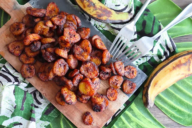 Image de Cuisine. Au cœur de la Côte d'Ivoire, un plat traditionnel émerge des cuisines pour séduire les palais du monde entier : l'alloco. Préparé avec des bananes plantains, ce mets délicieux incarne l'essence même de la gastronomie ivoirienne. À la Découverte de l'Alloco et Signification et Tradition Dans la langue baoulé, parlée par la plus grande ethnie de la Côte d'Ivoire, le mot "alloco" trouve son origine dans la fusion des termes "mûr" et "sucré". Ainsi, l'alloco est bien plus qu'une simple recette, c'est une célébration des saveurs sucrées et mûres des bananes plantains. Ce plat s'inscrit profondément dans la tradition ivoirienne, invitant à des moments de partage et de convivialité autour de la table. Les Ingrédients de l'Alloco et Le Rituel de Préparation de l'Alloco L'alloco, bien que simple dans sa composition, tire sa richesse de l'authenticité de ses ingrédients. Des bananes plantains bien mûres, de l'huile d'arachide savamment sélectionnée, des oignons pour une touche de piquant, et une pincée de sel fin pour rehausser les saveurs. Chaque élément contribue à la création d'une expérience gustative inoubliable. Acte 1 : La Transformation des Bananes Plantains Le rituel commence par l'épluchage délicat des bananes plantains, suivies d'une découpe méticuleuse en cubes. Le demi-oignon, lui, est émincé en fines rondelles, prêt à ajouter une dimension aromatique à cette aventure culinaire. Acte 2 : La Danse de l'Huile d'Arachide L'huile d'arachide, choisie avec soin, fait son entrée en scène dans une friteuse chauffée. Les rondelles d'oignon plongent dans ce bain doré, créant un ballet visuel avant d'accueillir les cubes de bananes plantains. Leur transformation commence, passant d'une teinte claire à un doré appétissant. Acte 3 : La Cuisson Maîtrisée À la fin de la danse dans l'huile d'arachide, les cubes de bananes plantains révèlent leur transformation complète, exhibant une coloration dorée irrésistible. Une étape cruciale, les alloco et les oignons frits sont délicatement égouttés, laissant derrière eux une mélodie de saveurs. Acte 4 : La Touche Finale du Sel Le sel, en saupoudrant légèrement les alloco et les rondelles d'oignon frits, apporte la touche finale, accentuant les saveurs et équilibrant la douceur des bananes plantains. Le résultat : un plat prêt à être dégusté, offrant une symphonie de textures et de saveurs. Le Savoir-Faire Diététique Au-delà de la préparation, l'aspect diététique de l'alloco réside dans la maturité des bananes plantains. Plus elles sont mûres, plus elles offrent une consistance fondante et sucrée. La couleur jaune à marron de la peau indique la maturité idéale, créant une chair qui cède légèrement à la pression. L'alloco, en tant que plat polyvalent, peut être apprécié en solo ou en compagnie d'autres délices ivoiriens. Il se marie parfaitement avec un poisson frit croustillant ou une volaille grillée, créant ainsi un festin complet. Pour une touche d'audace, trempez l'alloco dans une sauce à base de purée de piment, concentré de tomates, ail, oignon et épices, pour une expérience apéritive gourmande et conviviale. Le succès de l'alloco réside dans l'équilibre délicat entre la texture moelleuse et l'absence de trop de gras. Les bananes plantains frites doivent conserver leur moelleux tout en exhibant une légère croustillance, créant ainsi une harmonie de sensations en bouche. En conclusion, l'alloco transcende son statut de plat traditionnel ivoirien pour devenir une expérience culinaire à part entière. Chaque étape de sa préparation est une ode à la tradition, à la convivialité et à la richesse des saveurs. Alors, pourquoi ne pas vous aventurer dans la cuisine ivoirienne et découvrir par vous-même la magie de l'alloco ? Laissez-vous emporter par cette symphonie de goûts et de textures, et posez-vous cette question : Quelle autre merveille culinaire la Côte d'Ivoire nous réserve-t-elle ? La découverte ne fait que commencer.