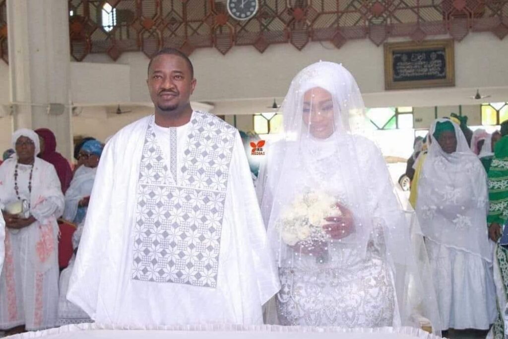 Deuxième Image de Célébrités. C'est une nouvelle qui a pris tout le monde par surprise : l'animateur de télévision bien connu, Eric Sekongo, a prononcé ses vœux de mariage une seconde fois. La cérémonie s'est déroulée le jeudi 29 février à la grande mosquée de la Riviera-Golf à Cocody. Cette décision, qui a suscité étonnement et curiosité, a été précédée d'une demande en mariage publique lors d'un concert de Kendji Girac, artiste français renommé, quelques semaines auparavant. Des Questions et des Interrogations L'annonce du mariage a donné lieu à de nombreuses spéculations et interrogations de la part du public. Eric Sekongo, animateur de longue date à la RTI et anciennement assistant du Directeur général, a surpris ses fans en demandant la main de sa nouvelle compagne lors du concert de Kendji Girac. Cette initiative, bien que romantique, a soulevé des questions sur l'identité de la nouvelle épouse et sur les circonstances entourant son union avec Eric Sekongo. Le mariage de Eric Sekongo et de sa nouvelle épouse, Asta Traoré, s'est déroulé selon les traditions musulmanes, à la grande mosquée de la Riviera-Golf. Cette décision, qui tranche avec les attentes du public, a été perçue comme une surprise supplémentaire. L'absence de la mère de ses enfants lors de cette cérémonie a également suscité des questions sur les raisons de ce choix. Malgré les spéculations et les rumeurs qui ont accompagné cet événement, la cérémonie de mariage a été marquée par une forte présence d'amis, de collègues, de membres de la famille, de personnalités politiques et de journalistes. Le soutien et l'affection témoignés à Eric Sekongo et à sa nouvelle épouse ont souligné l'importance de cet événement dans le cercle social et professionnel de l'animateur. Un Nouveau Chapitre dans la Vie d'Eric Sekongo En plus de son mariage, Eric Sekongo a également été promu au poste de directeur commercial et marketing du groupe RTI, remplaçant ainsi Mariama Da Chagas, qui a pris sa retraite. Cette double annonce a ajouté une dimension supplémentaire à l'événement, suscitant encore plus d'intérêt et d'interrogations de la part du public. Alors que les festivités de mariage se sont achevées et que la vie quotidienne reprend son cours, de nombreuses questions restent en suspens. Quelles sont les raisons qui ont conduit Eric Sekongo à se remarier ? Quel impact cela aura-t-il sur sa carrière et sa vie personnelle ? Autant de questions qui continueront à susciter l'intérêt et la curiosité du public dans les semaines et les mois à venir.