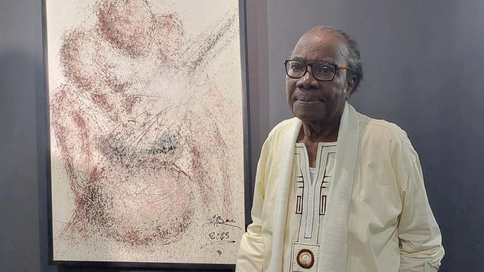 Image de Culture. Au cœur de la Côte d'Ivoire, une figure emblématique de l'art contemporain, Monné Bou, est célébrée à travers une exposition d'envergure. À 80 ans, et avec plus de 50 ans de carrière artistique, Monné Bou incarne l'excellence et l'originalité dans le domaine de la peinture. Son travail novateur, marqué par une technique unique de peinture par jet, fascine et intrigue depuis des décennies. L'Art du Jet : Une Technique Révolutionnaire La singularité de Monné Bou réside dans sa méthode de création artistique. Chaque œuvre est le fruit d'une technique audacieuse et peu conventionnelle : la peinture par jet. Abandonnant toute esquisse préalable, Monné Bou se tient à distance de la toile et éclabousse celle-ci de peinture. Les projections aléatoires donnent naissance à des motifs étonnants, évoquant tantôt des formes d'enfants, tantôt des paysages saisissants. Cette approche, bien qu'insolite, confère à ses œuvres une profondeur et une émotion uniques. Le parcours artistique de Monné Bou est jalonné d'explorations et d'expérimentations. Sa rencontre avec la technique du jet remonte à ses années d'études aux Beaux-Arts de Marseille, en France. C'est là qu'il a découvert les possibilités infinies de cette méthode, initialement utilisée avec de l'encre de Chine pour chasser les mauvais esprits. Depuis lors, Monné Bou n'a cessé d'affiner sa pratique et d'explorer de nouveaux horizons artistiques. Une Exposition Rétrospective et Révélatrice L'exposition en cours offre une rétrospective complète du travail de Monné Bou, mettant en lumière son évolution au fil des décennies. Christelle Mangoua, commissaire de l'exposition, souligne l'évolution de sa technique au fil du temps : « On s'est rendu compte qu’autour des années 1993, 1994, 1995, Monné Bou a changé un tout petit peu. Il a commencé à représenter les pagnes tissés. Plus on évoluait dans les années 2010 à 2020, on est allé un peu sur des lignes en fait, c'est des dessins, je pense qu'il les appelait l'écriture directe et c'est vraiment des dessins qu'il fait, mais très fins. » Au-delà de ses œuvres, Monné Bou a laissé une empreinte indélébile sur la scène artistique ivoirienne en tant que professeur d'université. Nombreux sont les jeunes plasticiens qu'il a influencés, à l'instar d'Isidore Koffi. Ce dernier, surnommé le "tâchiste", s'inspire de la technique du jet initiée par Monné Bou pour créer des œuvres qui lui sont propres. « Le maître Monné Bou, dans la forme de l'œuvre, à une certaine distance, il y a une réalité que nous pouvons percevoir. Les amas de coloris, ce sont des points qui, à une certaine distance, vont construire une image, comme un mouvement. C'est pareil aussi dans mes créations, je tiens compte toujours de l'éloignement. Quand on est plus proche, on a l'impression d'être dans un chaos, mais à une certaine distance de l'œuvre, on voit une scène de vie. Voilà, donc, c'est à travers tous ces éléments graphiques, à travers la tâche, que j'ai retransmis cette vie. » témoigne-t-il. Alors que l'exposition "Monné Bou : le mystère du jet, 50 ans après" bat son plein, une interrogation demeure : quel sera l'avenir de l'art contemporain en Côte d'Ivoire ? À l'heure où de jeunes talents émergent et où les frontières de l'expression artistique sont sans cesse repoussées, quelle place sera réservée aux pionniers tels que Monné Bou dans la narration de cette histoire en perpétuelle évolution ? L'exposition dédiée à Monné Bou offre un voyage captivant à travers le monde fascinant de l'art contemporain ivoirien. Au-delà de l'admiration pour ses œuvres, cette rétrospective nous invite à réfléchir sur la nature de la créativité, sur l'héritage laissé par les maîtres et sur les défis à venir pour les générations futures d'artistes. En somme, elle célèbre un homme dont l'audace artistique a transcendé les frontières et dont l'influence continuera de se faire sentir bien au-delà de son temps.