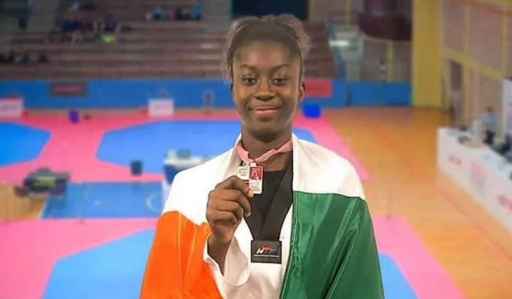 Image de Sport. La talentueuse athlète ivoirienne Kimi Laurene Ossin a ajouté une nouvelle ligne d'or à son palmarès déjà impressionnant lors de sa participation à l'Open d'Espagne 2024. Dans la catégorie des juniors +68 kg, Kimi Laurene a brillé sur les tatamis espagnols, décrochant la médaille d'or avec brio. Parcours d'une Championne Le parcours de Kimi Laurene Ossin dans le monde du taekwondo est marqué par une série de succès remarquables. Depuis ses débuts, elle a gravi les échelons avec détermination, accumulant les victoires et les titres prestigieux. Son récent triomphe en Espagne vient consolider sa position en tant que l'une des athlètes les plus prometteuses de sa génération. En atteignant la première place mondiale chez les juniors filles dans la catégorie des +68 kg, Kimi Laurene a non seulement prouvé son talent sur le ring, mais elle a également établi un nouveau standard d'excellence pour les jeunes athlètes de son pays et d'ailleurs. Un Modèle d'Inspiration Au-delà de ses exploits sportifs, Kimi Laurene Ossin incarne les valeurs fondamentales du taekwondo, telles que la détermination, la persévérance et le respect. Son leadership inspirant et son engagement envers l'excellence en font un modèle pour les jeunes athlètes aspirants à travers le monde. Sa victoire en Espagne n'est pas seulement un témoignage de son talent athlétique, mais aussi de sa capacité à surmonter les obstacles et à exceller dans un environnement compétitif. Un Avenir Prometteur Alors que Kimi Laurene Ossin célèbre sa victoire récente, son avenir dans le monde du taekwondo semble plus brillant que jamais. Avec son dévouement, son talent et son éthique de travail exemplaire, elle est prête à continuer à repousser les limites et à inspirer une nouvelle génération d'athlètes. La question demeure : quelles seront les prochaines étapes pour Kimi Laurene Ossin alors qu'elle poursuit sa quête de l'excellence sportive et continue à représenter fièrement son pays sur la scène internationale ?