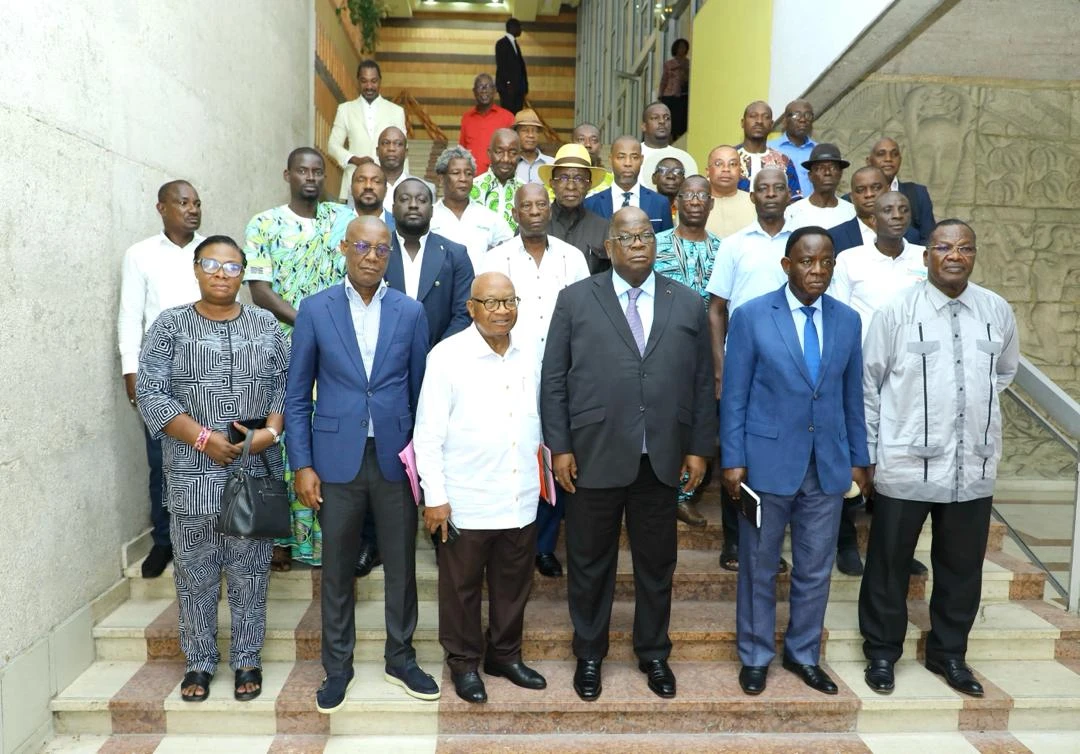 Image de Politique. Vendredi 12 avril 2024, à l'hôtel du district d'Abidjan, le Ministre des Eaux et Forêts, Laurent Tchagba, Président du comité d’organisation (PCO) de la cérémonie d’hommage du peuple Atchan au chef de l’État, a présidé une réunion cruciale. Cette rencontre a été l'occasion d'échanger avec les responsables des différentes commissions engagées dans la préparation de l'événement. Des préparatifs minutieux pour la réussite de l'événement La réunion a été marquée par une analyse minutieuse des différents aspects logistiques et organisationnels, avec une attention particulière portée sur le budget nécessaire à la réussite de cette cérémonie emblématique. Les responsables des différentes commissions ont exprimé leur engagement sans faille, assurant au PCO de leur mobilisation exceptionnelle pour la réussite de l'événement. Au-delà de la mobilisation des Atchans, déjà très enthousiastes à l'idée de rendre hommage au président de la République, Alassane Ouattara, le samedi 27 avril 2024 à Songon Dagbé dans la commune de Songon, le PCO a annoncé la participation attendue des peuples alliés des 3A (Alladjan, Ahïzi et Akouri), des Akyés et des Abourés à cet événement d'envergure. Reconnaissance et gratitude envers le chef de l'État Cette cérémonie d'hommage vise à exprimer la reconnaissance profonde du peuple Atchan envers le président de la République pour sa décision historique de nommer, le 17 octobre 2023, Robert Beugré Mambé au poste prestigieux de Premier ministre, ministre des Sports et du Cadre de vie. Cette nomination est perçue comme un geste fort, saluant les efforts déployés pour le développement et l'amélioration du cadre de vie dans les différents villages de la région. À ce sujet, le ministre Laurent Tchagba a souligné l'importance de cet hommage : "Les populations Atchans ont trouvé que le président de la République a tellement fait pour cette communauté qu'il faille ce jour sortir pour pouvoir lui rendre hommage." L'hommage rendu par les Atchans à Alassane Ouattara soulève des questions sur le rôle des cérémonies d'hommage dans la société ivoirienne contemporaine. Quelle est leur signification sociale et politique ? Et quelle est leur influence sur les dynamiques de pouvoir et de reconnaissance au niveau local et national ?