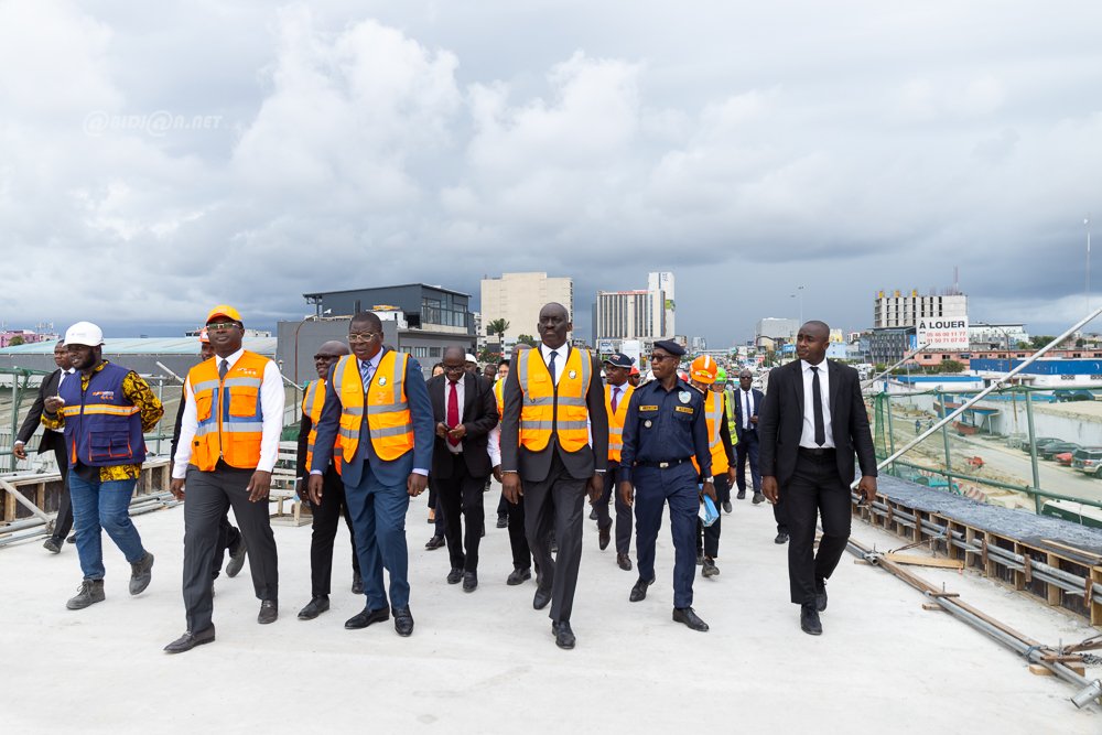 Image de Société. La progression des travaux de construction de la seconde phase de l'échangeur de l'amitié ivoiro-japonaise, également connu sous le nom de l'échangeur de Solibra, marque un jalon important dans le paysage urbain d'Abidjan. Lors d'une visite de chantier tenue le mardi 16 avril 2024 à Abidjan-Marcory, le ministre de l'Équipement et de l'Entretien Routier, Dr Amedé Koffi Kouakou, a annoncé que cette nouvelle branche de l'échangeur serait livrée dans les trois prochains mois. Des Caractéristiques Impressionnantes Dr Amedé Kouakou a dévoilé quelques détails saisissants sur cet ouvrage d'exception. Avec une hauteur culminant à environ 20 mètres, il s'érigera comme la structure la plus élevée de toute la Côte d'Ivoire. Actuellement à 70,1% de taux de réalisation, la finalisation des travaux est imminente. Les étapes restantes impliquent l'application de bitume, l'installation de candélabres pour l'éclairage et divers aménagements routiers. Cet échangeur, fruit d'un don du gouvernement japonais, est une démonstration tangible de l'amitié et de la coopération entre les deux nations. La première phase, inaugurée le lundi 16 décembre 2019 en présence du Chef de l’État, Alassane Ouattara, a marqué le début d'une transformation majeure du réseau routier d'Abidjan. D'une longueur de près de 590 mètres, la seconde phase élargira encore davantage les capacités et les fonctionnalités de cet ouvrage monumental. Impact sur la Circulation L'échangeur de l'amitié ivoiro-japonaise présente des caractéristiques uniques qui devraient améliorer considérablement la fluidité du trafic dans la région d'Abidjan. Dr Amedé Kouakou a souligné que cette nouvelle branche, dédiée aux déplacements de Marcory à Treichville, permettra une circulation plus fluide et sécurisée. En dissociant les flux de circulation et en minimisant les croisements, cet ouvrage vise à optimiser l'efficacité du réseau routier de la ville. Alors que la livraison de la seconde phase de l'échangeur de l'amitié ivoiro-japonaise approche à grands pas, les regards se tournent vers l'avenir de l'infrastructure d'Abidjan. Quels seront les bénéfices tangibles de cette expansion pour les habitants de la région ? Comment cette nouvelle structure influencera-t-elle le développement économique et urbain d'Abidjan ? Ces questions ouvrent la voie à une réflexion approfondie sur l'impact durable de cette avancée majeure dans le paysage urbain ivoirien.