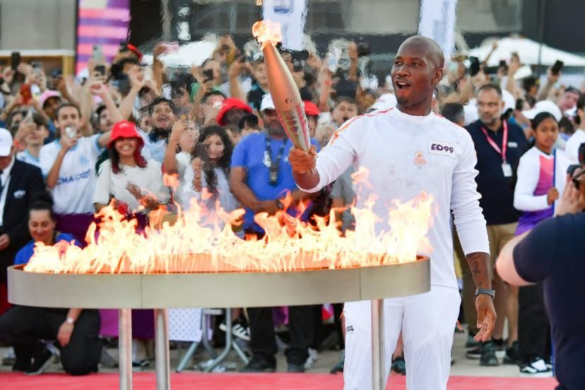 Image de Sport. Après une journée de célébrations intenses, la flamme olympique a achevé son périple marseillais jeudi soir, embrasant le Stade Vélodrome devant une foule en liesse. Ce fut une journée riche en émotions et en symboles, où le sport et la culture se sont entremêlés pour célébrer l'esprit olympique et l'excellence française. Sur les traces des héros Dès le matin, Basile Boli, buteur légendaire de l'OM et héros de la finale de la Ligue des champions 1993, a donné le coup d'envoi de la parade en allumant la flamme devant la basilique Notre-Dame de la Garde. Un parcours haut en couleurs s'est ensuite déroulé à travers les huit secteurs de la ville, jalonné par des relais effectués par des personnalités emblématiques du monde du sport et de la culture. Parmi les porteurs de torche, on a pu compter le rappeur Alonzo, fervent supporter de l'OM, le Ballon d'Or 1991 Jean-Pierre Papin, ancien buteur vedette de l'OM, et la footballeuse internationale Louisa Necib, première femme à fouler la pelouse du Stade Vélodrome avec la flamme. Des ovations nourries ont accompagné leur passage, témoignant de l'enthousiasme du public marseillais. Un moment fort de la journée a été sans aucun doute le relais effectué par le capitaine de l'OM Valentin Rongier et le rappeur Soprano. Après avoir parcouru les tribunes du stade, Rongier a grimpé sur le toit, où il a ensuite passé la flamme à Soprano. Le rappeur, originaire des quartiers nord de la ville, a ensuite effectué un relais spectaculaire sur un étroit couloir-escalier le long de la toiture ondulée du stade, avant de transmettre la flamme à la jeune footballeuse Jenny Perret. Didier Drogba : L'apothéose au Stade Vélodrome C'est finalement Didier Drogba, autre légende du football et icône ivoirienne, qui a eu l'honneur d'allumer le chaudron olympique devant le Stade Vélodrome. Un tonnerre d'applaudissements a salué son arrivée, et l'émotion était palpable dans le stade lorsque l'ancien buteur de l'OM a embrasé la vasque, symbolisant l'ouverture officielle des Jeux Olympiques en France. Cette journée a été l'occasion pour Marseille de célébrer son riche patrimoine sportif et culturel, et de se positionner comme une ville dynamique et accueillante. La flamme olympique, portée par des personnalités issues de tous horizons, a véhiculé un message d'unité et d'espoir, rassemblant les Marseillais et les Français autour des valeurs olympiques. Au-delà de la fête et des symboles, cette étape marseillaise du relais de la flamme olympique a également mis en lumière le potentiel immense des talents français et africains. Comment cette nouvelle génération d'athlètes et d'artistes peut-elle contribuer à façonner l'avenir du sport et de la culture ? Quels sont les défis et les opportunités qui les attendent sur la scène internationale ? La journée du 9 mai 2024 restera gravée dans les mémoires des Marseillais et des Français. La flamme olympique a illuminé la cité phocéenne, laissant derrière elle un sillage d'émotions et d'espoir. C'est désormais le temps du sport et de la compétition, mais aussi l'occasion de célébrer les valeurs d'unité, de respect et d'excellence qui sont au cœur de l'esprit olympique.