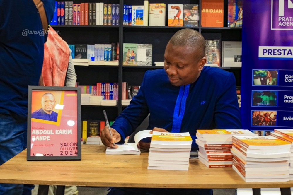 Image de Littérature. En plein cœur du 14ème Salon International du Livre d'Abidjan, Abdoul Karim Bandé, l'auteur renommé, laisse une empreinte inaliénable à travers la présentation de son œuvre de réflexion magistrale : "Banaliser le succès”. Une Œuvre – Un Message "Banaliser le succès" est un livre qui n'est pas juste un témoignage personnel de l'auteur, mais un appel à la réflexion sur notre conception de la réussite. Bandé offre au lecteur une introspection vers une autre perception du succès dans notre société actuelle. L'auteur par cette œuvre, interroge notre tendance à idolâtrer le succès, et propose une redéfinition fondée sur des valeurs plus personnelles plutôt que matérielles. Derrière l’écrivain se cache un homme aux multiples facettes. Fondateur et Directeur Général du Cabinet Salomon Conseils, Bandé est également à la tête de l’Institut Supérieur de Technologies (IST), un complexe scolaire d'envergure. De plus, en tant que coach certifié de l'ICI Genève, il a sensibilisé un grand nombre à l'importance du marketing, du management et du développement personnel. Son expérience, sa vision, assoient l'autorité de son discours et ajoutent du poids à ses réflexions dans "Banaliser le succès”. Bilan et Perspectives La publication de "Banaliser le succès" ouvre sans doute un nouveau chapitre pour Abdoul Karim Bandé. Le luxe de ses expériences et sa profonde compréhension de la complexité humaine l'ont préparé à produire une œuvre aussi puissante et nécessaire pour notre époque. À travers son œuvre "Banaliser le succès", l’auteur Abdoul Karim Bandé éclaire sur le piège du succès idéalisé, un succès qui priorise le matériel sur le spirituel, et propose de redéfinir l'idée de réussite de manière plus authentique. En insufflant son parcours, ses réflexions, son expérience, Abdoul Karim Bandé invite chaque lecteur à une introspection vers une vision plus saine du succès. Une perspective qui conduit de la simple admiration du succès, vers une approche plus introspective, vers la banalisation du succès. Mais la question reste ouverte : sommes-nous prêts à repenser notre conception de la réussite pour embrasser une vision plus enrichissante du succès?