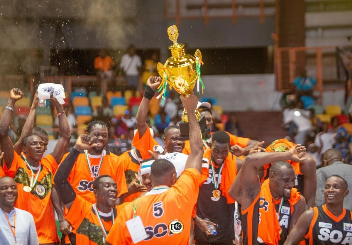 Image de Sport. La 51ᵉ édition de la finale de la coupe nationale de basket-ball, qui s’est déroulée ce lundi 20 mai au Palais des Sports de Treichville, a été marquée par un événement historique : la double victoire de la Société Omnisports des Armées (SOA) chez les hommes et chez les dames. Retour sur cette journée intense où les militaires ont conquis le monde du basketball ivoirien. La Victoire des Hommes La finale chez les hommes opposait l'ABC à la SOA. Dès le début du match, l'ABC a pris les devants en contrôlant le rythme du jeu. Cependant, dans les dernières minutes, l'équipe a montré des signes de faiblesse, notamment en défense. Profitant de cette opportunité, la SOA a renversé la tendance et a pris l'avantage, remportant la partie avec un score de 67-64, soit une victoire avec trois points d'écart. Cette victoire a valu à la SOA le trophée de la coupe nationale, ainsi qu'un chèque de 2 millions de francs CFA. Pour leur performance, les joueurs de l'ABC ont décroché la médaille d'argent et un chèque de 500 000 francs CFA. La SOA succède ainsi à la JCA, marquant un tournant dans l'histoire du basket-ball ivoirien. Chez les dames, la SOA affrontait les joueuses du Groupe des Sapeurs-pompiers Militaires (GSPM). Dans un match serré, la SOA a réussi à s'imposer sur un score de 60-59, décrochant ainsi le titre de championnes de la coupe nationale. Cette victoire leur a permis de succéder à la FBA et de marquer l'histoire du basketball féminin en Côte d'Ivoire. Parité et Reconnaissance Dans un souci d'équité, les femmes de la SOA ont été honorées de la même manière que leurs homologues masculins, recevant le trophée de la coupe nationale et un chèque à la hauteur de leur exploit. Cette reconnaissance souligne l'importance croissante du basketball féminin dans le pays et met en lumière le talent et l'engagement des joueuses de la SOA. Cette double victoire de la SOA marque un tournant dans le paysage du basket-ball ivoirien. Pendant des années, ce sport a été dominé par des équipes telles que l'ABC, la JCA chez les hommes, et la JCAT et l'ABC chez les dames. La montée en puissance de la SOA démontre un changement de garde significatif, mettant fin à la suprématie traditionnelle des anciennes équipes. Alors que la SOA célèbre sa victoire historique, une question demeure : cette performance marque-t-elle le début d'une nouvelle ère de domination pour les militaires, ou s'agit-il d'un moment éphémère dans l'histoire du basket-ball ivoirien ? Seul l'avenir nous le dira, mais une chose est sûre : cette journée restera gravée dans les mémoires comme un moment de triomphe et de changement pour le basket-ball en Côte d'Ivoire.