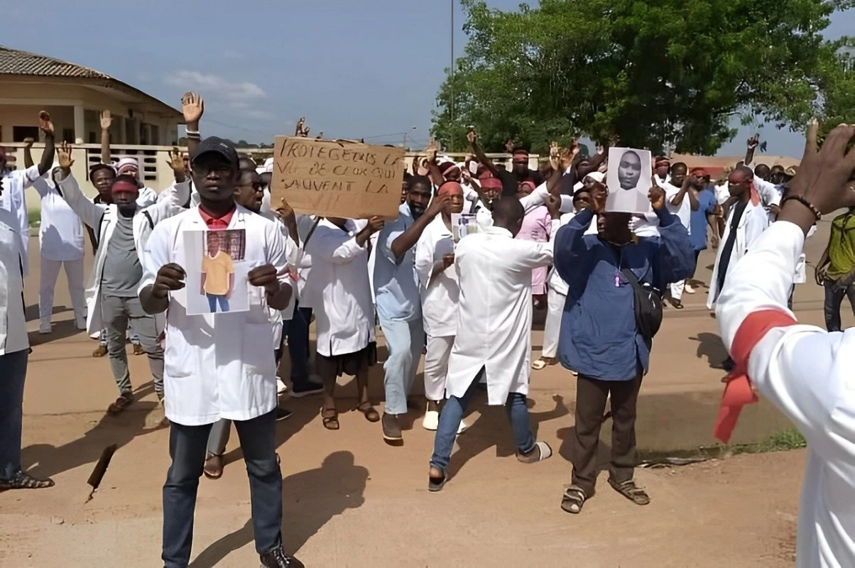 Image de Faits Divers. Le district sanitaire de Sinfra est en deuil suite au meurtre tragique de Kouakou N’da Franck Lionel, technicien supérieur de santé spécialisé en imagerie médicale. Ses collègues, secoués par cette perte, ont exprimé leur chagrin et leur indignation lors d'une marche de protestation organisée le mardi 28 mai 2024 à l’hôpital général. Un Acte Odieux Kouakou N’da Franck Lionel a été abattu chez lui par des inconnus armés dans la nuit du samedi 25 au dimanche 26 mai 2024. Cette attaque brutale a profondément choqué la communauté de Sinfra. Les circonstances exactes de ce crime restent floues, mais une enquête est en cours pour en déterminer les auteurs et les motivations. L'hôpital général de Sinfra était le théâtre d'une mobilisation sans précédent. Les agents de santé, revêtus de leurs uniformes, ont défilé dans les couloirs de l'établissement, brandissant des pancartes et scandant des slogans de protestation. Leur message était clair : protégez ceux qui sauvent des vies. Appel à la Sécurité Cette marche pacifique visait à attirer l'attention des autorités sur la nécessité d'améliorer la sécurité des agents de santé. Ils réclament des mesures concrètes pour garantir leur protection, aussi bien dans leur vie professionnelle que personnelle. La direction de l’hôpital a promis de transmettre les doléances des manifestants aux autorités compétentes. La communauté de Sinfra pleure la perte d'un professionnel dévoué et apprécié. Cette marche de protestation est un rappel poignant des risques encourus par les agents de santé et de l'urgence de renforcer leur sécurité. Comment garantir la sécurité des agents de santé dans un contexte de violence croissante ?