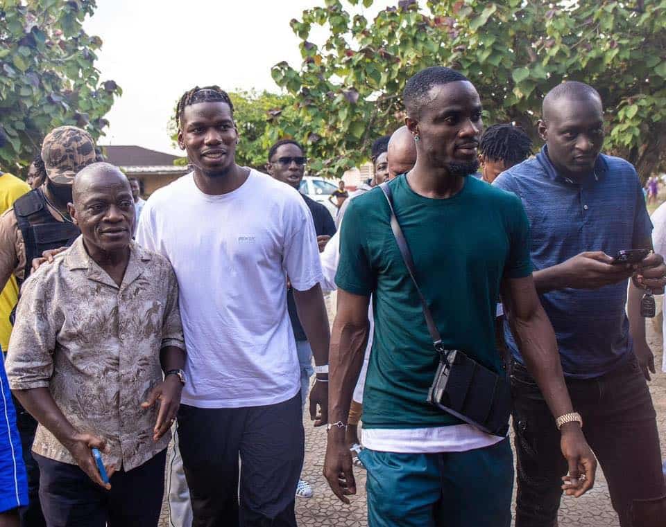 Deuxième Image de Célébrités. Paul Pogba, le célèbre milieu de terrain français, profite de son séjour en Côte d'Ivoire pour marquer positivement la communauté locale. Entre les défis personnels et professionnels, Pogba trouve refuge dans l'acte de donner, illustrant un engagement profond envers les actions sociales. Sa visite à Abidjan n'est pas seulement un moment de détente mais aussi une opportunité d'impacter significativement deux communautés religieuses de la commune de Koumassi. Entre Repos et Engagement Social Pogba, actuellement éloigné des terrains pour des raisons judiciaires et une suspension pour dopage, utilise ce temps à l'écart pour se reconnecter avec ses racines africaines et offrir son soutien là où il le peut. Son absence de la sélection française pour les matches en Allemagne souligne cette période de transition dans sa carrière et sa vie personnelle. Après un passage au Sénégal où il a supervisé des projets de construction d'une grande mosquée à Tivaouane, Pogba arrive en Côte d’Ivoire, où il plonge dans l'ambiance festive d'Abidjan. Toutefois, ce séjour est aussi marqué par un engagement plus profond envers les communautés locales. Accompagné d'Eric Bailly, défenseur ivoirien de Villarreal, Paul Pogba visite la grande mosquée et l'Église catholique de Koumassi. Cette initiative est largement relayée et célébrée sur les réseaux sociaux, démontrant leur volonté de contribuer positivement au-delà de leurs carrières sportives. Les dons effectués par Pogba et Bailly comprennent des aides en nature qui sont cruciales pour ces institutions, jouant un rôle central dans le soutien des populations locales. Ces gestes de solidarité soulignent l'importance de la responsabilité sociale des athlètes de haut niveau. Impact et Perception Publique Paul Pogba n'est pas seulement un joueur de football ; il est également une figure publique influente. Ses actions en Côte d’Ivoire illustrent comment les sportifs peuvent utiliser leur notoriété pour effectuer des changements positifs dans la société. Son engagement montre une facette souvent moins visible de la vie des athlètes, celle de leur contribution à la société en dehors des stades. La réception positive de ses efforts par la population locale et la couverture médiatique encouragent un dialogue sur l'impact des célébrités dans les œuvres caritatives. Cela peut inspirer d'autres figures publiques à suivre son exemple, renforçant ainsi le lien entre succès personnel et engagement communautaire. Le séjour de Paul Pogba à Abidjan transcende le simple divertissement pour devenir un symbole de générosité et d'implication sociale. En ces moments où sa carrière est en pause, il démontre qu'il est possible de rediriger l'attention vers des causes bénéfiques, enrichissant ainsi les vies au-delà des terrains de football. Comment les figures sportives comme Paul Pogba peuvent-elles continuer à influencer positivement les communautés locales après que les projecteurs se soient éteints sur leur carrière professionnelle?