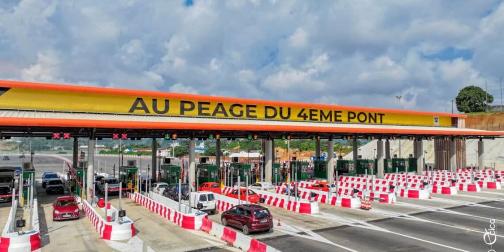 Image de Société. Le lundi 1er juillet 2024, une avancée majeure a été réalisée dans le développement des infrastructures d'Abidjan avec l'inauguration du poste à péage du 4e pont, reliant Adjamé à Yopougon. Le ministre de l’Équipement et de l’Entretien routier, Amédé Kouakou, a officiellement ouvert ce tronçon de 6 kilomètres, attendu de longue date, qui promet de transformer la circulation urbaine et d'améliorer significativement la connectivité dans la métropole. Un Pont Vers le Progrès Ce nouveau pont est plus qu'une simple construction; il symbolise un pont vers le progrès pour les habitants d'Abidjan. Avec ses 6 kilomètres de longueur, il facilite non seulement la mobilité entre deux des quartiers les plus peuplés de la ville, Adjamé et Yopougon, mais agit également comme un catalyseur pour la réduction des embouteillages chroniques qui paralysaient ces zones. Le poste à péage propose une structure tarifaire variée, allant de 500 FCFA pour les motocyclettes à 3 000 FCFA pour les poids lourds. Cette diversification des tarifs a été pensée pour s'adapter à toutes les catégories de véhicules et encourager une utilisation équitable de cette infrastructure vitale. Cette initiative reflète une volonté de rendre la nouvelle voie express accessible tout en assurant un retour sur investissement nécessaire à l'entretien et au développement futur des infrastructures routières. Dès les premiers jours suivant son ouverture, les utilisateurs du 4e pont ont rapporté une amélioration notable de la fluidité du trafic. Les témoignages recueillis soulignent une réduction significative des temps de trajet entre Adjamé et Yopougon, avec une circulation qui s'effectue désormais en toute fluidité sur cette nouvelle artère. Cette amélioration est perçue comme un soulagement considérable par les résidents et les professionnels qui traversent quotidiennement ces deux zones. Une Solution Durable pour le Trafic Urbain L'ouverture du 4e pont d’Abidjan s'inscrit dans une démarche plus large de modernisation des infrastructures de transport de la Côte d'Ivoire. En désengorgeant les axes principaux et en offrant une alternative viable aux routes traditionnellement saturées, ce projet a pour ambition de réduire durablement les congestions, de minimiser les impacts environnementaux du trafic et d'améliorer la qualité de vie urbaine. Malgré les avantages indéniables de cette nouvelle infrastructure, des défis demeurent, notamment en termes de gestion du trafic et de maintenance. La réussite à long terme du 4e pont nécessitera une gestion rigoureuse et une planification urbaine réfléchie pour continuer à répondre aux besoins croissants de mobilité de la population en expansion d'Abidjan. Le 4e pont d'Abidjan est un jalon important dans l'effort continu pour améliorer l'infrastructure urbaine et la mobilité dans la capitale économique de la Côte d'Ivoire. Avec son potentiel de transformer la dynamique de transport de la ville, il pose les bases d'un avenir où la fluidité du trafic contribue au bien-être des citoyens et à la prospérité économique de la région. Alors que cette infrastructure commence à montrer ses premiers impacts positifs, une question reste ouverte : Quelles autres innovations les responsables de la planification urbaine peuvent-ils envisager pour continuer à améliorer la mobilité dans les grandes villes africaines?