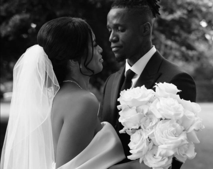 Image de Célébrités. L'attaquant ivoirien Wilfried Zaha, connu pour ses prouesses sur le terrain de football, a récemment partagé un message émouvant sur ses réseaux sociaux pour célébrer le premier anniversaire de son mariage avec sa femme, Paige Bannister. En publiant une photo de leur mariage, Zaha a exprimé son amour et son enthousiasme pour les années à venir aux côtés de sa « reine ». Une Déclaration d'Amour Publique « Aujourd’hui marque un an de mariage et j’ai hâte de vivre de nombreuses autres années avec ma reine ❤️», a déclaré Wilfried Zaha. Ce message, accompagné d’une belle photo du jour de leur mariage, a rapidement capté l’attention de ses fans et followers, générant des milliers de likes et de commentaires de félicitations. Le 14 février 2022, jour de la Saint-Valentin, Wilfried Zaha a demandé en mariage sa fiancée, Paige Marie Bannister. Cette proposition romantique a eu lieu dans une ambiance empreinte d'amour et de complicité, marquant un tournant dans la vie du couple. La décision de Zaha de faire sa demande en ce jour symbolique de l'amour montre l'importance qu'il accorde à leur relation. Le couple s’est ensuite marié à Londres, le 1er juillet 2023. La cérémonie, qui a eu lieu dans une atmosphère intimiste et élégante, a réuni famille et amis proches pour célébrer leur union. Les photos du mariage, partagées par Zaha sur ses réseaux sociaux, montrent un couple radieux et profondément amoureux. En tant que figure publique et star du football, Wilfried Zaha a souvent des agendas chargés et des déplacements fréquents. Cependant, il a su trouver un équilibre entre sa carrière et sa vie personnelle, montrant l'importance de Paige dans sa vie. Leur mariage a renforcé leur lien, et Zaha n’hésite pas à partager des moments de leur quotidien ensemble. Soutien Mutuel Paige Bannister, de son côté, joue un rôle crucial dans la vie de Zaha, offrant un soutien constant. Elle est présente à ses côtés, que ce soit pour célébrer ses succès ou pour le soutenir lors des défis. Leur relation est un exemple de partenariat basé sur le respect mutuel et l'amour. Les fans de Wilfried Zaha ont été ravis de voir leur idole partager un moment aussi personnel. Les messages de félicitations ont afflué, montrant l'affection et le soutien de sa base de fans. Beaucoup ont souligné la beauté de leur couple et ont souhaité de nombreuses années de bonheur à venir. En partageant sa vie personnelle, Zaha contribue à humaniser la figure du sportif professionnel, montrant que derrière l’athlète se trouve une personne avec des émotions et des relations profondes. Cette transparence et cette ouverture renforcent son lien avec ses fans, qui apprécient de voir des aspects plus personnels de sa vie. Wilfried Zaha et Paige Bannister incarnent un couple moderne et soudé, dont la relation inspire de nombreux fans. Leur premier anniversaire de mariage est une occasion de célébrer leur amour et de regarder vers un avenir radieux ensemble. Comment les figures publiques comme Wilfried Zaha peuvent-elles influencer positivement les perceptions des relations amoureuses et de l'équilibre entre vie professionnelle et personnelle auprès de leurs fans?