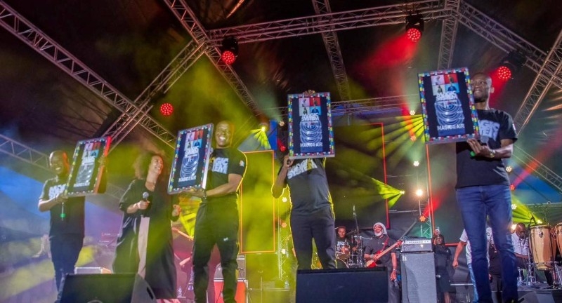 Image de Musique/Radio. Le groupe zouglou ivoirien Magic System a ajouté un nouveau joyau à sa couronne de succès internationaux. Le vendredi 5 juillet 2024, lors d'une cérémonie surprise au festival "Do you Remember" à Taverny, France, le quatuor a été honoré avec un triple disque de diamant pour leur hit mondial "Magic in the Air". Cette distinction, remise en présence d'un public fervent, marque une étape significative dans la carrière déjà étoffée du groupe. Un Moment de Célébration à Taverny La soirée du festival a été électrisée par une surprise de taille lorsque Juliette Fievet et Driver sont montés sur scène pour décerner ce prix prestigieux à Magic System. Traoré Salif, plus connu sous le nom d'A'Salfo et leader vocal du groupe, a exprimé sa joie : "Une grosse surprise hier au Do you Remember festival à Taverny. Irruption inattendue... pour nous remettre officiellement devant un parterre de fans". L'événement a été un moment de reconnaissance spectaculaire pour le groupe, soulignant leur impact continu sur la musique mondiale. "Magic in the Air" a été un tournant dans la carrière de Magic System, enregistrant plus de 15 millions de streams depuis sa sortie. Ce titre, qui mélange rythmes africains et mélodies entraînantes, a non seulement dominé les charts mais a aussi capté l'esprit festif de nombreuses célébrations à travers le monde. Son succès retentissant a transcendé les frontières, faisant danser des auditeurs de tous horizons sur les airs festifs de ce tube international. La Trajectoire de Réussite de Magic System Depuis leur formation à Abidjan dans les années 90, Magic System a constamment élargi leur influence bien au-delà des côtes de la Côte d'Ivoire. Avec une discographie riche et diversifiée, le groupe a accumulé une série de récompenses qui témoignent de leur excellence et de leur capacité à toucher un public global. "On doit maintenant créer de la place pour le triple disque de diamant de 'Magic In the Air'. Merci à Dieu pour ce parcours", a déclaré A'Salfo, réfléchissant au chemin parcouru depuis leurs humbles débuts. Au-delà de leurs succès commerciaux, Magic System a joué un rôle crucial dans la diffusion de la culture zouglou sur la scène internationale. Leurs chansons ne sont pas seulement des hits ; elles sont des vecteurs de la culture ivoirienne, introduisant le monde à la richesse des rythmes et des histoires de l'Afrique de l'Ouest. Leur musique sert de pont entre diverses cultures, prouvant que la musique peut être un puissant moyen de communication et d'unité. Le triple disque de diamant pour "Magic in the Air" n'est pas seulement une victoire pour Magic System, mais aussi une affirmation de la puissance de la musique zouglou comme force globale. Alors que le groupe continue de récolter les fruits de leur talent et de leur travail acharné, ils posent également la fondation pour les futures générations d'artistes africains sur la scène mondiale. En célébrant ce nouveau jalon, une question demeure : comment Magic System continuera-t-il à influencer et à modeler l'avenir de la musique mondiale ?