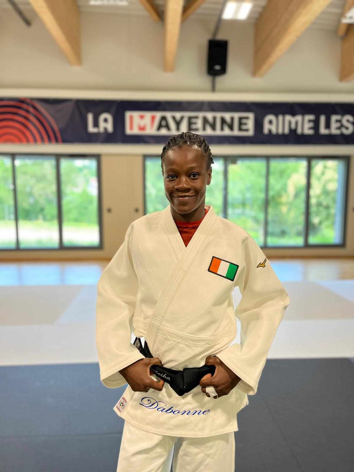 Image de Sport. À l'approche des Jeux Olympiques de Paris 2024, Zouléhia Dabonné, unique judokate ivoirienne en compétition, se prépare à marquer l'histoire. Résidant en France depuis 2020, elle s'entraîne intensément à Château-Gontier avec des athlètes internationaux, sous la supervision de son entraîneur Rodrigue Chenet. Après des participations moins fructueuses à Rio 2016 et Tokyo 2020, Dabonné est déterminée à exceller sur le sol français. Une Préparation Méticuleuse Dans le calme de la Mayenne, Dabonné peaufine sa technique et sa stratégie pour les Jeux. Entourée de partenaires d'entraînement de Cuba, de la République centrafricaine et de France, elle se dit prête à relever les défis à venir. "Les deux précédents Jeux, je n'avais pas d'expérience. À Rio, c'était un peu complexe, il y avait la peur qui m'habitait. À Tokyo, j’ai eu des soucis de concentration. Pour Paris, tout va bien. Je suis motivée et prête", confie-t-elle. L'expérience est un atout que Dabonné compte bien exploiter. Ayant appris de ses précédentes olympiades et d'autres compétitions majeures, elle ajuste continuellement son approche. "Je peux créer la surprise. Si le jour J, je suis en pleine forme, il y aura beaucoup de surprises. Je revois constamment mes compétitions pour m'améliorer", explique la judokate de 31 ans, qui a déjà remporté l'argent au championnat d'Afrique 2023. Pour Paris 2024, les objectifs de Dabonné sont précis et ambitieux : atteindre le podium. "Je ne dirais pas que je veux la médaille d’or, d’argent, ou de bronze spécifiquement. Je veux être sur le podium, peu importe la couleur. C'est mon dernier objectif olympique, et je veux donner le meilleur de moi-même", affirme-t-elle avec détermination. Un Rôle de Modèle Représenter la Côte d'Ivoire en judo est une responsabilité que Dabonné prend très au sérieux. Elle est consciente de l'impact de sa performance non seulement sur sa carrière mais aussi sur l'inspiration qu'elle peut offrir à d'autres athlètes ivoiriens et africains. "Je vais être la seule ivoirienne à représenter la Côte d'Ivoire au niveau du judo. Les attentes sont fortes, mais c'est une pression positive. Je donnerai tout pour ne pas avoir de regret", dit-elle, motivée par le désir de faire vibrer son pays. Paris 2024 représente plus qu'une compétition pour Dabonné ; c'est l'apogée de sa carrière olympique. "Paris 2024 sera ma dernière compétition olympique. Je ne pense pas à Los Angeles 2028. Je veux quitter le tatami olympique sur une bonne note, sans regrets", confie-t-elle, envisageant l'avenir avec une mixture d'anticipation et de mélancolie. Alors que les Jeux de Paris approchent, Zouléhia Dabonné se prépare à écrire une page importante de sa carrière et de l'histoire sportive ivoirienne. Avec détermination et expérience, elle vise non seulement à surpasser ses performances passées mais aussi à laisser une empreinte durable sur le judo et le sport africain. Avec le soutien de son pays et une préparation intense, quelle influence Zouléhia Dabonné pourrait-elle avoir sur la prochaine génération de judokas ivoiriens et africains?