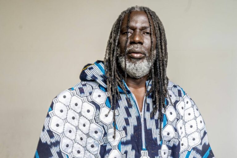 Image de Célébrités. Tiken Jah Fakoly, figure emblématique du reggae africain et fervent critique des systèmes politiques en Afrique, a récemment provoqué une onde de choc dans le paysage musical et politique avec la sortie de son nouveau titre, « Actualités Brûlantes ». Cette chanson marque un retour remarqué de l'artiste ivoirien, qui s’était montré relativement discret ces dernières années. À travers cette nouvelle œuvre, Fakoly n'hésite pas à adresser un message acerbe aux gouvernements de l'Afrique de l'Est, en particulier ceux de l'Association des États de l'Afrique de l'Est (AES). Sa critique directe, néanmoins, a suscité une vive réaction parmi les partisans de l’AES, notamment sur les plateformes sociales. Ce retour sur le devant de la scène met en lumière le rôle des artistes dans les débats politiques contemporains et la tension entre liberté d'expression et réceptivité politique. Tiken Jah Fakoly : Un Retour Muscial Chargé de Politique Tiken Jah Fakoly est bien connu pour ses prises de position audacieuses et ses critiques acerbes envers les régimes politiques africains. Son engagement à travers la musique a souvent été un moyen de dénoncer les injustices et de porter des messages de changement social. Toutefois, après une période de relative discrétion, où ses apparitions publiques et ses sorties musicales étaient devenues rares, Fakoly a fait un retour éclatant le 8 août 2024 avec son nouveau titre, « Actualités Brûlantes ». Cette chanson, réalisée en collaboration avec Amen Jah Cissé, aborde divers thèmes d'actualité brûlants, mêlant critique sociale et politique. La mélodie, bien que typiquement ancrée dans le reggae, est un véhicule pour des messages puissants qui interrogent l'état de la liberté d'expression dans l'Association des États de l'Afrique de l'Est (AES). En tant qu'artiste engagé, Fakoly utilise sa musique pour attirer l'attention sur ce qu'il considère comme des dérives autoritaires et des violations des droits fondamentaux. Dans « Actualités Brûlantes », Tiken Jah Fakoly exprime son mécontentement face aux gouvernements de l’AES, un groupe régional d’États africains. Les paroles de la chanson, telles que « Ne gâtez pas l’AES. La liberté d’expression, mangée par la révolution acquise dans le sang. Regardez ce qui se passe dans l’AES. Dès que tu critiques un peu, c’est le front ou la prison », sont un appel direct à l’action, dénonçant ce qu'il perçoit comme une répression croissante des voix dissidentes dans la région. L'artiste ivoirien semble interpeller les dirigeants de l’AES sur la manière dont ils traitent les critiques et la liberté d'expression. Son message est clair : il dénonce la persécution des voix critiques et la répression des opinions divergentes. En utilisant sa plateforme pour ce faire, Fakoly renoue avec ses anciennes habitudes de provocateur politique, ce qui lui a valu une réputation d'artiste engagé. Cette prise de position n'est pas sans conséquence. Elle s’inscrit dans une longue tradition de musiciens africains qui utilisent leur art pour contester les pouvoirs en place et appeler au changement. Réactions des Partisans de l’AES : Une Tempête Numérique Les critiques de Tiken Jah Fakoly n’ont pas tardé à susciter une réaction virulente de la part des partisans des gouvernements de l’AES. Sur TikTok, un réseau social particulièrement influent parmi les jeunes, les créateurs de contenu pro-AES ont réagi en masse. De nombreuses vidéos ont été publiées, critiquant ouvertement les paroles du chanteur et le qualifiant d’« offensant » et de « provocateur ». Certains internautes ont même menacé de supprimer les morceaux de Fakoly de leurs appareils, exprimant ainsi leur désaccord non seulement avec le contenu de la chanson mais aussi avec l’artiste lui-même. Cette réaction intense illustre la polarisation des opinions dans la région et la manière dont la musique peut devenir un champ de bataille pour les débats politiques. En dépit de la tempête médiatique qui s’abat sur lui, Tiken Jah Fakoly a choisi de garder le silence. En s'abstenant de répondre aux critiques, il semble vouloir maintenir une certaine distance avec le tumulte médiatique, préservant ainsi sa position de critique indépendant. Cette stratégie est également indicative de la manière dont les artistes engagés gèrent les controverses entourant leurs œuvres. La Musique comme Arène Politique : Les Défis de la Liberté d'Expression en Afrique La situation actuelle soulève des questions cruciales sur le rôle de la musique et des artistes dans les débats politiques. En Afrique, où les régimes autoritaires et les restrictions sur la liberté d'expression sont fréquents, les artistes comme Tiken Jah Fakoly jouent un rôle essentiel en mettant en lumière les injustices et en défendant les droits humains à travers leurs œuvres. Le cas de Fakoly illustre les défis auxquels sont confrontés les artistes engagés dans des contextes politiques répressifs. La musique, en tant que forme d'expression culturelle puissante, peut servir à mobiliser l'opinion publique et à critiquer les abus de pouvoir. Cependant, elle peut également susciter des réactions hostiles de la part des autorités et des partisans des régimes en place. En Afrique, la musique a souvent été un vecteur de contestation et de changement social. Les artistes engagés utilisent leurs plateformes pour aborder des sujets sensibles et appeler au changement. Néanmoins, ils doivent naviguer dans un environnement parfois hostile où les critiques peuvent entraîner des répercussions significatives. Le choix de Tiken Jah Fakoly de rester silencieux face aux critiques suscite des interrogations sur sa stratégie. Ce silence peut être interprété comme une forme de résistance face aux attaques ou comme un moyen de concentrer l'attention sur le message plutôt que sur les réponses aux critiques. En effet, pour un artiste de sa stature, chaque déclaration ou réaction peut avoir des répercussions sur sa carrière et son image publique. En choisissant de ne pas répondre aux attaques, Fakoly pourrait chercher à éviter d'aggraver la situation et à maintenir l’intégrité de son message. Ce silence pourrait également refléter une période de réflexion personnelle ou une stratégie visant à conserver une certaine distance avec le tumulte médiatique. Le retour de Tiken Jah Fakoly avec « Actualités Brûlantes » soulève des questions importantes sur la relation entre la musique et la politique, particulièrement en contexte africain. Alors que la chanson de Fakoly a été accueillie par des critiques acerbes de la part des partisans de l’AES, elle rappelle également le pouvoir de la musique en tant qu’outil de critique sociale et politique. Les artistes engagés jouent un rôle crucial dans la dénonciation des abus de pouvoir et la promotion des droits humains. Cependant, leur engagement peut également les placer en position de vulnérabilité face aux réactions des autorités et des partisans des régimes en place. Le cas de Tiken Jah Fakoly illustre les défis auxquels sont confrontés les artistes lorsqu’ils choisissent de s'attaquer aux structures de pouvoir en place. La question qui reste en suspens est la suivante : Comment les artistes peuvent-ils continuer à utiliser leur voix pour critiquer les injustices tout en naviguant dans un environnement politique souvent hostile et répressif ?