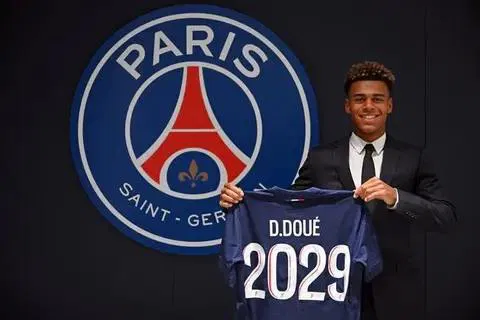 Image de Football. L’arrivée de Désiré Doué au Paris Saint-Germain marque un tournant significatif dans la carrière du jeune prodige ivoirien. À 19 ans, il quitte Rennes pour rejoindre le club phare de la Ligue 1, PSG, avec un transfert estimé à 50 millions d’euros. Une décision qui suscite des interrogations sur son avenir et celui du club. Cet article se propose d'explorer les implications de ce transfert pour le PSG, pour le joueur, ainsi que pour le football français et international. Une Ascension Fulgurante depuis Rennes Formé au Stade Rennais, Désiré Doué n’est pas un nom inconnu pour les amateurs de football. Dès ses premiers pas sur le terrain, il a su se distinguer par son jeu, son intelligence tactique et sa capacité à se fondre dans le collectif tout en apportant sa touche personnelle. À Rennes, Doué a gravi les échelons avec une rapidité déconcertante, s'imposant comme l'un des milieux de terrain les plus prometteurs de sa génération. Le Stade Rennais, connu pour son académie de jeunes talents, a souvent été un tremplin pour de nombreux joueurs qui ont par la suite brillé sur la scène européenne. Doué a su tirer parti de cette structure, se forgeant une réputation solide en Ligue 1. À seulement 19 ans, il a non seulement marqué des buts décisifs mais a aussi démontré une maturité rare pour son âge, devenant rapidement indispensable à l'équipe rennaise. L’intérêt du Paris Saint-Germain pour Doué ne date pas d’hier. Depuis plusieurs mois, le club de la capitale suivait de près les performances du jeune joueur. Son choix de rejoindre le PSG, plutôt que de répondre aux sirènes du Bayern Munich, est révélateur de ses ambitions. En intégrant l'effectif du PSG, Doué s'offre une vitrine exceptionnelle pour se mesurer aux meilleurs joueurs du monde et évoluer sous la houlette d'un staff technique parmi les plus compétents du football européen. Ce transfert, qui a coûté au club parisien la coquette somme de 50 millions d’euros hors bonus, montre également la confiance placée en lui par la direction du PSG. Ce n’est pas simplement un achat de potentiel mais un investissement stratégique pour l’avenir du club. "Nous croyons en son talent et en son avenir au sein de notre équipe," a déclaré un membre de la direction du PSG. Avec une telle somme, le PSG espère que Doué apportera fraîcheur et dynamisme à un milieu de terrain souvent critiqué pour son manque de créativité. Intégrer une équipe comme le PSG, où l'exigence de performance est omniprésente, représente un défi de taille pour tout joueur, encore plus pour un jeune comme Doué. Le club, qui vise toujours plus haut avec l’ambition de remporter la Ligue des Champions, a besoin de joueurs capables de faire la différence dans les moments cruciaux. Doué devra prouver qu'il a non seulement le talent mais aussi la résilience mentale pour s'imposer dans un tel environnement. Le PSG, depuis plusieurs années, cherche à bâtir une équipe qui puisse rivaliser avec les plus grands clubs européens. L’arrivée de Doué s'inscrit dans cette stratégie à long terme. Le joueur, quant à lui, devra trouver sa place dans un effectif où la concurrence est féroce. Toutefois, ses performances passées laissent penser qu'il a les armes pour relever ce défi. L'acquisition de Doué par le PSG n'est pas seulement une bonne nouvelle pour le club parisien mais aussi pour la Ligue 1 dans son ensemble. En gardant un tel talent en France, la Ligue 1 renforce sa position comme un championnat capable de retenir et de développer de jeunes joueurs prometteurs. À une époque où les meilleurs talents français sont souvent tentés par un départ précoce à l'étranger, l'exemple de Doué montre qu'il est encore possible de bâtir une carrière de haut niveau en restant dans l'Hexagone. La Ligue 1, souvent critiquée pour son manque de compétitivité par rapport aux autres grands championnats européens, se retrouve ainsi avec un atout supplémentaire. L'intégration de Doué au PSG pourrait inspirer d'autres jeunes talents à suivre une trajectoire similaire, contribuant ainsi à l'enrichissement du championnat français. Les Attentes Autour du Jeune Ivoirien À Paris, les attentes sont énormes. Les supporters, les dirigeants et les observateurs du football ont tous les yeux rivés sur ce jeune milieu de terrain qui a montré des qualités exceptionnelles lors de ses passages à Rennes. Sa capacité à s'adapter à un environnement aussi exigeant que celui du PSG sera déterminante pour la suite de sa carrière. Doué devra rapidement trouver ses marques dans un collectif où chaque match est une bataille et où l'erreur n'est que rarement tolérée. Sa polyvalence sur le terrain, capable de jouer aussi bien en position de milieu central que de numéro 10, sera un atout précieux pour l’entraîneur. Cependant, il devra aussi faire face à une pression médiatique sans précédent, à la hauteur des espoirs placés en lui. L'arrivée de Désiré Doué au PSG ne concerne pas seulement le joueur et son nouveau club. Ce transfert pourrait bien redéfinir les équilibres au sein du football français. Rennes, qui perd l’un de ses joyaux, devra trouver un remplaçant à la hauteur, tandis que les autres clubs de Ligue 1 observeront de près comment ce transfert impactera la dynamique du championnat. Par ailleurs, ce mouvement pourrait aussi influencer le marché des transferts en Ligue 1, avec d’autres clubs souhaitant profiter de la manne financière générée par les gros transferts pour renforcer leurs effectifs. Le PSG, quant à lui, continue de consolider son statut de club dominant en France, capable d'attirer et de retenir les meilleurs talents nationaux. Ce transfert intervient dans un contexte particulier pour le PSG, un club en quête de renouveau après plusieurs saisons où la Ligue des Champions s'est refusée à eux. Avec l’arrivée de jeunes talents comme Doué, le club espère injecter un nouveau dynamisme dans un effectif qui a parfois semblé à bout de souffle lors des grands rendez-vous. L’entraîneur du PSG, dont la mission est de redonner une identité de jeu claire à l’équipe, pourra compter sur Doué pour incarner ce renouveau. Sa jeunesse, combinée à son expérience en Ligue 1, pourrait bien être la clé d'un PSG plus compétitif sur la scène européenne. La question qui reste en suspens est celle de l'avenir de Désiré Doué au PSG. Sera-t-il à la hauteur des attentes, devenant un pilier du milieu de terrain parisien pour les années à venir ? Ou ce transfert marquera-t-il simplement une étape dans une carrière qui prendra une autre direction ? Seul le temps le dira. En conclusion, l’arrivée de Doué au PSG s’inscrit dans une stratégie ambitieuse, à la fois pour le club et pour le joueur. Mais au-delà des chiffres et des attentes, ce transfert pose une question fondamentale : comment ce jeune prodige ivoirien va-t-il transformer son potentiel en réussite sur la scène internationale ?