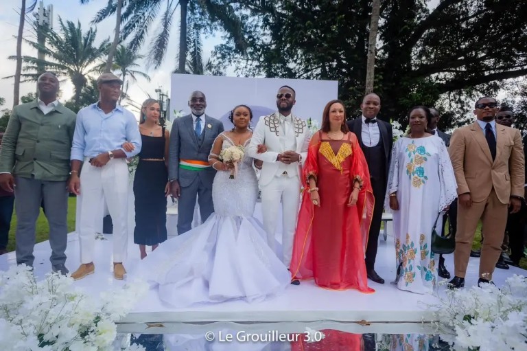 Image de Célébrités. Le samedi 28 septembre 2024, l’artiste ivoirien Kerozen, de son vrai nom Yobo Constant Joël, a scellé son union civile avec sa fiancée Bintou Coulibaly lors d'une cérémonie mémorable à l'hôtel communal de Cocody. Cet événement a attiré un parterre de personnalités influentes, tant du monde de la culture que du sport et de la politique. En présence d'invités prestigieux tels que Didier Drogba, Samuel Eto’o et Françoise Remarck, ministre de la Culture, cette journée a marqué une étape importante dans la vie de l’artiste, devenu une figure emblématique de la scène musicale ivoirienne. Retour sur un mariage somptueux qui a captivé l’attention des médias et du public. Un mariage civil en grande pompe à Cocody Kerozen, véritable icône de la musique ivoirienne, a officialisé son union avec Bintou Coulibaly dans un cadre tout aussi symbolique : l’hôtel communal de Cocody. Cette cérémonie civile, très attendue, a réuni plusieurs figures emblématiques du monde artistique, politique et sportif, illustrant l’ampleur de la notoriété de l’artiste. Le choix de l’hôtel communal de Cocody, lieu emblématique de la capitale économique ivoirienne, a renforcé l’aspect solennel de cet événement. Les jeunes mariés, vêtus avec élégance et simplicité, ont attiré l'attention de nombreux curieux venus apercevoir l'une des unions les plus attendues de l'année. Le mariage civil a été suivi d'une réception encore plus grandiose au prestigieux Sofitel Hôtel Ivoire, un établissement de luxe à Abidjan, où une multitude de stars étaient présentes pour célébrer l’amour de Kerozen et Bintou. Cet événement n'a pas seulement marqué un tournant personnel pour le chanteur, mais a également souligné son statut de star incontournable de la musique et du divertissement en Côte d'Ivoire. L’un des aspects les plus marquants de ce mariage a été sans doute la liste impressionnante d'invités de renom. Parmi les invités, deux légendes du football africain se sont particulièrement démarquées : Didier Drogba et Samuel Eto’o, dont la présence a contribué à rendre cette cérémonie encore plus médiatisée. Didier Drogba, ancien capitaine des Éléphants de Côte d'Ivoire et véritable légende du football mondial, a félicité les jeunes mariés, affirmant que "cette union est un signe de plus de la maturité de Kerozen, tant sur le plan personnel que professionnel". Samuel Eto’o, icône du football camerounais et actuel président de la Fédération camerounaise de football, a également exprimé sa joie pour l’artiste, qu’il considère comme un symbole de réussite et de résilience. Outre ces deux grandes figures du sport, la ministre de la Culture, Françoise Remarck, a honoré de sa présence cette union, soulignant l’impact culturel et artistique de Kerozen en Côte d'Ivoire. Son intervention a été marquée par un message de soutien à l'artiste et à tous les créateurs de la nouvelle génération qui, comme lui, portent haut les couleurs du pays sur la scène internationale. Une soirée glamour au Sofitel Hôtel Ivoire Après la cérémonie civile, la fête s’est poursuivie au Sofitel Hôtel Ivoire, où un somptueux dîner a réuni des figures emblématiques du showbiz ivoirien. Parmi les invités, des stars de la musique telles que Serge Beynaud, Debordo Leekunfa, et Molare, qui sont non seulement des confrères de Kerozen, mais également des amis proches. Les célébrations ont pris une tournure encore plus festive avec la présence de DJ tels que Mulukuku DJ, Arsenal DJ et des influenceurs comme Apoutchou National, qui ont apporté leur touche de bonne humeur à cette soirée mémorable. La scène musicale ivoirienne, riche et vibrante, s’est retrouvée pour une nuit de fête, marquée par des performances impromptues, des danses endiablées et une atmosphère de fraternité. Les personnalités publiques comme Camille Makosso, Eunice Zunon, Ahmed Ouattara et Willy Dumbo, connues pour leur influence médiatique et leur engagement sur les réseaux sociaux, ont également participé aux festivités. Leurs présences ont contribué à renforcer l’impact médiatique de l’événement, chacun partageant des moments forts de la soirée sur leurs plateformes, offrant ainsi aux fans un aperçu exclusif de cette union. Kerozen, à travers ses nombreux succès musicaux tels que "La Voix autorisée", est devenu une figure centrale de la musique ivoirienne. Sa carrière, marquée par une résilience exemplaire, a inspiré des millions de fans à travers l’Afrique. Son parcours, qui l’a vu passer de DJ à Abidjan à star internationale, est le reflet d’une détermination sans faille et d’un talent incontestable. Cette union avec Bintou Coulibaly symbolise un nouveau chapitre dans la vie de l’artiste. En prenant le temps de célébrer son amour devant ses proches et ses pairs, Kerozen montre qu'il est désormais prêt à construire une vie personnelle aussi réussie que sa carrière musicale. Ce mariage, scruté par les médias, est la preuve que l'artiste ne cesse de gagner en maturité, consolidant ainsi son image de leader dans le paysage artistique ivoirien. Une cérémonie religieuse marquante et pleine de sens Quelques jours avant la cérémonie civile, Kerozen et Bintou Coulibaly avaient déjà uni leurs destins lors d’une cérémonie religieuse dans une mosquée. Ce moment intime, qui s’est déroulé le 26 septembre 2024, avait également attiré l'attention des médias. La dimension spirituelle de ce mariage a été particulièrement importante pour le couple, qui a souhaité inscrire son union dans un cadre de foi et de valeurs partagées. Ce mariage religieux, marqué par la sobriété et l'émotion, a permis à Kerozen de démontrer une fois de plus l’importance qu’il accorde aux traditions et à la spiritualité. Cette double célébration, à la fois religieuse et civile, montre un artiste profondément attaché à ses racines, tout en étant ouvert aux influences modernes et globales. Le mariage de Kerozen avec Bintou Coulibaly n’a pas seulement été un événement personnel, il a également eu un impact médiatique considérable. La couverture de cette union par les médias ivoiriens et internationaux a montré à quel point l’artiste est désormais un acteur clé non seulement de la scène musicale, mais aussi de la sphère publique. Les réseaux sociaux, en particulier, ont été inondés de messages de félicitations de la part des fans et des célébrités présentes à l’événement. Les hashtags #MariageKerozen et #KerozenBintou ont rapidement fait le tour des plateformes, générant des millions de vues et de partages. Ce mariage a donc renforcé la visibilité de l’artiste, consolidant encore davantage sa popularité et son influence. Le couple a ainsi montré qu’au-delà de la musique, leur union reflète des valeurs d’amour, de respect et de partage, des valeurs chères à une grande partie de la jeunesse ivoirienne. Une nouvelle ère pour Kerozen ? Alors que Kerozen poursuit son ascension dans l'industrie musicale, ce mariage semble marquer le début d’une nouvelle phase dans sa vie. L’artiste, déjà couronné de succès, semble prêt à relever de nouveaux défis tant sur le plan personnel que professionnel. Ses prochains projets musicaux, qui suscitent déjà une grande attente chez ses fans, pourraient bien refléter cette nouvelle maturité acquise à travers son expérience personnelle. Le soutien des nombreuses stars présentes à son mariage témoigne de la place centrale qu’occupe désormais Kerozen dans l’univers culturel ivoirien. Mais au-delà des paillettes et du glamour, ce mariage a surtout mis en lumière l’humilité et la reconnaissance de l’artiste envers ceux qui l’ont toujours soutenu. Avec une carrière en constante évolution, un mariage qui a attiré l’attention du public et des médias, et un avenir prometteur tant dans la musique que dans sa vie personnelle, une question reste en suspens : quelle sera la prochaine étape pour Kerozen ? Sera-t-il capable de continuer à inspirer à travers ses œuvres tout en consolidant sa place parmi les plus grands noms de la scène africaine ?