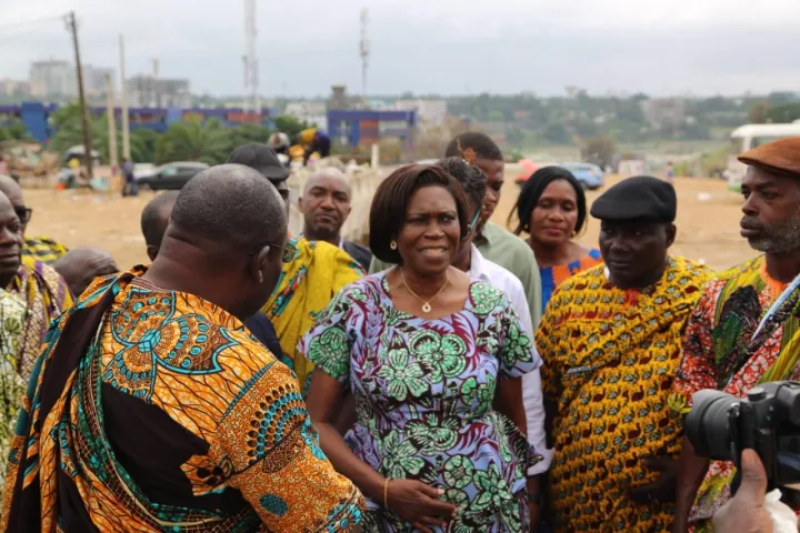 Image de Société. Le village d’Abidjan-Adjamé ne parvient toujours pas à panser ses blessures. Le vaste espace déblayé des décombres témoigne de l’ampleur des destructions subies, et la mémoire des habitants reste marquée par ce jour fatidique du 25 juillet 2024. Dans la violence et le chaos, les habitants ont vu leurs maisons s'effondrer, leurs souvenirs balayés, leurs espoirs anéantis. Malgré cette tragédie, la communauté reste déterminée, portée par une volonté farouche de demeurer sur sa terre ancestrale. Retour sur ce drame et la visite de soutien de Simone Ehivet Gbagbo aux villageois endeuillés. Une nuit de chaos : Destruction brutale à Abidjan-Adjamé Les habitants d’Abidjan-Adjamé ne sont pas près d’oublier cette funeste nuit du 25 juillet 2024. Vers 5 heures du matin, les bulldozers ont envahi le village, accompagnés d'hommes armés de gourdins, de pierres, et même de pistolets. Sans préavis, les maisons ont été détruites, laissant des familles entières dans la rue. "Ils sont venus tout casser alors que les gens dormaient. Des femmes, choquées, sont sorties nues dans la rue, mais ils ont continué à tout démolir", raconte le secrétaire général de la chefferie. Le village entier a été pris de court. Les bâtiments symboliques, tels que la chapelle catholique, l'église harriste, la maison du chef et celle de sa mère, ont été réduits en gravats, sans distinction. Pendant le ramassage des débris, de nombreux objets de valeur ont été retrouvés, témoignages muets de la violence de cette intervention : des bijoux en or, des vêtements, des souvenirs précieux à jamais enfouis sous les ruines. "Il ne s’agissait pas seulement de détruire des structures, mais de rayer un héritage culturel et historique de la carte", déplore un habitant. Simone Ehivet Gbagbo, à la tête d'une forte délégation de son parti, le MGC, a effectué une visite à Abidjan-Adjamé le jeudi 3 octobre 2024 pour constater le déguerpissement. Deux mois après le drame, elle est venue exprimer sa solidarité, dire "Yako" à la population meurtrie, et témoigner son soutien aux habitants du village dévasté. Son discours, empreint de compassion, visait à apaiser et encourager les villageois à maintenir leur dignité et leur cohésion. "Nous avons été choqués par ce que nous avons vu et entendu. Il était important que nous venions nous-mêmes pour parler avec vous et comprendre", a déclaré Simone Gbagbo à la population réunie. L’ancienne Première Dame a rappelé l’importance historique d’Abidjan-Adjamé, un village Atchan dont les origines remontent bien avant la colonisation. Elle a dénoncé l’irrespect des accords passés avec les autorités, soulignant que les droits des communautés autochtones doivent être protégés et respectés par ceux qui sont au pouvoir. "Nous aurions pu trouver une population furieuse, belliqueuse après tout ce calvaire. Mais je vois une population meurtrie mais calme. Je rends grâce pour cela", a-t-elle ajouté, visiblement impressionnée par la résilience et la dignité des habitants malgré l’épreuve subie. Le chef du village, Nangui Boua Chérubin Urbain, ne décolère pas. Lors de la rencontre avec Simone Gbagbo, il a exprimé son incompréhension face à l'usage de la force et à la présence de "voyous armés" pour exécuter ce qu’il appelle "un acte gouvernemental". "Il y a de quoi avoir peur", a-t-il confié, rappelant le sentiment de vulnérabilité et d'injustice ressenti par la population. Malgré tout, le chef reste déterminé : "Nul ici ne dit qu’il n’a plus de village. D’une seule voix, nous parlons de notre village. Nous sommes convaincus de rester sur nos terres. Nous ne voulons que demeurer sur ce site originel", a-t-il affirmé. Ses paroles ont été accueillies par des acclamations des villageois, confirmant leur volonté inébranlable de rester sur leur terre natale, en dépit des pressions et des destructions. Les habitants d’Abidjan-Adjamé ont exprimé leur frustration face au non-respect des engagements pris par les autorités. "Nous avions eu des discussions, il y avait des promesses. Pourquoi ont-ils choisi de ne pas tenir parole ?", se demande un ancien du village, ému. Cette question hante les esprits et alimente un sentiment de trahison au sein de la communauté. Un soutien symbolique : Simone Gbagbo apporte des dons au village La visite de Simone Ehivet Gbagbo n'était pas qu'une simple démarche de solidarité. Arrivée aux environs de 10 heures, elle a été accueillie chaleureusement par la chefferie qui lui a souhaité "Akwaba". Après avoir pris la mesure des dégâts causés par les destructions, elle s’est rendue à la chefferie pour une rencontre avec les chefs traditionnels, avant de se diriger vers le foyer où l’attendaient les habitants du village. Devant une foule majoritairement composée de femmes, l’ancienne Première Dame a su trouver les mots pour réconforter. Ayant passé une partie de son enfance à Abidjan-Adjamé, elle a évoqué ses souvenirs, rappelant combien ce village a compté dans sa vie. "C’est ici que j’ai grandi, que j’ai appris la vie communautaire, la solidarité", a-t-elle déclaré, visiblement émue par les témoignages des anciennes qui ont tout perdu. Pour manifester son soutien de manière concrète, Simone Gbagbo n’est pas venue les mains vides. Elle a offert au village 4 200 articles scolaires, destinés aux enfants qui ont vu leurs études perturbées par les événements. "Les enfants sont notre avenir. Malgré ce que vous avez vécu, il est essentiel de leur donner la chance de réussir", a-t-elle affirmé, sous les applaudissements de l’assemblée. En plus des articles scolaires, d'autres dons ont été remis pour aider les familles à surmonter cette période difficile. Le village d’Abidjan-Adjamé n’est pas un simple quartier. C’est un lieu chargé d’histoire, symbole de la résistance culturelle des Atchan face aux transformations urbaines d’Abidjan. Situé au cœur de la capitale économique, ce village est depuis longtemps la cible de pressions pour céder la place à des projets immobiliers. Mais pour ses habitants, Abidjan-Adjamé est bien plus qu’un territoire. C’est une identité, un lien ancestral qui ne peut être rompu. "Abidjan-Adjamé est la capitale des Bidjan, un symbole de notre culture et de notre histoire", rappelle le secrétaire général de la chefferie. La destruction des maisons et des lieux de culte, tels que la chapelle catholique et l'église harriste, est perçue comme une tentative de rayer ce patrimoine. Pour les habitants, rester sur leurs terres n’est pas une option, c’est une nécessité pour préserver leur culture et leur histoire. La situation d’Abidjan-Adjamé est révélatrice des tensions qui existent entre la modernisation rapide des villes africaines et la préservation des droits des populations autochtones. Les pressions exercées pour transformer ces espaces en zones résidentielles modernes mettent en péril l’existence même de communautés qui, depuis des générations, sont les gardiennes de ces territoires. "Il ne s’agit pas seulement de maisons, mais de notre mémoire, de notre identité", martèle le chef du village. Entre promesses brisées et quête de justice : Quelle suite pour Abidjan-Adjamé ? La visite de Simone Ehivet Gbagbo a apporté un réconfort moral aux habitants d’Abidjan-Adjamé, mais de nombreuses questions restent en suspens. La communauté attend toujours des réponses des autorités sur les raisons qui ont conduit à cette destruction brutale, sans respect des accords initiaux. Les promesses de relocalisation ou de compensation restent, pour l’instant, sans suite. Pour les villageois, la lutte continue. Ils ont fait part de leur volonté de saisir les autorités compétentes, voire d'entamer des démarches judiciaires pour que justice soit rendue. "Nous ne pouvons pas laisser cet acte impuni. Nous avons le droit de vivre sur nos terres, et nous continuerons à nous battre pour cela", a affirmé un représentant de la chefferie, déterminé à obtenir réparation. Simone Gbagbo, de son côté, a promis de faire entendre la voix des habitants auprès des instances gouvernementales, rappelant que le respect des droits des populations locales est une condition indispensable à la paix sociale. "Il est impératif que le gouvernement entende la souffrance de ces familles et trouve une solution juste", a-t-elle insisté, exhortant les autorités à prendre leurs responsabilités. L’histoire d’Abidjan-Adjamé est malheureusement emblématique de nombreux villages urbains en Afrique, confrontés aux pressions de la modernisation et du développement urbain. Alors que la croissance des villes continue d'accélérer, la question se pose de savoir comment protéger les droits des communautés autochtones tout en permettant le développement des infrastructures. Peut-on concilier le respect des identités culturelles avec la nécessité de moderniser les villes africaines ? Quel équilibre peut être trouvé entre les intérêts économiques et le droit des populations à vivre dignement sur leurs terres ancestrales ? Le cas d’Abidjan-Adjamé est un appel à la réflexion sur le futur des villes africaines, sur la place que nous voulons accorder à l’histoire, à la culture, et aux populations qui en sont les gardiennes.