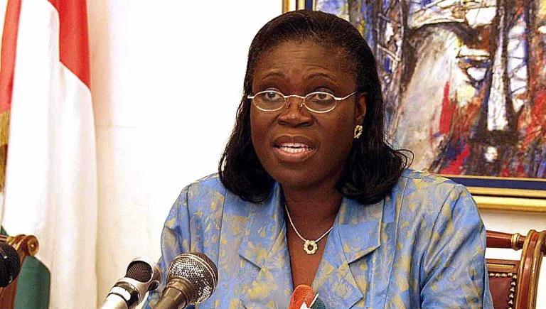 Image de Politique. Simone Ehivet Gbagbo, surnommée "la Dame de fer" en Côte d'Ivoire, est une figure politique incontournable et controversée, connue pour son courage, sa vision et sa persévérance. Ayant été Première Dame de Côte d'Ivoire pendant la présidence de Laurent Gbagbo, elle a non seulement marqué l’histoire par son influence politique, mais également par ses positions fermes et souvent tranchées sur des sujets clés, tant sur le plan national qu’international. À travers son parcours, Simone Gbagbo a inspiré des générations de femmes et d’hommes en Côte d'Ivoire, tout en suscitant débats et controverses. Sa biographie est celle d’une militante qui a surmonté de nombreux obstacles pour défendre ses convictions. Les premières années et les origines Simone Ehivet Gbagbo est née le 20 juin 1949 à Moossou, un village proche de Grand-Bassam en Côte d'Ivoire. Elle grandit dans une famille modeste et catholique, où elle est inculquée dès son jeune âge des valeurs de discipline, de travail et de persévérance. Son enfance est marquée par le respect des traditions et des valeurs chrétiennes, un héritage spirituel qui influencera plus tard son parcours politique et personnel. Très tôt, Simone Ehivet démontre une aptitude pour les études et un sens aigu de l’engagement communautaire. Elle est connue pour sa vivacité d'esprit et sa capacité à défendre ses idées, même à une époque où les femmes étaient rarement encouragées à exprimer leur opinion dans la sphère publique. Cette détermination à se faire entendre et à défendre des idées de justice et de progrès social est une caractéristique qui marquera toute sa carrière. Études et éveil politique Simone Ehivet poursuit ses études secondaires avec brio, avant de s’inscrire à l’Université d’Abidjan, où elle suit un cursus en linguistique. C'est là qu'elle obtient un doctorat, spécialisé dans la littérature orale, un domaine qui l’intéresse particulièrement. Passionnée par l’histoire et la culture de son pays, elle consacre son mémoire de recherche aux récits et traditions orales de la Côte d'Ivoire, cherchant à comprendre et à documenter le patrimoine culturel ivoirien. C'est également pendant ses années universitaires que Simone Gbagbo prend conscience des injustices sociales et des inégalités politiques qui sévissent dans le pays. Nous sommes alors dans les années 1970, et la Côte d'Ivoire, comme de nombreux autres pays africains, vit sous un régime autoritaire. Ces années d’études vont jouer un rôle déterminant dans son engagement pour le changement, la démocratie et la liberté. Elle commence à participer à des mouvements de contestation et se forge une réputation de militante tenace et engagée. Rencontre avec Laurent Gbagbo et la fondation du FPI C’est à l'université qu’elle rencontre Laurent Gbagbo, un intellectuel et militant politique avec qui elle partage une vision commune de justice sociale et de changement politique pour la Côte d'Ivoire. Ensemble, ils fondent en 1982 le Front Populaire Ivoirien (FPI), un parti politique d’opposition visant à instaurer le multipartisme dans un pays dominé par le parti unique de Félix Houphouët-Boigny. Cette rencontre marque le début d'un partenariat politique et personnel qui va profondément transformer la vie de Simone Gbagbo. Le FPI est d’abord une organisation clandestine, car toute opposition politique est réprimée sévèrement par le régime en place. Toutefois, Simone et Laurent Gbagbo sont déterminés à briser le monopole du pouvoir et à promouvoir la liberté d’expression et les droits politiques. Le FPI prône des idéaux socialistes et prône un changement radical de gouvernance pour le pays, qui est alors miné par le népotisme et la corruption. Les premières épreuves et l’emprisonnement Durant les années 1980, Simone Gbagbo, tout comme son mari, subit plusieurs arrestations. Elle est emprisonnée à plusieurs reprises pour ses activités politiques. Ces années de lutte et de répression forgent sa réputation de "Dame de fer" et renforcent son engagement pour la cause de la démocratie en Côte d'Ivoire. Elle se bat non seulement pour elle-même, mais également pour toutes les voix opprimées du pays. Son expérience en prison lui donne une perspective unique sur la résilience et le courage nécessaires pour survivre dans un environnement politique hostile. La montée en puissance : Simone Gbagbo, la députée Avec l’instauration du multipartisme en 1990, Simone Gbagbo est élue députée, marquant ainsi un tournant dans sa carrière politique. Elle représente la commune d'Abobo, un quartier populaire d’Abidjan, et devient l’une des premières femmes politiques influentes du pays. Son élection est perçue comme une victoire pour la démocratie et pour toutes les femmes ivoiriennes qui aspirent à jouer un rôle actif dans la société. En tant que députée, Simone Gbagbo continue de militer pour les droits des citoyens et pour une meilleure gouvernance. Elle est une critique sévère du gouvernement en place et n’hésite pas à dénoncer les abus de pouvoir et la corruption. Son style de communication direct et parfois intransigeant renforce son image de "Dame de fer". Elle s’impose alors comme l’une des voix les plus influentes et les plus redoutées du pays. Première Dame de Côte d'Ivoire (2000-2011) En 2000, Laurent Gbagbo remporte les élections présidentielles, devenant le chef de l'État ivoirien. Simone Gbagbo devient alors Première Dame, un rôle qu'elle remplit avec une forte implication politique. Contrairement à beaucoup de Premières Dames qui adoptent un rôle plus en retrait, Simone Gbagbo choisit d’influencer activement les décisions politiques. Elle est considérée comme l’un des conseillers les plus proches et les plus influents de Laurent Gbagbo. Sa proximité avec le pouvoir lui vaut à la fois des admirateurs et des détracteurs. Elle continue de jouer un rôle clé au sein du FPI et dans le gouvernement, se concentrant notamment sur les questions sociales et éducatives. Elle défend la cause des femmes et milite pour l'émancipation des jeunes. En parallèle, elle s’implique dans des activités religieuses et se rapproche du christianisme évangélique, influençant ainsi la politique sociale du gouvernement. La crise post-électorale de 2010-2011 En 2010, la Côte d'Ivoire plonge dans une crise post-électorale après l’élection présidentielle contestée. Laurent Gbagbo refuse de reconnaître la victoire d'Alassane Ouattara, le candidat déclaré vainqueur par la Commission électorale indépendante, ce qui entraîne une division et des violences à l’échelle nationale. Simone Gbagbo est accusée d’avoir joué un rôle clé dans la mobilisation des partisans du FPI pour résister à cette transition. Pendant la crise, des violences éclatent et des centaines de personnes perdent la vie. En avril 2011, après l’intervention des forces françaises et onusiennes, Laurent Gbagbo et Simone Gbagbo sont arrêtés dans leur résidence. Simone est inculpée pour atteinte à la sûreté de l’État et pour divers crimes commis pendant la crise. Elle est emprisonnée et, en 2015, est condamnée à 20 ans de prison, une sentence qui suscite des débats et des divisions au sein de la société ivoirienne. Années d'emprisonnement et libération Les années de détention de Simone Gbagbo sont marquées par des moments de solitude et de réflexion. Durant son incarcération, elle conserve un soutien important parmi ses partisans et continue de faire parler d'elle par ses interventions publiques. Elle exprime son souhait de voir la Côte d'Ivoire sur le chemin de la réconciliation nationale et s’efforce de maintenir ses convictions intactes, malgré les épreuves qu’elle traverse. En 2018, le président Alassane Ouattara décide de lui accorder une amnistie, ce qui conduit à sa libération après sept années d’emprisonnement. Cette amnistie est perçue comme un geste de réconciliation nationale, même si elle reste controversée pour certains. Retour en politique et fondation du Mouvement des Générations Capables (MGC) Après sa libération, Simone Gbagbo relance sa carrière politique en fondant le Mouvement des Générations Capables (MGC) en 2021. Ce nouveau mouvement politique marque une rupture avec le Front Populaire Ivoirien et représente une volonté de Simone Gbagbo de se repositionner de manière indépendante. Le MGC prône la réconciliation nationale, la justice sociale et l’émancipation de la jeunesse, dans un esprit de reconstruction pour la Côte d'Ivoire. Elle se consacre également à sensibiliser les femmes pour qu'elles s'engagent davantage en politique, affirmant que le leadership féminin est essentiel pour le développement du pays. Vie personnelle et héritage Simone Gbagbo et Laurent Gbagbo ont eu plusieurs enfants et ont traversé ensemble des années de luttes, d’incarcérations et de défis politiques. En tant que Première Dame et femme politique influente, elle a non seulement marqué l’histoire de la Côte d'Ivoire, mais aussi celle des femmes africaines engagées en politique. Ses années d'engagement, de souffrance et de résilience lui ont valu un respect indéniable, même parmi ses adversaires. Elle reste aujourd'hui une figure complexe : pour certains, elle est une héroïne de la démocratie, pour d'autres, une figure controversée en raison des événements tragiques de la crise post-électorale. Néanmoins, elle est indéniablement un modèle de ténacité et de détermination, qui continue d'influencer la politique ivoirienne par son engagement. Simone Gbagbo demeure l'une des figures politiques les plus influentes de la Côte d'Ivoire moderne. Sa vie et son parcours politique reflètent les luttes et les transformations de la société ivoirienne. En tant que femme engagée, elle a défendu des causes politiques avec passion et courage, marquant son époque et inspirant des générations de femmes en Afrique. Que l’on soutienne ou non ses idées, elle reste un symbole de résilience et de conviction, et une actrice incontournable de l’histoire politique ivoirienne. Instagram : X :