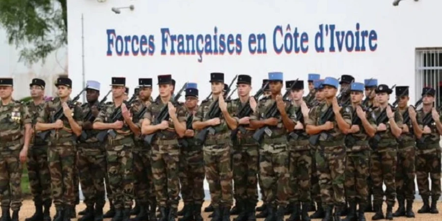 Image de Société. La transition militaire entre la France et la Côte d'Ivoire connaît un tournant majeur avec la prise de commandement du 43e Bataillon d’Infanterie de Marine (BIMA) par l’armée ivoirienne à partir de janvier 2025. Cette décision s’inscrit dans un contexte stratégique plus large de réorganisation de la présence militaire française en Afrique. Le changement de commandement de ce bataillon emblématique, situé à Abidjan-Port Bouët, marque une étape symbolique de la souveraineté accrue de la Côte d’Ivoire et réaffirme la volonté du pays de renforcer ses capacités militaires tout en maintenant une coopération étroite avec la France. Mais que signifie réellement ce passage sous commandement ivoirien, tant sur le plan militaire que politique ? Cette transition pourrait-elle marquer un nouveau chapitre dans les relations de défense entre la France et ses anciennes colonies africaines ? Un tournant stratégique dans la coopération militaire France-Côte d'Ivoire La prise de commandement du 43e BIMA par l’armée ivoirienne représente un événement historique pour la Côte d'Ivoire. Ce bataillon, qui est l'un des principaux dispositifs militaires français sur le sol ivoirien, verra sa gestion confiée aux autorités ivoiriennes à compter de janvier 2025. Le camp, situé à Abidjan-Port Bouët, sera désormais rebaptisé *Camp Ouattara Thomas d’Aquin*, en hommage à l’un des pères fondateurs de l’armée ivoirienne, le premier chef d’État-major des armées ivoiriennes, décédé en 1990. Ce changement de nom symbolise non seulement le transfert de commandement, mais aussi la volonté de la Côte d'Ivoire de renforcer sa souveraineté en matière de défense. Cette transition s'inscrit dans un contexte géopolitique particulier où la France, après des décennies de présence militaire en Afrique, réajuste sa stratégie de coopération militaire. L’objectif affiché est de réduire progressivement le nombre de bases militaires permanentes tout en conservant une capacité de réaction rapide. En ce sens, le maintien d’une présence française limitée à Abidjan, par le biais d’un détachement d’environ 100 soldats, semble être une solution de compromis entre le retrait progressif et la nécessité de préserver une coopération stratégique avec la Côte d'Ivoire. L’un des principaux enjeux de ce transfert est l’accroissement de l’autonomie militaire de la Côte d'Ivoire. En devenant le commandant du 43e BIMA, l’armée ivoirienne prend en main une installation stratégique et devient davantage responsable de la formation, de l’équipement et de la gestion des infrastructures militaires. Ce passage de relais reflète la volonté du pays de se doter d’une armée plus compétente, moderne et indépendante. Le projet de réorganisation du camp implique la mise en place de nouvelles structures : le 1er Bataillon des Commandos et des Parachutistes sera installé sur place, de même qu’une école régionale des Systèmes d’Information et de Communication (SIC), ainsi qu’un centre de formation logistique. Ces nouvelles installations sont conçues pour répondre aux besoins spécifiques de l’armée ivoirienne et permettre une meilleure préparation face aux défis sécuritaires de la région. Le camp devrait également accueillir des bataillons supplémentaires, au moins cinq, pour diversifier les spécialités de l’armée ivoirienne. Pour le ministre de la Défense, Téné Birahima Ouattara, cette transition est perçue comme un pas décisif dans le processus de consolidation de la défense nationale. En juillet 2024, il expliquait que des experts ivoiriens et français collaborent étroitement pour garantir une transformation harmonieuse. Le ministre a exprimé sa confiance en ce processus, soulignant que « tout se passe très bien », et que les besoins spécifiques de la Côte d'Ivoire en matière de sécurité seraient satisfaits grâce à une réorganisation minutieuse des installations. La réorganisation de la présence militaire française en Afrique La prise de commandement par les Ivoiriens du 43e BIMA s'inscrit dans une stratégie plus large de réorganisation de la présence militaire française sur le continent africain. Depuis le début de l'année 2024, la France a annoncé plusieurs initiatives visant à adapter sa posture militaire en Afrique, avec la réduction du nombre de ses bases permanentes et la réorientation de ses efforts vers des partenariats plus étroits avec les armées locales. L’annonce de cette réorganisation a été faite par le président Emmanuel Macron en février 2024, dans le cadre d’une nouvelle politique de défense. Ce réajustement stratégique fait écho à la volonté de la France de réduire l'empreinte militaire de ses troupes en Afrique, tout en maintenant des relations de coopération renforcées avec ses anciennes colonies. La Côte d'Ivoire est l’un des pays privilégiés dans cette transition, en raison de son rôle stratégique dans la région de l’Afrique de l’Ouest et de ses relations historiques avec la France. En pratique, la réorganisation de la coopération militaire se traduit par un rôle renforcé des armées africaines, capables de gérer leurs propres bases et infrastructures militaires, tout en bénéficiant du soutien de partenaires occidentaux comme la France. Cette nouvelle configuration vise à assurer une plus grande résilience des armées africaines face aux menaces sécuritaires croissantes, notamment celles liées au terrorisme et aux conflits régionaux. Le partenariat militaire entre la France et la Côte d'Ivoire repose sur un accord de défense signé en 2012. Cet accord a permis à la France de maintenir une présence militaire importante sur le sol ivoirien, après la crise post-électorale de 2010-2011, et d'apporter son soutien aux autorités ivoiriennes pour stabiliser le pays. Le 43e BIMA, en particulier, a joué un rôle clé dans la formation et la logistique, facilitant ainsi l’armement et l’entraînement des forces ivoiriennes. Cet accord reste valide, mais la transition vers un commandement ivoirien du 43e BIMA marque un nouveau modèle de coopération. À la fois symbole de la maturation de la relation bilatérale, cette évolution permet à la Côte d'Ivoire de prendre les rênes de sa propre défense tout en restant ancrée dans une coopération militaire structurée avec la France. Le soutien français se réduira progressivement, mais il continuera sous forme de formation, de logistique et de soutien en matière d’équipement, avec l’objectif de renforcer l’autonomie de l’armée ivoirienne. Un contexte de changement pour l’Afrique et la France La transition du 43e BIMA survient à un moment crucial de l’histoire de la présence militaire française en Afrique. Après le retrait des troupes françaises du Sahel en 2022, la France se prépare à effectuer un autre retrait majeur, celui du Tchad et du Sénégal. Cette évolution s’accompagne de critiques croissantes contre la présence militaire française sur le continent, notamment en raison des tensions géopolitiques et des relations complexes entre la France et certains pays africains. Dans ce contexte, le retrait partiel de la France en Afrique pourrait signifier une nouvelle étape dans la réinvention des relations franco-africaines. Alors que certains pays africains, comme la Côte d'Ivoire, semblent vouloir maintenir une coopération bilatérale forte avec la France, d’autres, comme le Mali et le Burkina Faso, ont opté pour une rupture. La question qui se pose est de savoir si la France sera en mesure de maintenir une influence positive en Afrique, ou si de nouvelles dynamiques de pouvoir émergeront sur le continent. La transition du 43e BIMA sous commandement ivoirien est donc un signe tangible de l’évolution des relations militaires entre la Côte d’Ivoire et la France. Si cette évolution semble en accord avec les intérêts des deux pays, elle s’inscrit également dans une dynamique régionale et internationale plus complexe. La Côte d'Ivoire, tout en renforçant son indépendance militaire, pourra-t-elle maintenir un équilibre entre coopération internationale et autonomie nationale ? Et comment cette transition influencera-t-elle les relations entre la France et ses autres partenaires africains à l'avenir ? Cette question reste ouverte, alors que la Côte d'Ivoire se prépare à jouer un rôle plus important dans le cadre de la réorganisation de la défense en Afrique.