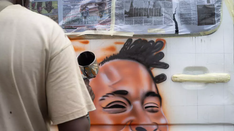 Image de Art. En Côte d’Ivoire, l’art du graffiti ne se limite pas aux murs des quartiers populaires ou aux galeries d’art. Il s’est subtilement intégré à la vie quotidienne des Abidjanais, notamment à travers les véhicules de transport en commun tels que les gbakas et les Wôrô-wôrô. Ces minibus et taxis collectifs, emblématiques de la ville d’Abidjan, deviennent de véritables toiles mobiles, ornées de peintures vibrantes qui racontent des histoires, affichent des messages ou, tout simplement, donnent une identité visuelle à ces moyens de transport. La pratique est devenue si courante et prisée que de nombreux chauffeurs n’hésitent pas à investir une somme considérable pour embellir leurs véhicules. Le phénomène, à la croisée des chemins entre street-art et culture populaire, donne une nouvelle dimension au graffiti et en fait une forme d'expression à la fois artistique et commerciale. Dans les ateliers de Yopougon, une commune d’Abidjan, des artistes se consacrent à cette discipline, redéfinissant le paysage urbain avec des œuvres uniques. Mais comment ce phénomène est-il né ? Quelles sont les motivations des chauffeurs à investir dans ce type d'art ? Et surtout, que représente ce graffiti pour les Abidjanais ? Le Graffiti comme Identité Culturelle Dans les rues animées d’Abidjan, les gbakas et Wôrô-wôrô ne passent jamais inaperçus. Ces minibus et taxis collectifs, qui sillonnent la ville jour et nuit, sont les véritables artères du transport public. Mais au-delà de leur fonction utilitaire, ces véhicules sont également devenus des supports d’expression visuelle. Leurs carrosseries, souvent décorées de portraits de célébrités, de scènes religieuses, de messages d’espoir ou de revendications sociales, attirent l’attention de tous ceux qui croisent leur chemin. Le phénomène, bien qu’ayant pris de l’ampleur ces dernières années, n’est pas une nouveauté. Depuis plusieurs décennies, le graffiti a trouvé sa place dans le paysage abidjanais. Mais c’est véritablement avec l’essor du mouvement hip-hop dans les années 90, puis l'explosion des réseaux sociaux et de la culture visuelle dans les années 2000, que cette forme d'art a pris de l’ampleur sur les véhicules de transport en commun. "C’est une manière de se démarquer", explique un artiste de Yopougon. "Les chauffeurs veulent que leur véhicule soit reconnu, qu’il soit unique. Et le graffiti est le moyen idéal pour ça." Le secteur du transport public à Abidjan est un véritable moteur économique. Les gbakas et Wôrô-wôrô constituent le principal moyen de transport pour une grande partie de la population, et les chauffeurs sont prêts à investir dans l’aspect esthétique de leurs véhicules. "Cela fait partie de l’image", précise Mamadou, chauffeur de gbaka à Abidjan. "Un véhicule décoré attire plus de clients. Les passagers aiment voyager dans des véhicules qui ont du style." Pour ces chauffeurs, le coût de la décoration, qui varie entre 40 000 et 50 000 francs CFA (de 60 à 76 euros), est un investissement qui rapporte. À Yopougon, un des quartiers les plus animés d’Abidjan, les ateliers comme celui de N’Guess Décor connaissent un véritable essor. N’Guess Décor, un atelier reconnu de la commune, est un lieu emblématique où la magie du graffiti opère. Là, des artistes décorent les véhicules avec des techniques proches du graffiti traditionnel, mais adaptées aux exigences des chauffeurs. Les peintures sont réalisées à la main, souvent à la bombe, et parfois avec des pinceaux pour les détails plus fins. Les motifs varient en fonction des souhaits du client. Certains optent pour un portrait de célébrité, tandis que d’autres préfèrent des illustrations plus abstraites ou des scènes religieuses. "Chaque chauffeur a une idée précise de ce qu'il veut. Certains veulent des dessins simples, d’autres préfèrent des scènes plus complexes", explique l'un des artistes de l'atelier. Une Pratique Artisanale au Coeur de la Ville Le processus de création d’une œuvre sur un véhicule est un travail méticuleux. L’artiste commence par préparer la surface, en nettoyant soigneusement la carrosserie pour que la peinture adhère correctement. Puis, il esquisse le design à l’aide de croquis avant de passer à l’application des couleurs. "La peinture doit être résistante, car les véhicules sont constamment exposés aux intempéries. Les couleurs doivent tenir face à la chaleur, la pluie et les frottements", explique N’Guess, le propriétaire de l’atelier. Les artistes qui se consacrent à cette pratique ont souvent un savoir-faire unique, une combinaison de techniques empruntées au graffiti et à la peinture classique. La créativité est essentielle, mais il faut aussi maîtriser les contraintes techniques liées à la décoration d’un véhicule en mouvement. "Chaque œuvre doit être réalisée avec soin. Le défi, c’est de donner une âme au véhicule tout en respectant les contraintes techniques", souligne l'artiste. Si l’aspect esthétique du graffiti sur les véhicules est indéniable, il y a également une forte composante économique. Les chauffeurs de gbakas et Wôrô-wôrô voient dans cet investissement un moyen de se différencier et d'attirer davantage de passagers. "C’est aussi une question de visibilité", précise Mamadou, un autre chauffeur de Wôrô-wôrô. "Plus ton véhicule est beau, plus les gens veulent y monter. C’est une sorte de publicité ambulante." Ce phénomène crée ainsi une dynamique intéressante où le graffiti devient un moteur économique, à la fois pour les artistes qui gagnent leur vie grâce à leur travail, et pour les chauffeurs qui profitent d'une clientèle fidèle. Les artistes qui réalisent ces décorations sont payés pour chaque projet et bénéficient d’une source de revenus stable. En retour, ils contribuent à l’essor d’une culture urbaine et d’un mode d’expression artistique qui, jusqu’à présent, n’avait pas la même visibilité en Côte d'Ivoire. L'une des particularités du graffiti sur les gbakas et Wôrô-wôrô est son côté populaire et accessible. Contrairement aux galeries d'art ou aux expositions réservées à une élite, le graffiti sur ces véhicules est un art de la rue, un art accessible à tous. Les passants, les usagers des transports en commun, les enfants et même les touristes peuvent apprécier ces œuvres en déambulant dans les rues de la capitale économique ivoirienne. Le graffiti devient alors un moyen pour la culture urbaine d’atteindre une large audience, sans passer par les canaux traditionnels du monde de l’art. En ce sens, cet art contribue à la démocratisation de la culture en Côte d’Ivoire. "Le graffiti sur les véhicules, c’est une façon de rendre l’art visible et accessible. Cela permet de toucher des gens qui n’iraient jamais dans une galerie ou un musée", explique l’artiste Abou, un habitué de l’atelier de N’Guess Décor. Les gbakas et Wôrô-wôrô décorés sont également perçus comme des symboles de fierté pour les chauffeurs et leurs passagers. "Chaque véhicule a son histoire", précise N’Guess, "les dessins ont souvent une signification particulière pour celui qui les choisit. C’est un moyen de montrer sa personnalité, ses croyances ou ses passions." Pour les passagers, le voyage prend une autre dimension lorsqu’ils montent dans ces véhicules ornés de peintures vibrantes. "C’est comme si on voyageait dans un tableau", explique Marie, une habitante d’Abidjan. "Ça fait partie de la vie ici. Les gbakas et Wôrô-wôrô sont plus qu’un simple moyen de transport, ce sont des œuvres d’art mobiles." Alors que la culture du graffiti ne cesse de croître dans le monde, il est intéressant de se demander si ce phénomène va se généraliser dans les autres villes de Côte d’Ivoire, voire au-delà des frontières du pays. Les autorités, conscientes de l’impact de cet art dans le paysage urbain, commencent à s'intéresser à cette forme d'expression. Cependant, les autorités devront trouver un équilibre entre la préservation de l’esthétique urbaine et le soutien à cette forme d'art populaire. À l’avenir, le graffiti sur les gbakas et Wôrô-wôrô pourrait-il devenir un secteur structuré avec des règles de régulation, ou restera-t-il un art de la rue, ancré dans une dynamique spontanée et libre ? Le succès de ce mouvement peut-il influencer d’autres formes d’expression artistique dans le pays ?