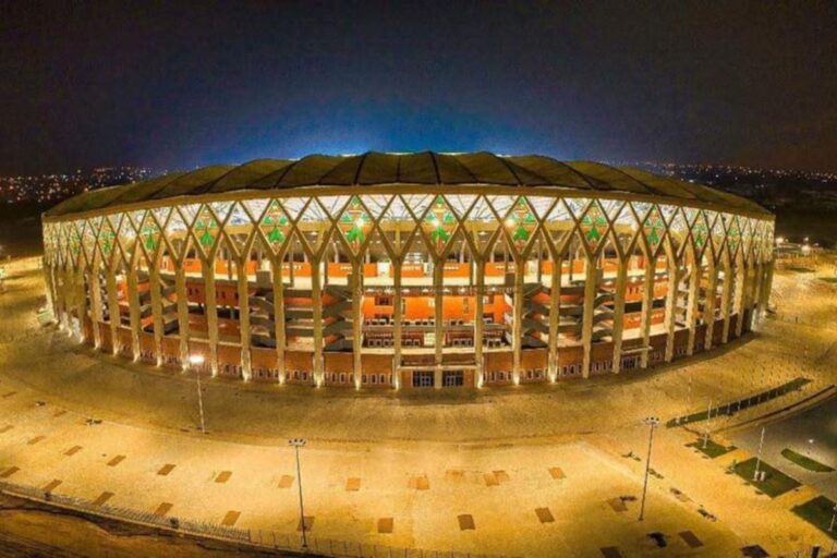 Image de Football. Un an après avoir vibré au rythme des matchs de la Coupe d’Afrique des Nations 2024, les stades ivoiriens continuent de jouer un rôle central dans la vie sportive et culturelle du pays. Les craintes initiales de voir ces infrastructures se transformer en « éléphants blancs » semblent, pour l’instant, dissipées. Ces enceintes, construites ou rénovées pour l’événement, sont devenues des piliers d’activités multiples, allant bien au-delà du football. Des stades au service du sport et des nations africaines Lors de la CAN 2024, la Côte d’Ivoire a mis en lumière six enceintes majeures : quatre flambant neuves situées à Ebimpé, Yamoussoukro, Korhogo et San Pedro, ainsi que deux rénovées à Abidjan et Bouaké. Depuis, ces installations sportives ont maintenu une fréquentation régulière, illustrant leur utilité. Les stades d’Abidjan, de Yamoussoukro et de Korhogo ont été le théâtre de matchs de Ligue 1 ivoirienne, tandis que ceux de Bouaké et de San Pedro ont accueilli des rencontres de Coupes africaines. En outre, les deux enceintes d’Abidjan ont servi de refuge pour des équipes africaines, telles que le Bénin, ne disposant pas d’infrastructures conformes aux normes internationales. « Ces stades permettent à des équipes de briller sur la scène internationale et de rapprocher les nations », a déclaré un analyste sportif local. Les infrastructures ne se limitent pas au football. En avril, la Côte d’Ivoire accueillera la CAN des moins de 20 ans, un autre événement qui mobilisera ces enceintes et consolidera leur rôle dans le développement du sport africain. Des lieux de culture et de rassemblement Au-delà des activités sportives, les stades ivoiriens deviennent des espaces de culture et de divertissement. Le rappeur emblématique Didi B, avec son « Mojo Hope Tour Stadium », est l’un des artistes à utiliser ces lieux pour des concerts de grande envergure. Ces événements prévus à Bouaké, Korogho et Abidjan attirent des foules considérables et mettent en évidence le potentiel des stades comme catalyseurs d’activités économiques et culturelles. À l’instar des modèles européens où les enceintes sportives deviennent des « espaces de vie », les stades ivoiriens explorent leur potentiel polyvalent. Cependant, cette transition n’est pas sans défis. Yassine Idriss Diallo, président de la Fédération ivoirienne de football, rappelle que « les infrastructures sportives en Afrique ne sont pas rentables. Elles deviennent viables lorsqu’elles sont exploitées par des clubs ou à travers des partenariats public-privé ». La diversification des usages pourrait être une solution pour maximiser leur impact. Un avenir prometteur mais exigeant Malgré les succès initiaux, maintenir la pertinence et la fonctionnalité des stades reste un enjeu crucial. Les coûts d’entretien élevés et la gestion durable de ces infrastructures exigent des stratégies adaptées. L’implication de l’État et des acteurs privés sera essentielle pour garantir leur survie à long terme. Les retombées économiques, bien que modérées, sont déjà perceptibles dans les villes concernées, notamment grâce à l’afflux de touristes et d’amateurs de spectacles. Toutefois, il est nécessaire d’investir dans des campagnes de sensibilisation et dans des initiatives communautaires pour renforcer l’appropriation locale de ces espaces. L’avenir des stades ivoiriens dépendra de leur capacité à s’adapter aux attentes changeantes et à diversifier leurs usages. Seront-ils capables de devenir des modèles en Afrique de l’Ouest en matière de gestion d’infrastructures sportives et culturelles ?