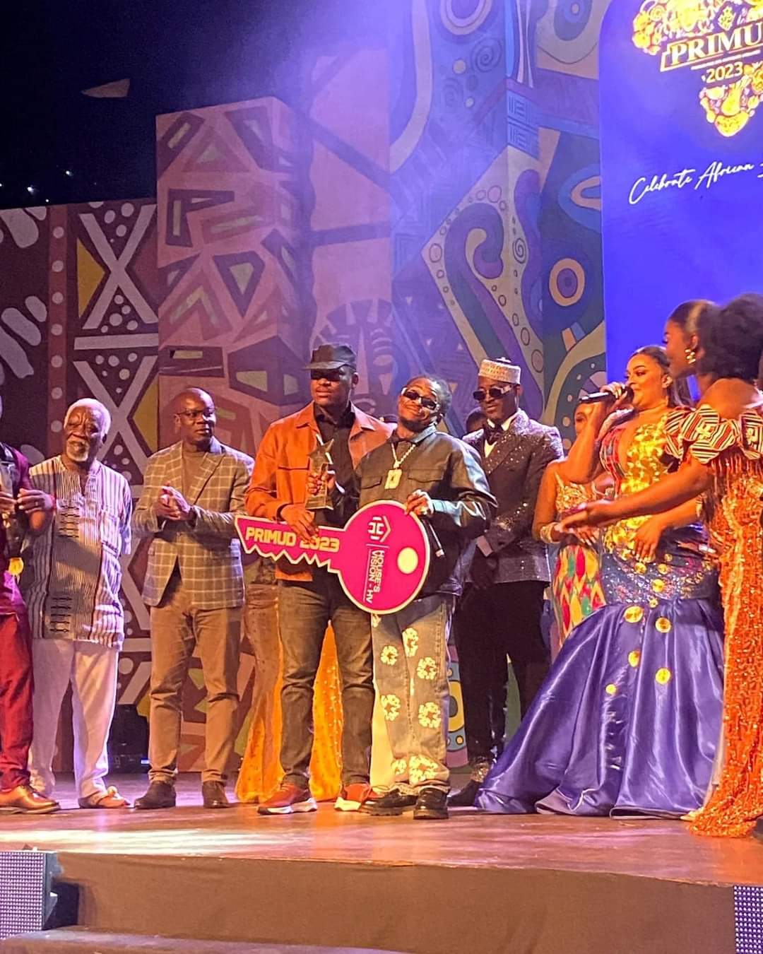 Image de Célébrités. Didi B, rappeur ivoirien, a remporté le prestigieux trophée du PRIMUD d’Or 2023 lors de la cérémonie qui s'est déroulée le dimanche 19 novembre au Palais des congrès du Sofitel Hôtel Ivoire de Cocody. Ce succès n'a pas surpris les observateurs, car Didi B excelle dans son art depuis plusieurs années grâce à son talent et à son dévouement. Après avoir été finaliste l'année précédente, il remporte cette fois-ci le trophée, une consécration majeure pour lui. Il compte célébrer ce prix lors de son concert prévu pour le 25 novembre au Parc des expositions d’Abidjan à Port-Bouët. Lors de la remise du trophée, Didi B a exprimé sa gratitude en dédiant cette récompense à ses collègues du groupe de rap Kiff No Beat et à la jeunesse ivoirienne, soulignant que cette victoire appartient à toute son équipe et à ceux qui les ont soutenus depuis le début. Son manager, Diba Diallo, et son arrangeur, Tamsir, ont également été honorés lors de la cérémonie du PRIMUD, où ils ont exprimé leur reconnaissance envers l'organisateur, Le Molare, pour le succès de cette 8ème édition de l'évènement. Qui selon vous a des chances de remporter la prochaine édition ?