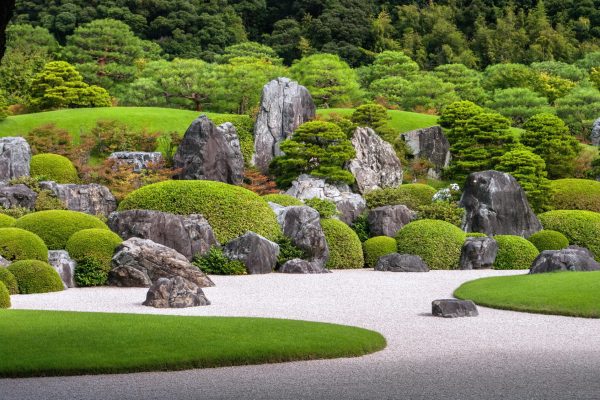 Deuxième Image de Société. Pendant deux décennies consécutives, le jardin du musée Adachi à Yasugi, au Japon, a été couronné comme le plus beau jardin japonais par le magazine spécialisé américain Sukiya Living. Cette distinction salue non seulement la beauté exceptionnelle du jardin mais souligne également son rôle unique en tant que musée d'art japonais, offrant une expérience artistique et naturelle inégalée. Une Oasis de Sérénité dans le Monde des Jardins Japonais Les jardins japonais, célèbres pour leur atmosphère zen et apaisante, ont conquis le monde par leur esthétique raffinée. Cependant, tous ne se distinguent pas de la même manière. Parmi plus de 1 000 candidats, le jardin du musée Adachi, étalé sur 16,5 hectares, continue de se démarquer, offrant une expérience visuelle et sensorielle unique. Évolution Saisonnière : Un Ballet de Couleurs et de Formes Le jardin Adachi ne se limite pas à une seule esthétique. Il offre une variété de styles, du jardin sec « karesansui » mettant en valeur le sable et les roches à un jardin de mousse en passant par un jardin de pins et de gravier blanc. Cette diversité crée un paysage vivant, évoluant au gré des saisons. Pour les visiteurs, c'est une opportunité de contempler des "œuvres vivantes" qui se transforment au fil du temps, selon l'office de tourisme de Shimane. Récompenses et Reconnaissance Internationale La consécration annuelle par le magazine Sukiya Living n'est qu'une des nombreuses distinctions accordées au jardin du musée Adachi. Avec trois étoiles au Guide Vert Michelin et au Guide Bleu Japon, le jardin a su marquer son empreinte à l'échelle mondiale. Ces récompenses soulignent l'harmonie exceptionnelle entre l'art, la nature et la préservation de l'esthétique japonaise. Un Musée Enrichissant l'Expérience Visuelle Le musée, créé en 1970 par un homme d'affaires japonais visionnaire, abrite des expositions de peintures japonaises qui changent au rythme des saisons, suivant la dynamique naturelle du jardin. Cette fusion entre art et nature crée une expérience immersive où les visiteurs peuvent non seulement apprécier les peintures mais aussi contempler les jardins qui les entourent. Un Voyage Vers la Beauté - Au Bout du Monde Bien que l'accès au jardin du musée Adachi puisse exiger un effort, nécessitant trois heures de train depuis Osaka, l'expérience en vaut la peine. L'absence du Shinkansen dans la région ajoute une couche d'isolement, préservant ainsi le caractère préservé et intime du jardin. Les visiteurs sont récompensés par des paysages à couper le souffle, avec les montagnes en toile de fond, créant une symbiose harmonieuse entre l'homme, l'art et la nature. Une Beauté Immuable à Travers les Âges Le jardin du musée Adachi, avec ses 20 années consécutives au sommet du monde des jardins japonais, transcende le temps. En tant qu'œuvre vivante en perpétuelle évolution, il continue d'inspirer la réflexion sur la beauté, l'art et la connexion intime avec la nature. Quelles leçons peut-on tirer de ce jardin exceptionnel pour cultiver notre appréciation de la beauté éphémère de la vie et de la nature qui nous entoure ?