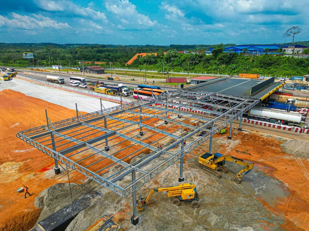 Image de Société. Les péages routiers jouent un rôle crucial dans la gestion des routes et des infrastructures, offrant un moyen de financement pour l'entretien, l'amélioration et la construction de nouvelles voies de circulation. En Côte d'Ivoire, le péage à Attinguié représente l'une des infrastructures de péage majeures du pays. Les travaux actuels visent à doubler le nombre de postes de péage, passant de 8 à 16 postes. Cette expansion vise principalement à améliorer l'efficacité du trafic routier et à fournir un meilleur service aux usagers de cette route très fréquentée. L'augmentation du nombre de postes de péage à Attinguié s'inscrit dans une tendance plus large de développement des infrastructures de péage à travers le pays. En effet, la construction de nouveaux postes de péage est en cours sur de nombreuses routes, portant ainsi le nombre total de péages à plus de 12, ce qui souligne l'importance croissante de ces installations dans le paysage routier ivoirien. L'objectif de ces extensions est multiple. Tout d'abord, il y a l'amélioration attendue de la fluidité du trafic. En augmentant le nombre de postes de péage, les autorités cherchent à réduire les embouteillages fréquents aux péages, ce qui peut contribuer à un flux de circulation plus régulier et plus rapide. Cela peut également contribuer à réduire les temps de trajet, offrant ainsi des avantages économiques aux usagers et aux entreprises. De plus, l'expansion des péages vise à optimiser la collecte des recettes pour le financement des infrastructures routières. Les fonds générés par les péages sont réinvestis dans la maintenance des routes existantes, la construction de nouvelles voies et d'autres projets d'infrastructure. Ceci est crucial pour garantir des routes sûres et de qualité, favorisant le développement économique à long terme du pays. Cependant, malgré ces avantages, l'introduction ou l'extension des péages suscitent parfois des inquiétudes parmi les usagers. Certains peuvent percevoir ces frais supplémentaires comme une charge financière supplémentaire, surtout s'ils utilisent fréquemment ces routes. De plus, il peut y avoir des préoccupations concernant la transparence dans l'utilisation des fonds collectés par les péages, soulevant des questions sur la reddition de comptes et la gestion des ressources financières. En outre, l'efficacité des postes de péage dépend également de la manière dont ils sont gérés. Une infrastructure de péage bien entretenue avec un personnel formé et des systèmes efficaces peut contribuer à une expérience utilisateur positive. Cela soulève des questions sur la formation du personnel, l'utilisation de technologies modernes pour faciliter les paiements et réduire les temps d'attente, ainsi que la garantie de la sécurité des usagers aux postes de péage. Dans le contexte plus large des projets futurs de péages en Côte d'Ivoire, il est essentiel de se pencher sur l'impact environnemental potentiel de ces extensions. L'augmentation du trafic routier peut avoir des conséquences sur l'environnement, notamment en termes de pollution atmosphérique et de dégradation des infrastructures naturelles. Il est donc crucial de mettre en place des mesures visant à atténuer ces effets négatifs. En conclusion, les travaux d'extension du péage à Attinguié et les projets de construction de nouveaux péages à travers la Côte d'Ivoire reflètent une volonté de modernisation des infrastructures routières et de financement durable pour le développement des routes. Cependant, pour garantir le succès et l'acceptation de ces initiatives, il est essentiel de prendre en compte les préoccupations des usagers, de maintenir la transparence dans l'utilisation des fonds collectés, de mettre en place des systèmes efficaces et de minimiser l'impact environnemental. Comment envisagez-vous l'optimisation des infrastructures de péage pour répondre aux besoins des usagers tout en tenant compte des préoccupations environnementales et économiques ?