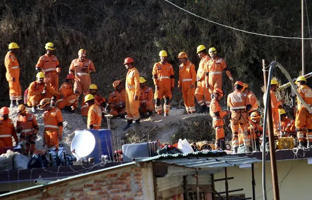 Image de Société. Le drame qui s'est déroulé dans le tunnel de Silkyara, en Inde, a retenu l'attention du monde entier alors que les sauveteurs s'efforcent de libérer les 41 ouvriers piégés dans les décombres. L'histoire, qui a débuté avec l'effondrement du tunnel en construction, s'est transformée en une épreuve complexe de sauvetage, confrontant les équipes de secours à divers défis. Le tunnel de Silkyara, partie intégrante du projet autoroutier Char Dham dans l'État de l'Uttarakhand, est devenu le théâtre d'une opération de secours méticuleuse qui a suscité l'attention du public en raison de ses développements imprévisibles. Le chemin vers les 41 ouvriers piégés s'est révélé être une série d'obstacles complexes, défiant les efforts des équipes de sauvetage. L'incident, survenu il y a deux semaines, a plongé les familles des ouvriers et le monde entier dans l'angoisse, les efforts de sauvetage étant continuellement entravés par des difficultés techniques et les conditions géographiques difficiles de la région himalayenne. Des chutes de débris et des pannes d'équipement ont ralenti les opérations, prolongeant l'agonie des ouvriers piégés. La situation a atteint une impasse critique lorsque la machine de forage a heurté un enchevêtrement de tiges métalliques et de véhicules de construction, à seulement neuf mètres des ouvriers. Les responsables des secours ont dû élaborer des stratégies alternatives, notamment le forage vertical d'un puits dans le tunnel à l'aide d'une excavatrice et la création d'une troisième voie, mais beaucoup plus longue. Arnold Dix, président de l'Association internationale des tunnels et espaces souterrains, impliqué dans les opérations de sauvetage, a souligné les défis rencontrés, déclarant que la machine utilisée précédemment était irréparable. Malgré ces obstacles, il reste optimiste quant aux différentes approches envisagées pour atteindre les ouvriers piégés. L'Himalaya, avec son terrain difficile, a ajouté une dimension supplémentaire de complexité à l'opération de sauvetage. Les équipes ont dû jongler avec les conditions météorologiques instables, les terrains accidentés et les risques d'effondrement supplémentaires. Le projet autoroutier Char Dham, qui visait à améliorer les liaisons avec des sites hindous importants et les régions frontalières de la Chine, a été le théâtre d'une épreuve inattendue et difficile. L'attente angoissante des familles, les complications techniques et les écueils imprévus auxquels sont confrontés les sauveteurs soulèvent des questions plus larges sur la planification des projets d'infrastructure dans des zones géographiques délicates. Comment peut-on mieux anticiper et répondre à de telles situations d'urgence ? Quels enseignements peut-on tirer de cette crise pour améliorer la sécurité dans des projets similaires à l'avenir ?