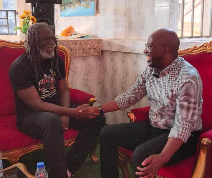 Image de Politique. La rencontre entre Tiken Jah Fakoly, icône de la musique reggae engagée, et Charles Blé Goudé, figure politique ivoirienne controversée, à l'Ambassade RASTAFARI à Yopougon Maroc a captivé l'attention nationale et internationale. Ce moment symbolique, chargé d'espoir et de signification, a marqué un pas significatif vers la paix et la réconciliation en Côte d'Ivoire. Contexte et Signification de la Rencontre Tiken Jah Fakoly, célèbre pour sa musique engagée et ses prises de position en faveur de la justice sociale et de la paix, a ouvert les portes de l'Ambassade RASTAFARI pour accueillir Charles Blé Goudé. Cette rencontre inattendue entre un musicien mondialement reconnu et une personnalité politique controversée a suscité des réactions passionnées dans le pays et au-delà. Le Message de Paix et de Réconciliation Au cœur de leur échange, la paix, le pardon et la réconciliation ont été les thèmes centraux. Les deux hommes ont manifesté leur volonté de dépasser les clivages politiques et de travailler ensemble pour un avenir harmonieux en Côte d'Ivoire. Leur réunion a été empreinte de symboles, incarnant l'espoir d'une nation réunie malgré les divisions passées. Engagement pour l'Avenir de la Côte d'Ivoire Tiken Jah Fakoly et Charles Blé Goudé ont exprimé leur engagement à jouer un rôle.