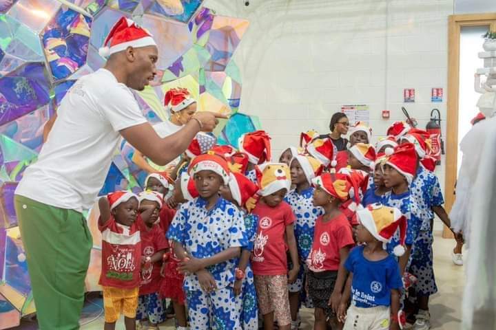 Image de Célébrités. La Fondation Didier Drogba, sous la direction de son Président éponyme, M. Didier Drogba, a une fois de plus créé un moment d'une valeur inestimable pour les enfants de l'orphelinat « OFAA ». En ce jour mémorable du lundi 18 décembre 2023, l'orphelinat a été transformé en un lieu de joie et de réjouissance, où les rires, les jeux et les activités festives ont fusionné pour offrir un Noël extraordinaire à ces jeunes âmes. C'est dans cette atmosphère empreinte de chaleur et de générosité que le Père Noël, incarnant l'esprit magique des fêtes, a distribué des cadeaux, semant ainsi des sourires éclatants sur les visages des enfants. Chaque présent offert a été bien plus qu'un simple objet matériel ; il représentait l'affection, l'espoir et la promesse d'un avenir meilleur pour ces enfants. L'événement a été rendu possible grâce à la collaboration et au soutien essentiel de partenaires dévoués. DreamLand Côte d'Ivoire a joué un rôle crucial en mettant à disposition un espace propice, offrant un cadre idéal pour que les enfants puissent vivre pleinement cette journée magique. Leur contribution généreuse a permis de créer un environnement où les rêves prennent vie et où l'insouciance enfantine règne en maître. De plus, Barons Conseil Communication a été l'architecte de cet événement, orchestrant avec brio chaque détail pour garantir le succès de cette journée spéciale. Leur dévouement et leur expertise ont été des éléments clés pour créer une atmosphère chaleureuse et accueillante, propice à l'épanouissement des enfants. Ce moment d'émerveillement et de partage authentique a été bien plus qu'une simple célébration de Noël. Il a incarné l'esprit de solidarité, d'empathie et de générosité qui caractérise la Fondation Didier Drogba. En unissant leurs forces, la Fondation, DreamLand Côte d'Ivoire et Barons Conseil Communication ont offert bien plus qu'une journée de festivités ; ils ont offert aux enfants une bouffée d'espoir, un sentiment de valeur et une expérience inoubliable. Au-delà des sourires illuminant les visages des enfants, cet événement a également souligné l'importance cruciale de soutenir les enfants vulnérables et les orphelinats. Il a sensibilisé le public à la nécessité de créer des espaces sûrs et inclusifs pour ces jeunes, où ils peuvent non seulement recevoir des cadeaux matériels, mais aussi être entourés d'amour, de soins et de soutien. La Fondation Didier Drogba, par le biais de cet événement, a renforcé son engagement envers la protection et le bien-être des enfants défavorisés. Elle a démontré que même les actions les plus simples, comme offrir un cadeau ou passer du temps avec ces enfants, peuvent avoir un impact profond et durable dans leurs vies. En conclusion, la journée du 18 décembre 2023 restera gravée dans les mémoires comme un moment magique où la générosité, la compassion et la joie ont convergé pour créer des souvenirs inoubliables pour les enfants de l'orphelinat « OFAA ». Cette journée illustre parfaitement l'essence même de la saison des fêtes : partager, donner et répandre la chaleur humaine.