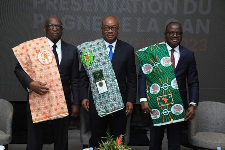 Image de Football. Le discours prononcé par Idriss Diallo, le vice-président du COCAN, lors de la présentation du pagne officiel de la Coupe d'Afrique des Nations (CAN), met en lumière l'importance symbolique profonde que revêt le pagne au sein de la société ivoirienne. Le pagne, tissu traditionnellement utilisé dans de nombreuses cultures africaines, déploie une signification particulière et agit comme un symbole de l'identité culturelle, de l'unité nationale et de la fierté communautaire en Côte d'Ivoire. Cette déclaration engageante exhorte chacun à se rendre chez les vendeurs de pagne et à acquérir cet élément emblématique. Cela va bien au-delà de l'aspect matériel de l'achat ; c'est un appel à l'appropriation culturelle, à la célébration et à la promotion des valeurs représentées par ce tissu traditionnel. Le pagne transcende ainsi sa simple existence en tant que vêtement pour devenir un vecteur de lien social, de transmission de traditions et de renforcement de l'identité collective. Enraciné dans l'histoire et la culture ivoiriennes, le pagne incarne des siècles de savoir-faire artisanal et de diversité artistique. Chaque motif, chaque couleur, chaque dessin sur un pagne raconte une histoire, reflète une signification et représente souvent des éléments de la vie quotidienne, des croyances ou des événements historiques. Il devient ainsi un langage visuel, une forme d'expression artistique et culturelle profonde. L'encouragement à l'adoption généralisée du pagne par toute la population ivoirienne transcende les limites d'un simple objet vestimentaire. C'est un acte de ralliement, une démonstration collective de soutien envers un symbole national. Cela renforce le sentiment d'appartenance à une nation fière de son héritage culturel, tout en célébrant la diversité et la richesse de cette culture. L'initiative de populariser le pagne officiel de la CAN ne se limite pas à un événement sportif ; elle revêt une portée sociale et culturelle bien plus profonde. En encourageant chacun à acquérir ce pagne, Idriss Diallo et le COCAN ouvrent la voie à une conversation plus large sur l'importance de la préservation et de la promotion des traditions culturelles au sein de la société moderne. Ce geste suscite également des réflexions sur l'économie locale et l'industrie artisanale. La demande accrue de pagnes pourrait stimuler la production artisanale, offrir des opportunités économiques aux artisans locaux et promouvoir un commerce équitable basé sur des produits culturels authentiques. Cette valorisation économique du pagne pourrait avoir un impact positif sur les communautés impliquées dans sa fabrication. En outre, cette incitation à l'achat du pagne officiel de la CAN pourrait servir de catalyseur pour des événements similaires dans d'autres domaines culturels. Cela pourrait encourager la valorisation d'autres éléments culturels, favorisant ainsi une reconnaissance plus large de l'artisanat, de la musique, de l'art visuel et d'autres expressions culturelles propres à la Côte d'Ivoire. En somme, la proposition d'Idriss Diallo de populariser le pagne officiel de la CAN transcende le simple cadre de la mode ou du sport. Elle souligne l'importance du pagne en tant que symbole culturel et identitaire profondément enraciné dans la société ivoirienne. C'est un appel à la célébration de l'héritage culturel, à la solidarité nationale et à la valorisation économique des traditions artisanales.