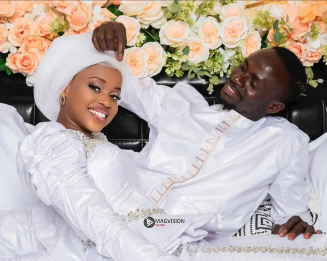 Deuxième Image de Célébrités. Le mariage de Sadio Mané et Aïcha Tamba, célébré en grande discrétion le dimanche 7 janvier 2024, est une véritable ode à l'amour et à la tradition. L'union de ces deux âmes sœurs, originaire de la même région du Sénégal, la Casamance, est un événement qui fascine et émeut, tant pour leur parcours personnel que pour ce qu’ils représentent ensemble. La Rencontre et le Parcours de Sadio Mané Sadio Mané, célèbre footballeur international sénégalais, a conquis le monde du football par son talent, sa vitesse et son humilité. Originaire d'un petit village en Casamance, il a gravi les échelons pour devenir l'un des joueurs les plus respectés et admirés de sa génération. Son parcours est marqué par une ascension fulgurante, des ruelles poussiéreuses de son village natal aux stades les plus prestigieux du monde. Aïcha Tamba, Une Jeune Femme de Valeur Aïcha, quant à elle, est la fille d'un architecte renommé de la région. Elle a grandi dans un environnement où l'art, la culture et l'éducation ont une place prépondérante. Brillante et dotée d'un esprit vif, Aïcha a suivi des études supérieures, représentant un modèle pour les jeunes filles de sa région. Une Union Symbolique Leur mariage ne fut pas seulement la célébration de leur amour, mais aussi un symbole fort pour la jeunesse de Casamance et du Sénégal. Il représente l'espoir, la réussite à travers le travail acharné et l'importance de rester connecté à ses racines. La Cérémonie La cérémonie s'est tenue dans l'intimité, respectant les traditions sénégalaises. Les photos publiées le lendemain révèlent un couple rayonnant de bonheur. Sadio, dans son élégance naturelle, et Aïcha, rayonnante, incarnent une modernité ancrée dans le respect des traditions. Réactions et Répercussions L'annonce de leur mariage a provoqué un véritable raz-de-marée sur les réseaux sociaux. Fans de football, personnalités publiques, et anonymes ont partagé leur joie et leurs félicitations au couple. Ce mariage souligne également l'importance des modèles positifs pour la jeunesse africaine. Sadio et Aïcha, chacun dans leur domaine, démontrent que le succès et l'intégrité sont possibles. L'Engagement Social de Sadio Mané Sadio Mané est connu pour son engagement social. Il a investi dans de nombreux projets pour améliorer les conditions de vie dans son village natal et au-delà. Son mariage avec Aïcha semble renforcer cet engagement, laissant présager de futures initiatives philanthropiques du couple. L'Impact sur le Football et la Culture L'impact de ce mariage va au-delà du simple fait divers. Il souligne le rôle des sportifs comme ambassadeurs culturels. Sadio Mané, à travers son mariage, promeut la culture sénégalaise et africaine sur la scène internationale. L'Avenir du Couple Le couple Mané représente un nouveau chapitre, à la fois pour eux et pour la jeunesse qu’ils inspirent. Leur parcours est un témoignage de la possibilité de conjuguer réussite personnelle, professionnelle et engagement social. Réflexion sur le Mariage et les Valeurs Le mariage de Sadio Mané et Aïcha Tamba soulève des questions importantes sur la célébrité, la tradition, et l’impact social des personnalités publiques. Leur union, tout en restant fidèle aux racines et aux valeurs culturelles, apporte un souffle nouveau et moderne. En définitive, le mariage de Sadio Mané et Aïcha Tamba est bien plus qu'un événement people. C'est une source d'inspiration, un pont entre tradition et modernité, et un exemple de l'impact positif que peuvent avoir les personnalités publiques. À travers leur parcours, leur union et leurs engagements, ils illustrent la richesse et la diversité de la culture africaine. En regardant vers l'avenir, on peut se demander comment ce couple influencera la prochaine génération, non seulement au Sénégal mais à travers toute l'Afrique. Quel impact pensez-vous que Sadio Mané et Aïcha Tamba auront sur les jeunes générations, tant sur le plan culturel que sur le plan de l'engagement social ?