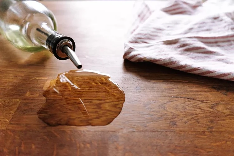 Image de Cuisine. Que ce soit sur un plan de travail, un meuble ou un parquet, ces tâches peuvent être un véritable casse-tête. Avec le temps, le gras s'infiltre dans le bois, rendant son élimination d'autant plus difficile. Dans cet échange, je vais partager mon expérience et mes méthodes éprouvées pour enlever ces vieilles tâches de gras, en préservant l'intégrité et l'esthétique du bois. Comprendre la Nature du Bois et du Gras Avant de plonger dans les techniques de nettoyage, il est crucial de comprendre la nature du bois et comment il réagit avec le gras. Le bois est un matériau poreux, ce qui signifie que les liquides et les huiles peuvent facilement s'infiltrer dans ses fibres. Une fois que le gras s'est installé, il peut s'oxyder et s'ancrer profondément dans le bois, créant des tâches tenaces. Mon approche vise à traiter ces tâches sans endommager le bois, en utilisant des produits doux mais efficaces. La Préparation : Évaluation et Nettoyage Initial Ma première étape consiste toujours à évaluer l'étendue de la tâche et le type de bois concerné. Cela détermine la méthode et les produits à utiliser. Je commence par un nettoyage initial avec un chiffon doux et un nettoyant pour bois doux, pour enlever la saleté de surface et avoir une meilleure visibilité de la tâche. L'Utilisation de Produits Naturels Dans ma quête pour une solution efficace et respectueuse du bois, j'ai découvert que certains produits naturels sont particulièrement efficaces contre les tâches de gras. Le bicarbonate de soude, par exemple, est un excellent choix. Je crée une pâte en mélangeant le bicarbonate de soude avec un peu d'eau et je l'applique sur la tâche. Après avoir laissé agir pendant quelques heures, je frotte doucement avec un chiffon humide. Cette méthode a souvent été efficace pour moi, surtout pour les tâches récentes. L'Option du Détachant Commerciaux Pour les tâches plus anciennes ou plus tenaces, je me tourne parfois vers des détachants commerciaux spécialement conçus pour le bois. Il est important de suivre scrupuleusement les instructions du fabricant et de tester le produit sur une zone discrète avant de l'appliquer sur la tâche. Ces produits sont généralement plus puissants que les solutions naturelles, mais ils doivent être utilisés avec précaution pour éviter d'endommager le bois. Le Ponçage : Une Solution pour les Tâches Profondes Lorsque les tâches ont pénétré profondément dans le bois, le ponçage peut être la seule solution. J'utilise un papier de verre à grain fin pour poncer la zone affectée, en veillant à suivre le grain du bois pour éviter de le rayer. Le ponçage peut enlever une fine couche de bois, révélant une surface propre en dessous. Après le ponçage, il est souvent nécessaire de traiter ou de vernir la zone pour qu'elle corresponde au reste de la surface.