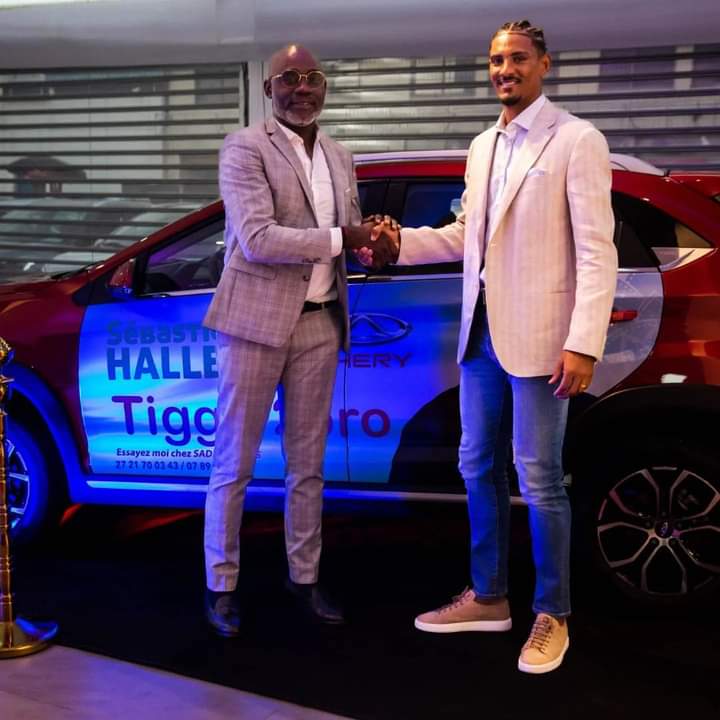 Deuxième Image de Célébrités. Sébastien Haller, l'international footballeur de renom, a récemment pris une décision significative en devenant l'ambassadeur officiel de la prestigieuse marque de véhicules, CHERY. Cette collaboration d'envergure a été officiellement scellée lors d'une cérémonie mémorable qui s'est déroulée le mardi 21 novembre 2023, au siège du réputé concessionnaire automobile SADA MOTORS CI, situé à Abidjan, Zone 3, rue des brasseurs. La cérémonie de signature de ce partenariat stratégique revêt une importance particulière dans le contexte de la vision ambitieuse de SADA MOTORS CI, qui aspire à devenir un acteur majeur de l'industrie automobile en Côte d'Ivoire. Le Directeur Général de SADA MOTORS CI, Jean Takrou, a exprimé ces ambitions en déclarant: « Nos aspirations sont considérables, et aujourd'hui, nous traçons notre trajectoire. Notre alliance avec Sébastien Haller s'étend sur trois années fructueuses. CHERY partage nos grandes ambitions, nous aspirons à être le numéro 1 de la marque en Côte d'Ivoire, et cette ambition se concrétisera avec votre soutien. » Sébastien Haller, de son côté, s'est montré enchanté de s'associer à la marque de voitures CHERY, vantant son design raffiné et son élégance distinctive. « C'est une opportunité exceptionnelle de contribuer positivement au développement de la Côte d'Ivoire. Aujourd'hui, CHERY m'accompagne, et je m'engage à accompagner CHERY vers l'avenir », a déclaré l'attaquant talentueux, membre éminent de l'équipe nationale des Éléphants de Côte d'Ivoire. Il a également souligné l'importance de cette collaboration au seuil de sa participation imminente à la grande célébration du football africain, qui débutera le samedi 13 janvier 2023 sur le sol ivoirien. La décision de Sébastien Haller de devenir l'ambassadeur de CHERY reflète non seulement sa confiance envers la marque, mais également son engagement envers la promotion du secteur automobile en Côte d'Ivoire. La collaboration entre le footballeur talentueux et la marque renommée souligne l'importance croissante des partenariats entre personnalités sportives influentes et entreprises proéminentes. Les implications de ce partenariat s'étendent au-delà des frontières du monde sportif, jouant un rôle crucial dans la stratégie globale de SADA MOTORS CI visant à consolider sa position en tant qu'acteur clé de l'industrie automobile. Jean Takrou a souligné la valeur ajoutée que Sébastien Haller apporte à la marque CHERY en tant qu'ambassadeur, renforçant ainsi la notoriété de l'entreprise et créant des opportunités de croissance significatives. La collaboration tripartite entre Sébastien Haller, CHERY et SADA MOTORS CI devrait ouvrir de nouvelles perspectives passionnantes dans le paysage automobile ivoirien. Les trois années à venir promettent d'être marquées par des initiatives innovantes, des campagnes publicitaires percutantes et des événements promotionnels captivants, renforçant ainsi la présence de CHERY sur le marché ivoirien. En conclusion, la décision de Sébastien Haller d'associer son image à la marque CHERY et la vision stratégique de SADA MOTORS CI témoignent d'une alliance fructueuse qui transcende les domaines du sport et de l'automobile. Cette collaboration ambitieuse s'annonce comme un chapitre captivant dans l'histoire de l'industrie automobile ivoirienne, où le talent sportif et l'innovation automobile convergent pour créer une synergie dynamique et prometteuse.