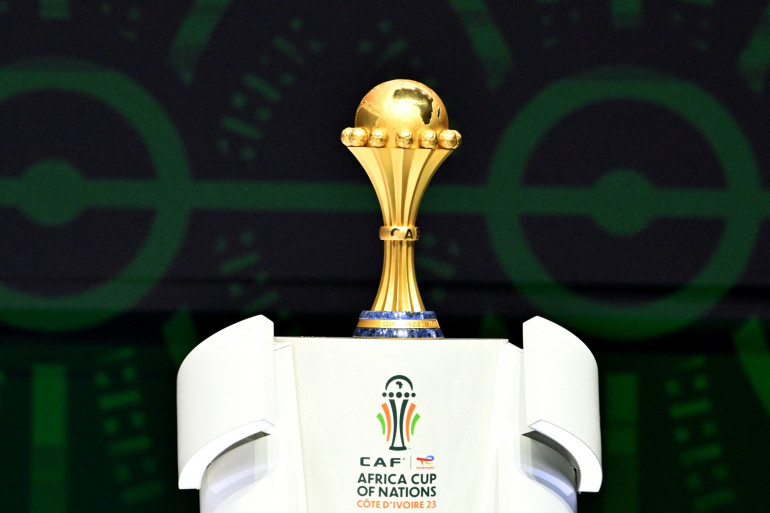 Image de Football. La Coupe d'Afrique des Nations (CAN) 2023, se déroulant en Côte d'Ivoire, est placée sous le signe de la confiance et de l'optimisme. Le président de la Confédération Africaine de Football (CAF), Patrice Motsepe, a exprimé sa conviction que cet événement majeur ne subira pas les mêmes tragédies que celles survenues lors de l'édition précédente au Cameroun. Lors d'une conférence de presse tenue le 12 janvier 2024, il a assuré que des mesures adéquates avaient été mises en place pour éviter une répétition des événements douloureux vécus à Olembé, où une bousculade au Stade d’Olembé avait causé la mort de huit personnes et fait de nombreux blessés. Cet incident tragique, survenu avant le match des huitièmes de finale entre le Cameroun et les Comores, a servi de leçon dure mais cruciale pour l'organisation future de tels événements. Motsepe a reconnu que l'accident aurait pu être évité et a souligné sa responsabilité personnelle en tant que président de la CAF pour garantir la sécurité de tous les événements sous son égide. En préparation de la CAN 2023, le gouvernement ivoirien a réalisé un investissement conséquent, s'élevant à environ 1,5 milliard de dollars, pour améliorer les infrastructures. L'un des joyaux de cet investissement est le stade olympique Ebimpé, situé en périphérie nord d’Abidjan, avec une capacité de 60 000 places. Ce stade accueillera le match d'ouverture ainsi que la finale du 11 février. De plus, pour renforcer la sécurité pendant le tournoi, quelque 17 000 policiers et soldats seront déployés. Cette édition de la CAN ne se limite pas seulement à un événement sportif. Elle représente une opportunité majeure pour la Côte d'Ivoire et pour l'Afrique dans son ensemble. L'importance du football en tant que facteur d'unité et de fierté nationale et continentale est indéniable. Les pays participants voient dans la CAN une plateforme pour montrer leurs talents, promouvoir leur culture, et affirmer leur place sur la scène sportive internationale. Parmi les équipes participantes, le Cameroun se distingue comme l'un des favoris. L'ancien Lion Indomptable et consultant pour beIN Sports, Benjamin Moukandjo, souligne la stature du Cameroun dans le football africain. Avec cinq titres de la CAN à leur actif et une troisième place lors de l'édition précédente, le Cameroun a des attentes élevées. Moukandjo met en avant la capacité de l'équipe à exceller dans les moments décisifs, même si leurs performances en qualifications peuvent sembler moyennes. L'événement de cette année revêt une importance particulière en raison des défis que la CAF et les nations participantes ont dû surmonter. Outre les préoccupations de sécurité, la pandémie de COVID-19 a également eu un impact significatif sur le sport mondial, y compris le football africain. Les restrictions de voyage, les protocoles sanitaires et les incertitudes économiques ont posé des défis supplémentaires pour les organisateurs et les équipes. En dépit de ces défis, la CAN 2023 en Côte d'Ivoire est une célébration du football africain et un témoignage de la résilience et de l'adaptabilité du continent. C'est une occasion pour l'Afrique de briller, d'unir ses peuples et de démontrer sa passion pour le football. La compétition est également une vitrine pour les jeunes talents africains, qui aspirent à se faire remarquer sur la scène internationale. Les retombées économiques de la CAN sont également importantes. L'investissement dans les infrastructures, l'augmentation du tourisme et la visibilité internationale peuvent avoir des effets positifs durables sur le pays hôte et les pays participants. Cela peut contribuer à améliorer l'image de l'Afrique dans le monde et à renforcer la confiance en ses capacités organisationnelles. En conclusion, alors que la CAN 2023 en Côte d'Ivoire promet d'être un événement mémorable et sécurisé, elle soulève également une question importante : Comment les succès et les défis de cet événement peuvent-ils influencer la perception du football africain et sa place dans le monde du sport international ?