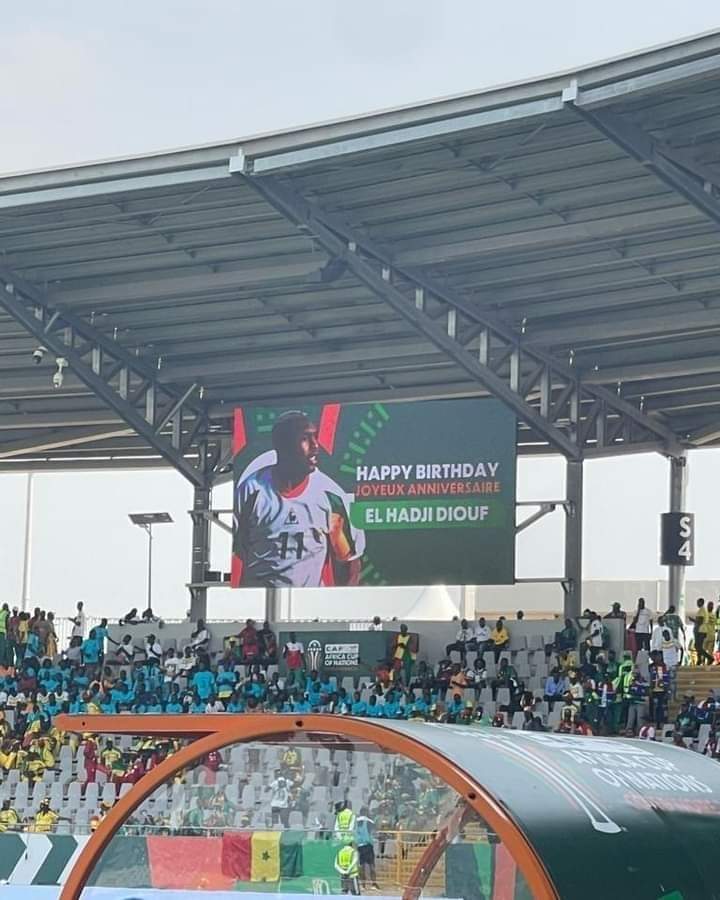 Deuxième Image de Football. La légende vivante du football sénégalais, El Hadji Diouf, a été célébrée avec éclat lors d'un match historique opposant le Sénégal à la Gambie. La Confédération africaine de football (CAF) a rendu hommage à ce joueur emblématique en projetant un message sur l'écran géant du stade, souhaitant à Diouf un joyeux anniversaire. Cette soirée spéciale était dédiée à commémorer l'anniversaire de sa consécration en tant que Ballon d'Or africain, un titre qui a gravé son nom dans l'histoire du football continental. Le stade était vibrant d'une énergie électrique alors que les supporters, venus en masse, saluaient l'icône sénégalaise. Les applaudissements retentissants et les chants passionnés témoignaient de l'affection profonde que le peuple sénégalais portait à El Hadji Diouf, un héros national dont le parcours exceptionnel avait transcendé les frontières du football pour devenir une source d'inspiration. Le message affiché en lettres lumineuses sur l'écran principal reflétait la gratitude et le respect que la CAF et le monde du football en général éprouvaient envers Diouf. « Joyeux anniversaire à El Hadji Diouf, le Ballon d'Or africain qui a illuminé nos terrains de jeu et nos cœurs. Merci pour tes exploits inoubliables et ta contribution exceptionnelle au football africain. » La cérémonie d'honneur a été suivie par une rétrospective captivante de la carrière légendaire de Diouf. Des images emblématiques de ses moments triomphants, de ses dribbles magistraux et de ses célébrations emblématiques ont défilé devant les yeux émus des spectateurs. Des interviews avec des coéquipiers, des adversaires et des personnalités du monde du football ont souligné l'impact indélébile de Diouf sur le sport et sa contribution à l'élévation du football africain sur la scène mondiale. Né dans les rues animées de Dakar, Diouf a surmonté les défis pour devenir une figure légendaire du football mondial. Son talent brut et sa détermination inébranlable ont été le moteur de son ascension fulgurante dans le monde du football professionnel. Des débuts modestes sur les terrains de quartier à l'éclat international, Diouf a incarné la persévérance et l'excellence. Le Ballon d'Or africain a non seulement brillé sur le terrain, mais il a également été un ambassadeur passionné du football en dehors du cadre compétitif. Ses œuvres caritatives et ses efforts pour promouvoir le sport auprès des jeunes ont solidifié sa place en tant que modèle et mentor pour les générations futures. La célébration de son anniversaire lors du match du Sénégal contre la Gambie a symbolisé l'unité du peuple sénégalais derrière son héros. Les drapeaux nationaux flottaient fièrement, et les chants de soutien résonnaient dans tout le stade. Diouf, ému par cette démonstration d'affection, a adressé un discours chaleureux de remerciement à ses fans, exprimant sa gratitude pour leur soutien indéfectible tout au long de sa carrière. La soirée s'est conclue par une ovation debout, alors que Diouf saluait la foule avec humilité et reconnaissance. La scène était empreinte d'une émotion palpable, symbolisant la connexion profonde entre le joueur et son public. Les festivités se sont poursuivies avec des feux d'artifice illuminant le ciel nocturne, marquant la fin d'une soirée mémorable dédiée à l'héritage durable d'El Hadji Diouf. En rétrospective, cet événement a transcendé le simple cadre d'un match de football pour devenir une célébration collective de l'excellence, du courage et de la passion. La CAF a réussi à capturer l'esprit du football en mettant en lumière une figure aussi emblématique, rappelant au monde entier l'impact positif que le sport peut avoir sur la vie des individus et des communautés. La légende d'El Hadji Diouf continuera à inspirer les générations futures, laissant derrière elle un héritage qui transcende les frontières du temps et de l'espace.