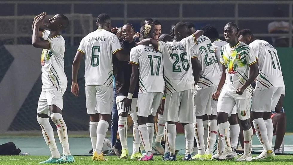 Image de Football. Le match entre le Mali et l’Afrique du Sud à la Coupe d'Afrique des Nations (CAN) 2024 restera gravé dans les annales comme un exemple de combativité et de résilience. La première place de la poule E, désormais occupée par les Aigles maliens suite à leur victoire de 2-0 sur les Bafana Bafana et à la défaite surprise de la Tunisie contre la Namibie, témoigne de la dynamique changeante du football africain. La ville de Korhogo, située près de la frontière malienne et hôte des matchs de la poule E, a vu une première heure de jeu difficile pour les Aigles. Face à une équipe sud-africaine coriace, le Mali a peiné à imposer son jeu. C'est seulement après 60 minutes que l’équipe d’Éric Chelle a su justifier son statut de favori, avec un tournant marqué par le coup franc de Sékou Koita, suivi par le but du capitaine Hamari Traoré. L’Afrique du Sud, encore sous le choc, a concédé un second but par Lassine Sinayoko, bien servi par Kamory Doumbia. Le match a également été marqué par le duel entre Percy Tau de l’Afrique du Sud et le gardien malien Djigui Diarra. Dans un premier temps, Tau, joueur d'Al Ahly en Égypte, a mis Diarra, évoluant chez les Young Africans en Tanzanie, à l'épreuve avec une frappe puissante. Puis, un penalty obtenu par l'attaquant Evidence Makgopa a offert une occasion en or à l’Afrique du Sud. Cependant, Tau a envoyé le ballon au-dessus de la barre, manquant une chance cruciale pour son équipe. La tactique sud-africaine, basée sur un 4-4-2 agressif, a causé des problèmes considérables au Mali, les forçant souvent à reculer. Malgré leur domination initiale, les Bafana Bafana n’ont pas su capitaliser sur leurs occasions, permettant au Mali de revenir en force dans la seconde moitié du match. Cette rencontre souligne l'évolution tactique et technique du football africain. Les équipes du continent, jadis considérées comme dépendantes de la puissance physique et de la vitesse, démontrent une maturité tactique croissante. Le Mali, par exemple, a su adapter son jeu en cours de match, passant d'une approche défensive à une stratégie plus offensive. Cette flexibilité tactique a été cruciale pour renverser le cours du jeu. L’Afrique du Sud, malgré sa défaite, a montré qu’elle reste une équipe compétitive sur la scène africaine. Leur performance contre le Mali, surtout en première mi-temps, est la preuve de leur capacité à tenir tête aux grandes équipes du continent. La progression du football sud-africain, depuis leur hôte de la Coupe du Monde en 2010, continue de susciter admiration et respect. Le parcours du Mali dans ce tournoi soulève également des questions sur la préparation et la gestion des équipes nationales en Afrique. Le succès des Aigles peut être attribué à une combinaison de talents individuels, d'une bonne préparation et d'une stratégie efficace. Cela amène à réfléchir sur l'importance de la formation des jeunes joueurs, de l'infrastructure sportive et de la gouvernance dans le football africain. En conclusion, ce match a été un parfait exemple de la passion, du talent et de l’esprit compétitif qui caractérisent le football africain. Alors que le Mali célèbre sa victoire et se prépare pour la suite du tournoi, et l’Afrique du Sud réfléchit à ses erreurs et à ses opportunités manquées, la CAN 2024 continue d'offrir des moments de football passionnants et imprévisibles. La victoire du Mali n'était pas seulement un triomphe sur le terrain, mais aussi un signe de la profondeur et de la qualité croissantes du football africain. Les Aigles, avec leur mélange de joueurs expérimentés et de jeunes talents, ont démontré leur capacité à s'adapter et à surmonter les défis. Cette résilience, couplée à leur technique et à leur esprit d'équipe, les positionne comme une force majeure dans le tournoi. La défaite de l’Afrique du Sud, quant à elle, soulève des questions sur leur capacité à convertir les occasions en buts et à maintenir leur concentration tout au long du match. Malgré une performance robuste en première mi-temps, leur incapacité à capitaliser sur les occasions créées et à résister à la pression malienne en seconde période a été leur perte. La CAN 2024 est également une vitrine pour les talents individuels. Des joueurs comme Percy Tau et Djigui Diarra sont des exemples de la richesse du football africain en termes de talents individuels. Leurs performances dans des matchs cruciaux tels que celui-ci attirent l'attention non seulement des fans africains, mais aussi des clubs et des ligues du monde entier. En parallèle, l'importance de la tactique et de la préparation d'équipe ne peut être sous-estimée. L’entraîneur du Mali, Éric Chelle, a démontré sa capacité à lire le jeu et à ajuster sa stratégie en conséquence. Son approche a permis au Mali de surmonter un adversaire difficile et de sécuriser une place de premier dans leur groupe. La compétition, avec ses hauts et ses bas, continue de captiver les spectateurs à travers le continent et au-delà. Chaque match est une histoire de courage, de talent et de passion, reflétant la richesse et la diversité du football africain. En dehors du terrain, la CAN 2024 a aussi ses implications socio-économiques et culturelles. Elle offre une plateforme pour la promotion du tourisme, l'unité nationale et la fierté continentale. Chaque match est une occasion pour les pays participants de montrer leur culture et leur hospitalité, renforçant ainsi les liens entre les nations africaines. Alors que le Mali se prépare pour les prochains défis du tournoi, il est clair que leur chemin n'est pas dénué d'obstacles. Cependant, avec leur détermination actuelle et leur esprit combatif, ils sont bien positionnés pour faire face à n'importe quel adversaire. Enfin, cette victoire du Mali et la performance générale des équipes dans la CAN 2024 soulèvent une question ouverte importante : Comment les succès et les défis rencontrés par les équipes africaines dans des tournois comme la CAN influencent-ils la perception du football africain sur la scène mondiale ?