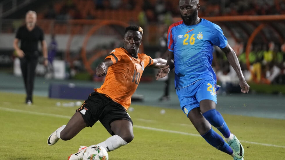 Image de Football. Le match du mercredi 17 janvier à San Pedro entre la République démocratique du Congo (RDC) et la Zambie a suscité des attentes élevées, notamment avec la présence de leaders tels que Chancel Mbemba, Gaël Kakuta et Cédric Bakambu du côté congolais. L'équipe congolaise, surnommée les "Léopards", cherchait à faire oublier son absence à la précédente Coupe d'Afrique des Nations (CAN) au Cameroun et à marquer son retour dans le prestigieux tournoi africain. Malgré une domination apparente, la RDC a dû se contenter d'un match nul face à une équipe zambienne réaliste. Les Chipolopolos, champions d'Afrique en 2012, ont ouvert le score grâce à Kings Kangwa, profitant d'une opportunité rare (1-0). Cependant, la réaction rapide de la RDC, avec l'égalisation de Yoane Wissa sur une passe décisive de Cédric Bakambu, a maintenu l'équilibre (1-1). Sous la direction de l'entraîneur Sébastien Desabre, la RDC faisait son entrée en Côte d'Ivoire, faisant face à une Zambie qui, malgré son titre de championne en 2012, avait depuis traversé des périodes difficiles et manqué plusieurs éditions de la CAN. L'actuel entraîneur des Chipolopolos, Avram Grant, ancien entraîneur de Chelsea, s'efforce de redonner vie à l'équipe, bien que la défaite contre le Niger en qualification pour le Mondial 2026 ait montré qu'il reste du travail à faire. La première période du match a été caractérisée par la rapidité de l'ouverture du score par la Zambie, mais la RDC a riposté avec détermination grâce à Wissa. Malgré les tentatives des Congolais, la joie des supporters n'a pas été renouvelée avant la pause. La seconde période a vu la RDC tenter à plusieurs reprises de prendre l'avantage, mais des tirs non cadrés et des tentatives infructueuses ont maintenu le score à égalité. Au-delà du résultat du match, cette confrontation a illustré deux équipes cherchant à retrouver leur place dans le paysage footballistique africain. Les Léopards, ayant atteint les huitièmes de finale en 2019 avant de buter contre Madagascar, aspirent à un parcours plus prometteur cette fois-ci. La Zambie, souvent dominée pendant le match, peut se satisfaire d'un résultat nul qui signale son retour sur la scène continentale. Alors que la RDC signe un retour timide dans la compétition, la question qui persiste est de savoir si cette équipe pourra surmonter les obstacles à venir et réaliser un parcours plus remarquable dans cette CAN 2024. La Zambie, de son côté, doit-elle considérer ce match comme un signe encourageant de résilience ou comme une alerte à l'amélioration? La suite de la compétition promet des rebondissements, et ces deux équipes auront l'occasion de démontrer leur véritable potentiel.