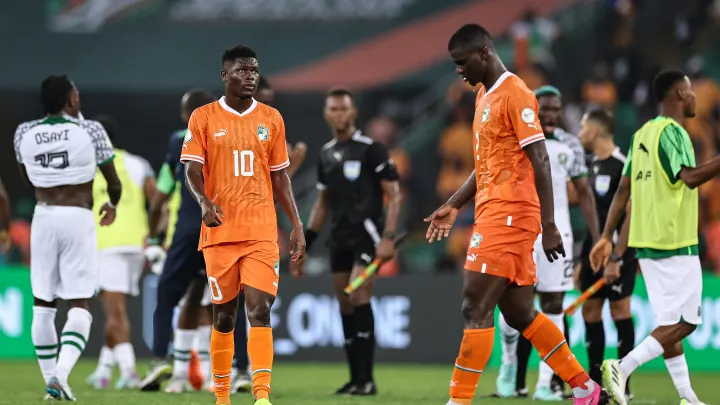 Image de Football. Le match entre la Côte d'Ivoire et le Nigeria à la Coupe d'Afrique des Nations (CAN) 2024, est loin d'être un simple événement sportif. C'est une rencontre chargée de symbolisme, d'histoire et de passion. Le football, plus qu'un simple jeu en Afrique, est un vecteur d'identité nationale, de fierté et parfois même de diplomatie. Ce match en particulier, mettant aux prises deux des plus grandes nations du football africain, est un récit riche en émotions, en tactiques et en implications plus larges pour les deux pays et pour le continent. Le Contexte Historique et Culturel La Côte d'Ivoire et le Nigeria ont une histoire footballistique riche, marquée par des succès et des rivalités. Le Nigeria, avec ses Super Eagles, est l'une des équipes les plus titrées d'Afrique, tandis que la Côte d'Ivoire, avec ses Éléphants, a toujours été une force majeure dans le football continental. Ce match, au-delà de l'enjeu sportif, est une question de fierté nationale. Dans les rues d'Abidjan comme dans celles de Lagos, le football est plus qu'un sport. C'est une échappatoire, une source de joie, et parfois un outil de cohésion sociale. Les joueurs ne sont pas seulement des athlètes, mais des héros nationaux, des modèles pour des millions de jeunes. Des joueurs comme Didier Drogba ou Jay-Jay Okocha sont bien plus que des noms; ils sont des symboles de réussite et d'unité. La Rivalité sur le Terrain La rencontre entre la Côte d'Ivoire et le Nigeria à la CAN 2024 s'inscrit dans une longue tradition de matches intenses. La rivalité sportive entre ces deux nations est ancienne et chaque match est un chapitre de plus dans leur histoire commune. Leur opposition est souvent marquée par un jeu physique, tactique et rapide. Cette année, le match revêt un enjeu particulier. Les Éléphants, sous la houlette de Jean-Louis Gasset, viennent avec l'intention de prouver leur suprématie. De leur côté, les Super Eagles, dirigés par un coach expérimenté, cherchent à asseoir leur statut de puissance dominante en Afrique. La tension est palpable dès le coup d'envoi. Analyse Tactique du Match Le match démarre sur un rythme effréné. La Côte d'Ivoire, avec un milieu de terrain dominé par la présence imposante de Séko Fofana, prend rapidement le contrôle du jeu. Les Ivoiriens privilégient une approche basée sur la possession et la construction patiente, tandis que les Nigérians, fidèles à leur style, misent sur la vitesse et les contre-attaques fulgurantes. La première mi-temps est un ballet tactique. Les Éléphants, malgré leur domination, peinent à concrétiser leurs occasions, se heurtant à une défense nigériane bien organisée et à un gardien en état de grâce. De l'autre côté, les attaquants nigérians, Osimhen, Lookman et Chukwueze, sont constamment à l'affût, menaçant la défense ivoirienne par leur vitesse et leur agilité. Le Tournant du Match : Le Penalty La seconde mi-temps commence par un événement qui change la donne : un penalty accordé au Nigeria. Cette décision, controversée, est un coup dur pour les Éléphants. Le capitaine nigérian, William Troost-Ekong, transforme le penalty avec sang-froid, plongeant le stade dans un silence momentané. La Réaction Ivoirienne Menée au score, la Côte d'Ivoire réagit avec vigueur. L'entrée en jeu de Nicolas Pépé, Jonathan Bamba et Jean-Michael Séri galvanise l'équipe. Les Éléphants poussent, multiplient les attaques, mais la défense nigériane, solide et disciplinée, résiste. Chaque tentative ivoirienne est repoussée, chaque espoir de but est étouffé par une défense nigériane déterminée. Les Implications du Résultat Le coup de sifflet final acte la victoire du Nigeria. C'est un coup dur pour les Éléphants, qui doivent maintenant affronter la Guinée-équatoriale dans un match décisif pour la qualification. Pour le Nigeria, c'est une affirmation de leur force et une étape de plus vers la conquête du titre continental. Au-delà du Match : Réflexions et Perspectives Ce match, au-delà de son résultat, est une démonstration de la passion et de l'engagement que suscite le football en Afrique. Il souligne l'importance du sport en tant que vecteur d'identité nationale et de fierté. Dans les cafés d'Abidjan et les rues de Lagos, les discussions se poursuivent longtemps après le match, analysant chaque moment, chaque décision. Pour les joueurs, c'est une expérience enrichissante, un moment de leur carrière qui restera gravé dans leur mémoire. Pour les fans, c'est une montagne russe d'émotions, de l'excitation à la déception, de l'espoir à la résignation. Alors que la Côte d'Ivoire se prépare pour son match décisif contre la Guinée-équatoriale et que le Nigeria se projette vers les phases finales, une question demeure : jusqu'où l'esprit d'équipe, la passion et l'unité peuvent-ils mener une nation dans une compétition aussi relevée que la CAN ?