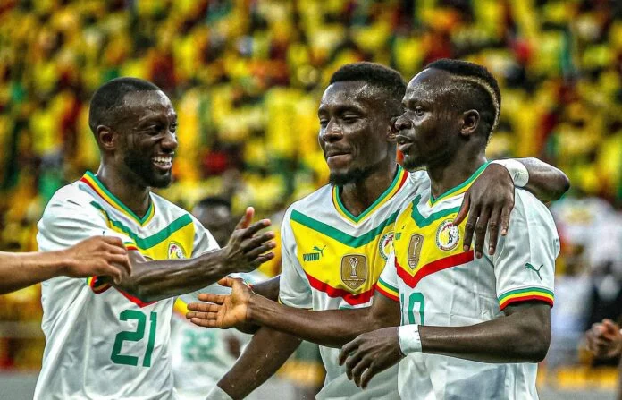 Image de Football. La suspension d'Abdou Lahad Diallo pour le match crucial entre le Sénégal et la Guinée lors de la CAN 2023 pose une question essentielle sur l'impact des absences clés et la gestion des effectifs dans les tournois majeurs. Ce cas spécifique offre un aperçu de la manière dont les équipes s'adaptent à ces défis, mais il soulève également des questions plus larges sur la stratégie, la profondeur de l'équipe et la préparation mentale et physique des joueurs. Le Sénégal, déjà qualifié pour les huitièmes de finale, doit maintenant aborder un match délicat sans l'un de ses piliers défensifs. Abdou Diallo, avec son expérience et ses compétences, a été un élément central dans la stratégie défensive d'Aliou Cissé. Sa suspension, due à l'accumulation de cartons jaunes, témoigne de la rigueur et de l'intensité du football moderne, où chaque action peut avoir des conséquences significatives. La perte de Diallo s'ajoute à celle de Moussa Niakhaté, un autre défenseur de premier plan, rendant la tâche plus ardue pour le Sénégal. Cela met en lumière l'importance de la profondeur de l'équipe dans les compétitions internationales. Un bon banc est indispensable, non seulement pour faire face aux suspensions et blessures, mais aussi pour maintenir un niveau de performance élevé tout au long du tournoi. Heureusement pour le Sénégal, Abdoulaye Seck, défenseur de Maccabi Haifa, est un remplaçant capable. Ses performances antérieures en sélection suggèrent qu'il peut être plus qu'un simple intérimaire. Seck apporte une robustesse et une expérience qui pourraient s'avérer cruciales, surtout dans un match à haute tension contre la Guinée. La préparation mentale et physique des remplaçants est tout aussi importante que celle des titulaires. Seck, et d'autres dans une situation similaire, doivent être prêts à intervenir à tout moment. Cela requiert non seulement une préparation physique constante, mais aussi une forte résilience mentale et une compréhension profonde des stratégies de l'équipe. Le match contre la Guinée sera disputé à Yamoussoukro, un lieu symbolique pour le football africain. La pression sera énorme non seulement à cause de l'enjeu du match, mais aussi en raison du contexte historique et culturel. Ce sera un test pour la force mentale et la cohésion de l'équipe sénégalaise. D'un point de vue tactique, le sélectionneur du Sénégal, Aliou Cissé, devra probablement ajuster son schéma défensif. Avec Koulibaly en tant que capitaine et leader de la défense, il devra probablement guider Seck à travers ce match critique. Cela pourrait aussi influencer la manière dont le Sénégal aborde le match d'un point de vue offensif, peut-être en adoptant une approche plus prudente ou en mettant l'accent sur la possession pour réduire la pression sur la défense. La Guinée, consciente de ces absences, pourrait chercher à exploiter cette situation. Cela pourrait se traduire par une pression offensive accrue, en ciblant spécifiquement les zones normalement occupées par Diallo. La bataille tactique entre les deux entraîneurs pourrait donc s'avérer déterminante dans le résultat du match. Le Sénégal, en tant que l'une des équipes favorites de la CAN, doit non seulement gérer les attentes mais aussi démontrer sa capacité à surmonter les adversités. Cela implique de maintenir un haut niveau de performance malgré les changements de personnel et de s'adapter rapidement aux circonstances changeantes. Le contexte plus large de cette situation souligne l'importance de la gestion d'équipe dans les tournois. Les entraîneurs doivent non seulement préparer les joueurs tactiquement et physiquement, mais aussi gérer leurs émotions et leur état mental, surtout dans un environnement aussi compétitif et exigeant que la CAN. En conclusion, la suspension d'Abdou Lahad Diallo pose un défi significatif pour le Sénégal, mais offre également une opportunité pour d'autres joueurs de se montrer. Cette situation met en lumière l'importance de la profondeur de l'équipe, de la préparation mentale et physique, et de la flexibilité tactique dans les tournois internationaux. Alors que le Sénégal se prépare pour le match contre la Guinée, il sera intéressant de voir comment l'équipe s'adapte et répond à ces défis. La question ouverte qui se pose est la suivante : Comment les équipes peuvent-elles mieux préparer et gérer leurs joueurs pour faire face aux suspensions et aux blessures inévitables dans les grandes compétitions, tout en maintenant une haute performance et en répondant aux attentes élevées des supporters et des médias?