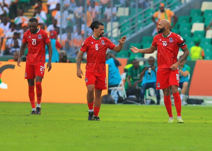 Deuxième Image de Football. La surprenante victoire de la Guinée équatoriale sur la Côte d'Ivoire dans leur dernier match de groupe de la CAN 2023 a été un moment déterminant dans l'histoire du football de ce petit pays d'Afrique centrale. Le Stade Alassane Ouattara d’Ebimpé, un joyau architectural et un symbole de fierté nationale pour la Côte d'Ivoire, a été le théâtre d'une performance exceptionnelle de la part du Nzalang Nacional, l'équipe nationale de la Guinée équatoriale. Leurs quatre buts contre aucun pour les Éléphants ont non seulement bouleversé les pronostics, mais ils ont également redéfini la perception du football en Guinée équatoriale. Contexte Historique et Sportif de la Guinée Équatoriale La Guinée équatoriale, souvent éclipsée sur la scène sportive internationale par des géants africains comme la Côte d'Ivoire, le Nigeria, ou le Cameroun, a rarement été sous les feux de la rampe. Ce pays, avec une population d'environ 1,4 million d'habitants, a connu un parcours difficile dans le football international, marqué par des hauts et des bas. La victoire contre la Côte d’Ivoire a été un exploit remarquable, montrant que même les nations les moins attendues peuvent réaliser des performances époustouflantes. La Réaction du Président Teodoro Obiang Nguema L'annonce par le président Teodoro Obiang Nguema d'une prime d'un million d'euros pour l'équipe nationale reflète non seulement la joie et la fierté nationales suscitées par cette victoire, mais aussi un engagement politique envers le sport. Cette récompense financière, exceptionnelle pour les normes du football africain, est un geste de reconnaissance et d'encouragement pour les joueurs et le staff technique. Elle témoigne de l'importance du football comme vecteur d'unité et de fierté nationales. L'Impact de la Prime sur les Joueurs Pour les joueurs, cette prime représente bien plus qu'une simple récompense financière. Elle est un signe de reconnaissance pour leur travail acharné, leur dévouement et leur succès. Emilio Nsue, le capitaine de l'équipe, et ses coéquipiers ont démontré une cohésion et une détermination qui ont été la clé de leur succès. Ce genre de motivation peut avoir un effet profond sur la performance de l'équipe dans les matchs à venir. Analyse du Match Contre la Côte d'Ivoire Le match contre la Côte d'Ivoire a révélé plusieurs aspects tactiques et techniques qui ont été cruciaux pour la victoire de la Guinée équatoriale. L'équipe a fait preuve d'une organisation défensive solide, d'une contre-attaque rapide et efficace, et d'une finition précise devant le but. La défaite de la Côte d'Ivoire, un pays avec une histoire riche dans le football africain, a mis en lumière les surprises et l'incertitude inhérentes au sport. Le Rôle des Entraîneurs et du Staff Technique Derrière le succès de l'équipe se trouve une équipe d'entraîneurs et de staff technique dévouée. Leur stratégie, leur préparation et leur capacité à motiver et à tirer le meilleur de chaque joueur ont été essentielles. Ces professionnels souvent non reconnus jouent un rôle crucial dans le développement des compétences des joueurs et dans la mise en place de tactiques gagnantes. La Suite de la Compétition pour la Guinée Équatoriale Avec cette victoire, la Guinée équatoriale a non seulement assuré sa place dans les prochaines phases de la CAN 2023, mais elle a également envoyé un message fort aux autres équipes. La compétition reste ouverte, et le Nzalang Nacional a prouvé qu'il pouvait rivaliser avec les meilleures équipes du continent. Le Football en Guinée Équatoriale : Passé, Présent et Futur Cette victoire historique est un moment clé dans l'histoire du football en Guinée équatoriale. Elle offre une opportunité de réfléchir sur le passé, le présent et l'avenir du football dans ce pays. Comment le succès actuel peut-il influencer le développement du sport au niveau national ? Quelles leçons peuvent être tirées pour améliorer les infrastructures, la formation des jeunes talents et la promotion du football à tous les niveaux ? Impact sur la Jeunesse et la Société Équato-Guinéenne Le succès de l'équipe nationale a un impact profond sur la jeunesse et la société en général en Guinée équatoriale. Il inspire les jeunes à poursuivre leurs rêves et à s'engager dans le sport. De plus, il renforce le sentiment d'unité nationale et de fierté parmi la population. L'Avenir du Football Africain Cette victoire soulève également des questions sur l'avenir du football africain. Comment les nations plus petites et moins connues peuvent-elles continuer à progresser et à défier les géants traditionnels du continent ? Quel rôle les gouvernements, les fédérations et les communautés locales doivent-ils jouer pour soutenir le développement du football ? En conclusion, la victoire de la Guinée équatoriale contre la Côte d'Ivoire et la prime généreuse accordée par le président Obiang Nguema symbolisent un tournant dans le football équato-guinéen. Cette performance remarquable soulève une question importante : comment les succès inattendus tels que celui de la Guinée équatoriale peuvent-ils transformer le paysage du football africain et encourager d'autres nations à redéfinir leurs ambitions et leurs stratégies dans le sport ?