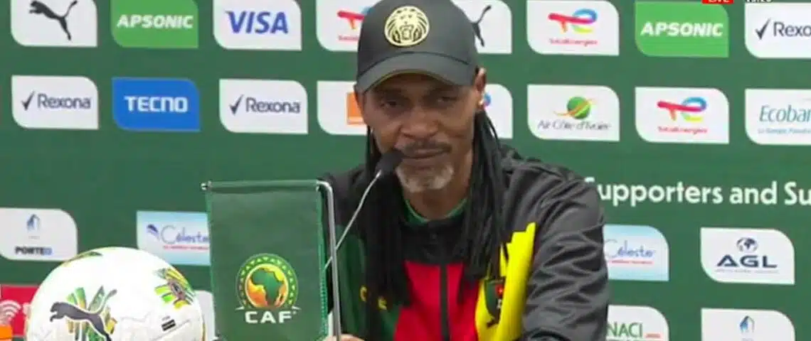 Image de Football. L'exploit des Lions Indomptables sous la houlette de Rigobert Song est un moment charnière dans l'histoire du football camerounais. Cette qualification pour les huitièmes de finale, obtenue dans un contexte de match intense contre la Gambie, marque non seulement un tournant pour l'équipe, mais aussi pour Song en tant que sélectionneur. La performance des Lions Indomptables reflète une évolution significative, tant sur le plan tactique que mental, révélant une équipe déterminée et unie face aux défis. Ce match contre la Gambie, riche en émotions et en rebondissements, a démontré la capacité des joueurs à faire face à la pression et à surmonter les obstacles. La tête salvatrice de Christopher Wooh dans les derniers instants du match est devenue un symbole de la résilience et de l'esprit combatif de l'équipe. Cette victoire n'est pas seulement le résultat d'une bonne stratégie ou d'une préparation physique, mais aussi le fruit d'une forte cohésion d'équipe et d'un moral inébranlable. Le parcours de Rigobert Song en tant que sélectionneur reflète son engagement envers l'équipe et son désir de la mener vers le succès. Après des échecs successifs au CHAN 2018, à la CAN U23 et à la Coupe du Monde 2022, cette qualification marque un jalon important dans sa carrière. En dépit des critiques et des doutes, Song a su instiller dans son équipe un sentiment de fierté nationale et un esprit de combativité. L'importance de cette victoire va au-delà de la qualification pour les huitièmes de finale. Elle représente un renouveau pour le football camerounais, une affirmation de son statut sur la scène africaine et internationale. L'esprit d'équipe, la détermination et la passion manifestés par les Lions Indomptables sont des éléments qui pourraient influencer de manière significative le futur du football camerounais. En analysant les tactiques employées par Song, on peut observer une évolution dans son approche du jeu. Il a réussi à combiner les talents individuels de chaque joueur pour créer une synergie efficace sur le terrain. Cette capacité à fusionner les compétences individuelles en une force collective est un aspect crucial de son succès en tant que sélectionneur. La réaction positive et enthousiaste du public camerounais et des fans de football à travers le continent africain témoigne de l'impact de cette victoire. Elle a ravivé la passion et l'espoir dans le cœur des supporters, qui voient désormais en leur équipe un potentiel champion. Cependant, ce succès ne doit pas masquer les défis à venir. L'équipe doit continuer à se développer et à affiner sa stratégie pour affronter les adversaires plus coriaces qui l'attendent dans les phases ultérieures du tournoi. La capacité de l'équipe à s'adapter et à évoluer sera cruciale pour maintenir son élan et atteindre des sommets plus élevés. Alors que les Lions Indomptables se préparent pour les prochains défis, la question demeure : peuvent-ils maintenir cet esprit de combat et cette unité pour surmonter les obstacles futurs et éventuellement remporter le titre ?