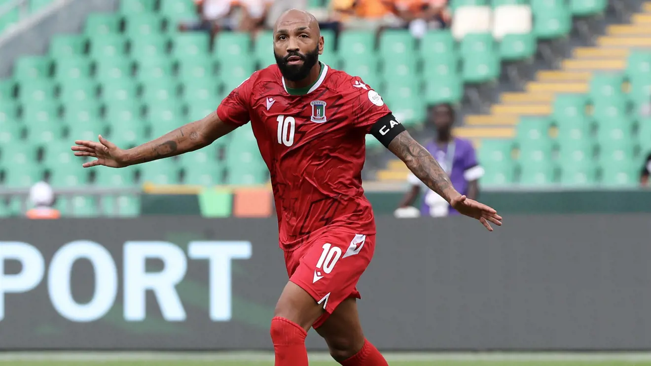 Image de Football. Le parcours d'Emilio Nsue, d'un footballeur sans club devenu le meilleur buteur de la Coupe d'Afrique des Nations (CAN) en 2023, est une histoire de résilience, de détermination et d'une passion inébranlable pour le jeu. Son ascension dans le paysage du football africain, surtout à un moment où sa carrière semblait être en déclin, témoigne de son travail acharné et de sa dévotion. Les premières années de Nsue ont été marquées par une expérience diversifiée à travers diverses ligues et clubs. Né d'une mère espagnole et d'un père équatoguinéen, il a commencé sa carrière à Majorque, montrant son talent en Espagne avant de se déplacer dans différents pays, y compris des passages en Angleterre avec Middlesbrough et à Chypre avec l'APOEL Nicosie. Cependant, son parcours n'a pas été sans défis. Il a connu un revers significatif lorsqu'il s'est retrouvé sans club et sans emploi pendant 16 mois. Malgré ces défis, Nsue est resté concentré sur ses aspirations footballistiques. Sa détermination a payé lorsqu'il a été appelé à représenter la Guinée équatoriale, la terre de son père. Ses débuts pour l'équipe nationale n'ont rien eu de banal, marqués par un triplé contre le Cap-Vert. Bien que le match ait ensuite été attribué au Cap-Vert en raison de problèmes d'éligibilité, cela n'a pas découragé Nsue. Il est rapidement devenu une partie intégrante de l'équipe, décrochant même le brassard de capitaine. L'impact de Nsue sur le football de la Guinée équatoriale a été immédiat et profond. Il a été accueilli avec adulation et respect, témoignant de l'appréciation de la nation pour sa décision de les représenter. Son expérience lors de la CAN deux ans auparavant, où il avait participé tout en étant sans emploi, a été un motivateur significatif pour lui. Malgré ne pas être au mieux de sa forme physique lors de ce tournoi, cela a alimenté son désir d'exceller dans l'édition de 2023. À 34 ans, Nsue a défié l'âge et les attentes. Sa performance à la CAN 2023 a été spectaculaire, surpassant des talents africains renommés tels que Sadio Mané et Mohamed Salah. Son parcours reflète la nature imprévisible du football, où les fortunes peuvent changer rapidement, et la persévérance paie souvent. L'histoire de Nsue est également le reflet des identités complexes que de nombreux footballeurs naviguent. Malgré ses premiers succès avec les équipes de jeunes de l'Espagne, il a choisi de représenter la Guinée équatoriale, honorant l'héritage de son père. Cette décision a apporté une nouvelle dimension à sa carrière, lui offrant l'opportunité d'avoir un impact significatif sur une équipe nationale qui valorisait grandement ses contributions. La CAN 2023 a été un tournoi remarquable pour Nsue, une chance de réécrire son histoire, passant d'un joueur au bord de la retraite à être le meilleur buteur dans l'une des compétitions de football les plus prestigieuses d'Afrique. Son parcours sert d'inspiration à beaucoup, prouvant que les revers et les défis peuvent être des marches vers de plus grandes réussites. Alors que Nsue continue de diriger la Guinée équatoriale dans le tournoi, son histoire soulève des questions importantes sur la dynamique du football international, les défis auxquels sont confrontés les joueurs et l'impact de représenter une nation qui valorise profondément leurs contributions. Cela nous amène à nous interroger : comment le parcours de joueurs comme Emilio Nsue influence-t-il les aspirations et les rêves des jeunes footballeurs dans des pays tels que la Guinée équatoriale, et que peut-on apprendre de leurs expériences pour surmonter l'adversité ?